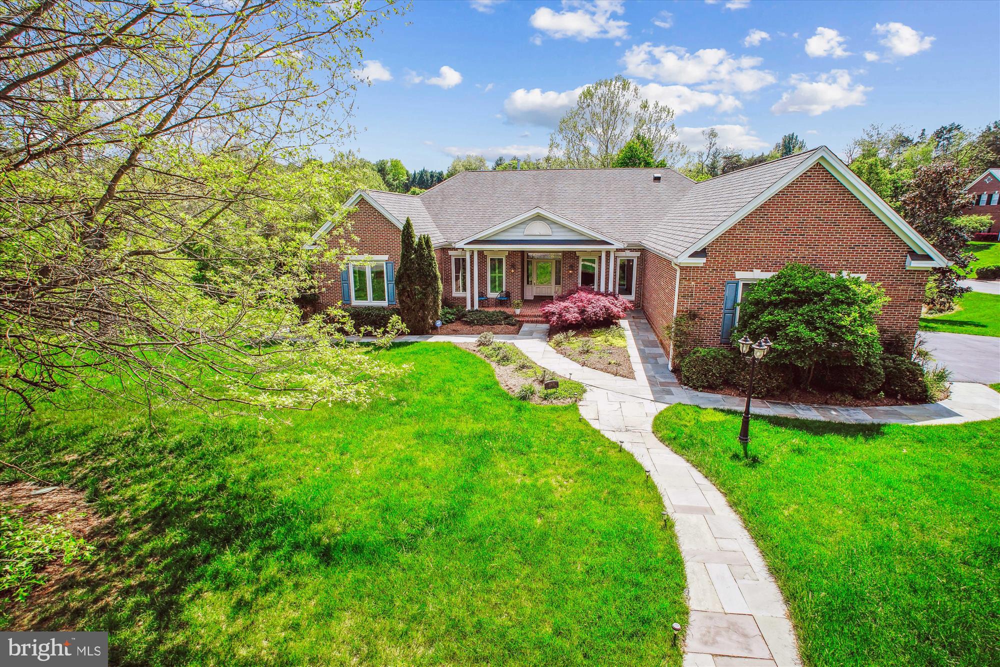 Luxury meets accessibility - this lovely estate home offers the perfect blend of functionality coupled with accessibility features that will be appreciated by those seeking main level living.  The discreet modifications  blend seamlessly with the beauty of the home.  Designed for multi-generational living with more than 3800+ square feet on the main level including dual primary suites and a guest room, plus an additional 2000+ square feet on the lower level with two additional bedrooms and a second kitchen.  Easily enter the main level from the flagstone ramp or steps up to the gracious front porch leading to the expansive foyer.  The main level boasts 12 foot ceilings and hardwood flooring throughout.  Marvel at the grand entry with inviting formal living room, or imagine holidays in the spacious dining room.  The heart of the home is the light filled "great room" with walls of windows to bring the beauty of the outdoors inside.  Gather in the fabulous chef's kitchen with extensive high quality cabinetry,  granite counters, a pantry wall, and premium appliances including a custom made copper hood.  Enjoy casual dinners in the dining nook with bay window and bench seating, gather around the cozy fireplace, or head outdoors to the deck and gazebo that are conveniently located off the great room.  The paneled library offers plenty of space to house a reading collection, and is a wonderful work from home spot.  Enter the bedroom wing from a wide hallway with a second office or guest room to your left, the hallway splits to offer two generously sized primary suites, both primary baths include a tub and shower.  The walk out lower level is equally as impressive and was designed as a potential in-law, au pair or caretaker suite with a large rec room, full second kitchen, two bedrooms, a gym, media room and full bath.  With more than 1200 square feet of shelved storage space and a workbench, there is ample room to store a lifetime of treasures.  The lower level can be accessed via the interior stairs from the main level or via outdoor flagstone path.  The outdoor spaces are as beautiful as the indoors offering privacy and wonderful views of nature and wildlife.  The .83 acre landscaped corner lot provides for maximum curb appeal with a stone path winding to the front of the home and the backyard backing to trees and a creek.  With a two level deck and gazebo enjoy relaxing or entertaining outdoors. An added bonus is the 3.5+ car garage with both ramp and steps into the mudroom.  Not only is the home spectacular, but the neighborhood offers tree-lined streets, stately homes and the most friendly neighbors! Weekends will be an adventure with the legendary Reston Farm Market, Zoofari and Lake Fairfax around the corner. The Silver Line Metro and the upscale shops and restaurants at Reston Town Center are minutes away. Sought after Fairfax County schools and conveniently located near several private school options - Oakcrest and Flint Hill. Easy access to commuter routes: 267 Toll Road, Route 7, Fairfax County Parkway and the Dulles Airport.