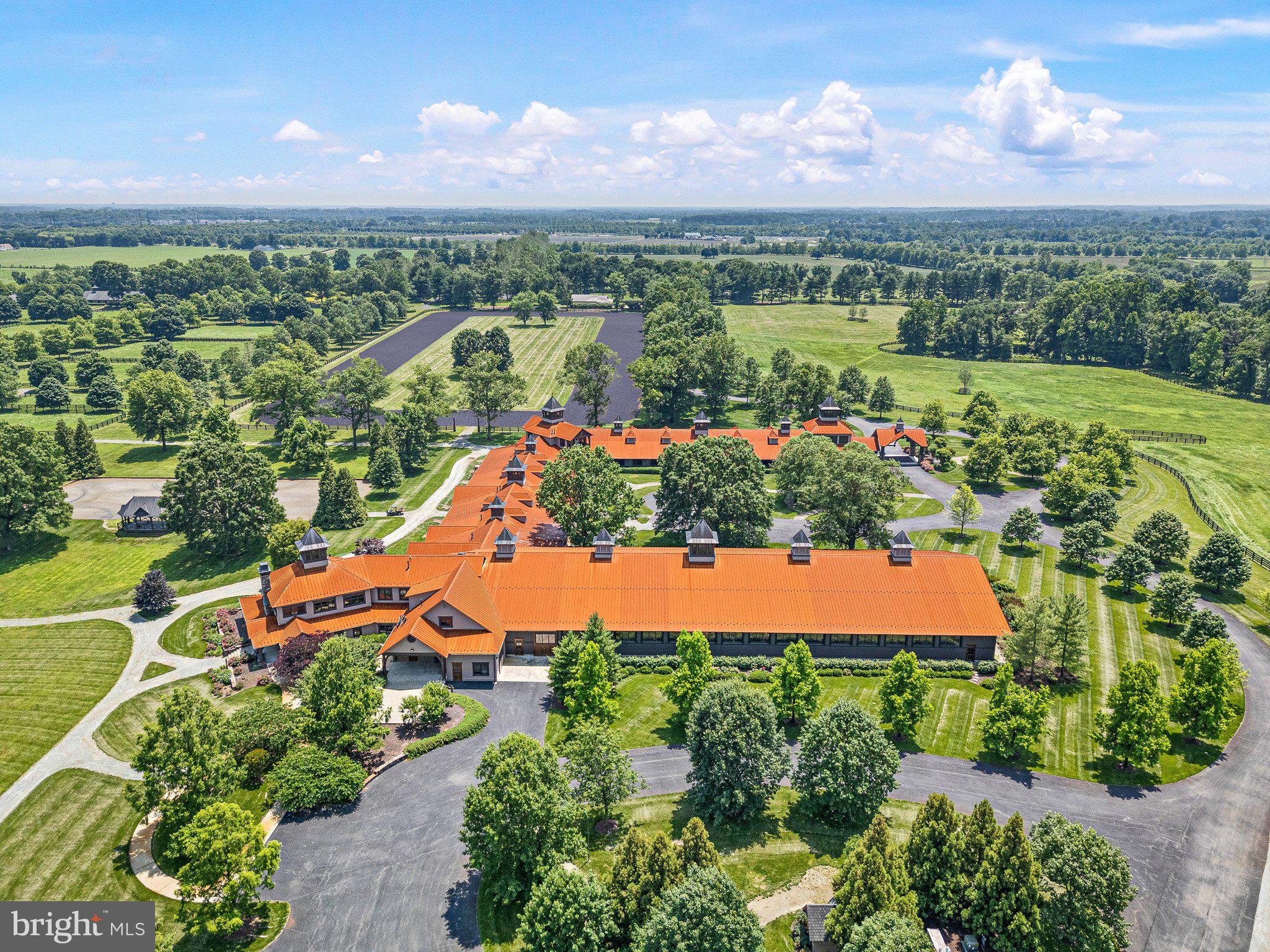 Rarely… does such a unique, well-designed, constructed, and maintained world-class equestrian facility grace the international real estate market. Spanning 510 preserved acres, this iconic equestrian estate boasts a rich legacy and unparalleled amenities, including a state-of-the-art equestrian training facility built by B&D Builders, a nationally renowned custom builder. RiverEdge Farm is synonymous with world-class equestrian training, ideally suited to any discipline. The farm has previously housed numerous Olympic dressage and three-day event horses, operated as a top-class private thoroughbred breeding facility, and most recently served as a training mecca for world-class dressage. At the heart of the property is a spectacular 31-stall, 45,000-square-foot indoor dressage show barn. Built with unmatched craftsmanship and old-world charm second to none. Visitors are welcomed through a charming, covered porch and elegant, glass-paneled double doors into a grand reception area featuring a central stone fireplace and a private meeting room, all adorned with custom millwork throughout. Overlooking the 100’ x 200’ indoor dressage arena are stunning glass-enclosed observation areas on both the first and second floors, that are brilliantly filled with natural light and character. This impressive space includes twin service bars, a conveniently located commercial-grade kitchen, and a spacious area ideal for entertaining. An ornate wide-plank staircase leads to a lofted second level with private office suites, an exercise room, and a lounge area. The barn itself is thoughtfully designed, featuring barreled ceilings, six grooming/wash stalls, two well-appointed tack rooms, a central eat-in kitchen/break area, a laundry room, and a three-season sitting room offering panoramic views through grand window walls on two sides. The barn’s layout seamlessly flows through a bank of 31 spacious (mostly 14’ x 14’) stalls, curving into an additional wing with even more accommodations. Complementing the equestrian facilities is a beautifully appointed 9,000-square-foot brick manor home of Georgian architectural style, offering four bedrooms and 3 full & 2 half bathrooms. This wonderful home features an updated kitchen, brick and antique wood flooring, beamed ceilings, a sunken living room, multiple fireplaces, a spacious game room, and a detached three-car garage. The extensive grounds are thoughtfully and professionally landscaped. It artfully blends traditional character with modern conveniences—perfectly suited for today’s lifestyle. Also included within this breathtaking property is a luxurious guest home featuring a chef’s kitchen and an enclosed timber-framed pavilion over a heated indoor pool. Additionally, there is a 15-stall center-aisle block barn with a six-horse Kraft Eurocizer, as well as numerous ancillary operational buildings, including a fully functional brick office building—and numerous double-fenced fields and paddocks with approximately 10 miles of four-rail post-and-board fencing offering unparalleled views throughout the farm. RiverEdge is set within one of Maryland’s largest agricultural preservation areas and is protected by a conservation easement, ensuring its beauty and legacy for generations to come. The property includes 4 parcels:  0802016206 - 109.4 acres, 0802019078 - 186.7 acres, 0802029049 - 106 acres, and 0802029537 - 109.4 acres.