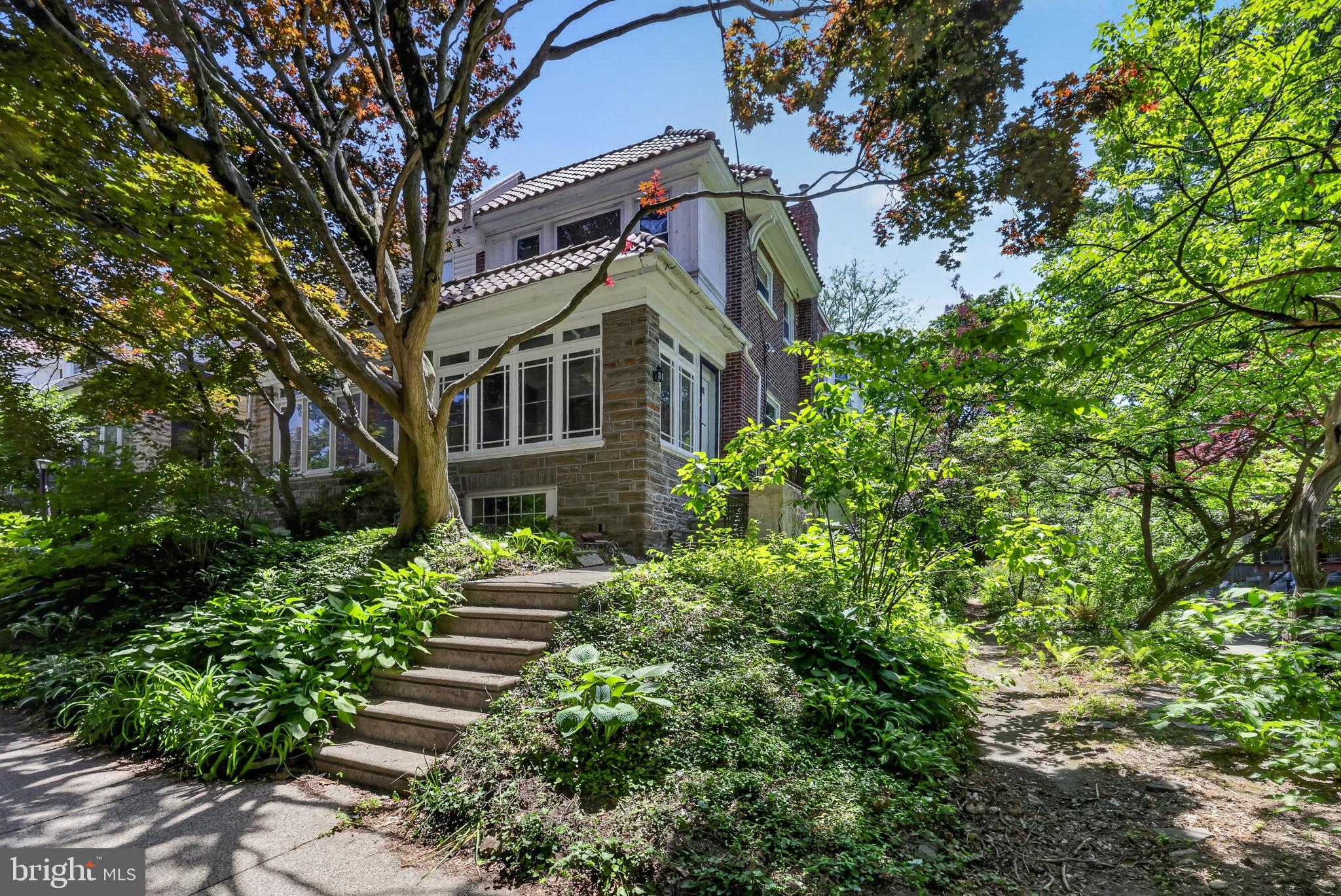 Welcome to this charming, light-filled twin nestled in the heart of desirable West Mount Airy. Ideally situated within walking distance of Carpenters Woods, Weavers Way Co-op, High Point Café, and the neighborhood's beloved shops and green spaces, this home offers an exceptional blend of character, convenience, and opportunity.

Step inside through the inviting sunroom and discover timeless details, including original built-ins, gleaming hardwood floors, and abundant natural light throughout. The spacious living room features a cozy fireplace, creating the perfect setting for relaxing evenings, while the adjoining formal dining room provides an ideal space for entertaining family and friends.

The oversized kitchen offers ample room for cooking, gathering, and hosting, with endless potential to create the culinary space of your dreams. Upstairs, a beautifully crafted staircase leads to a thoughtfully designed second floor featuring three generously sized bedrooms and two full bathrooms.

The finished walkout lower level expands the home's living space and includes a convenient laundry area and powder room, making it ideal for a family room, home office, gym, or guest space.

Outdoor living is equally appealing, with a deck just off the kitchen overlooking a large side yard and garden area—perfect for gardening, outdoor dining, or simply enjoying the peaceful surroundings. Tucked away at the end of a private lane, the property also offers the rare convenience of a garage and driveway parking.

Filled with character and great bones, this home presents an excellent opportunity to add your personal touches and create something truly special. Being sold in as-is condition.