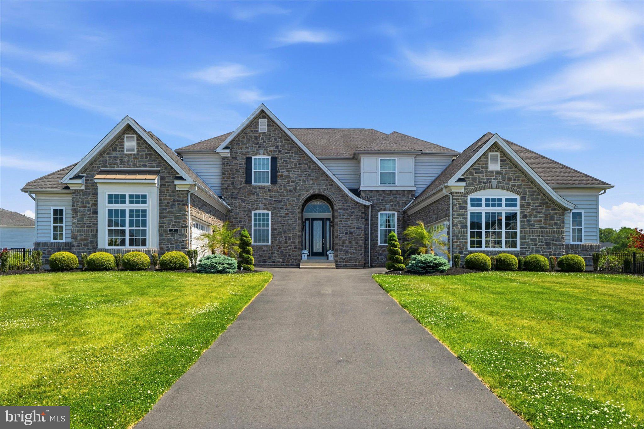 Located in the prestigious Reserve at Northampton, this exceptional home blends luxury, comfort, and resort-style amenities. Built in 2016, the property welcomes you with a breathtaking double curved staircase, coffered ceilings, and an oversized designer chandelier. The soaring 10-foot ceilings and rich hardwood flooring span the main level. Designed for both entertaining and everyday living, the open floor plan centers around a chef-inspired kitchen featuring granite countertops, a Thermador gas range, and Sub-Zero refrigerator. The conservatory offers the perfect game-day setup with its own fireplace and bar area. A private first-floor bedroom with en-suite bath creates an ideal guest retreat, while a dedicated office and elegant sitting room add flexibility to the layout. Upstairs, the luxurious primary suite includes a private sitting area with mini fridge, oversized walk-in closet, and spa-style bathroom. The second floor includes three spacious bedrooms, one of which is currently being used as a hair salon. The finished lower level is built for entertaining with a second full kitchen and multiple gathering spaces. The resort-style backyard features a modern pool with tanning ledges, an elevated hot tub, and expansive patio space complete with covered lounge areas, an outdoor kitchen/bar, and professional landscaping.
