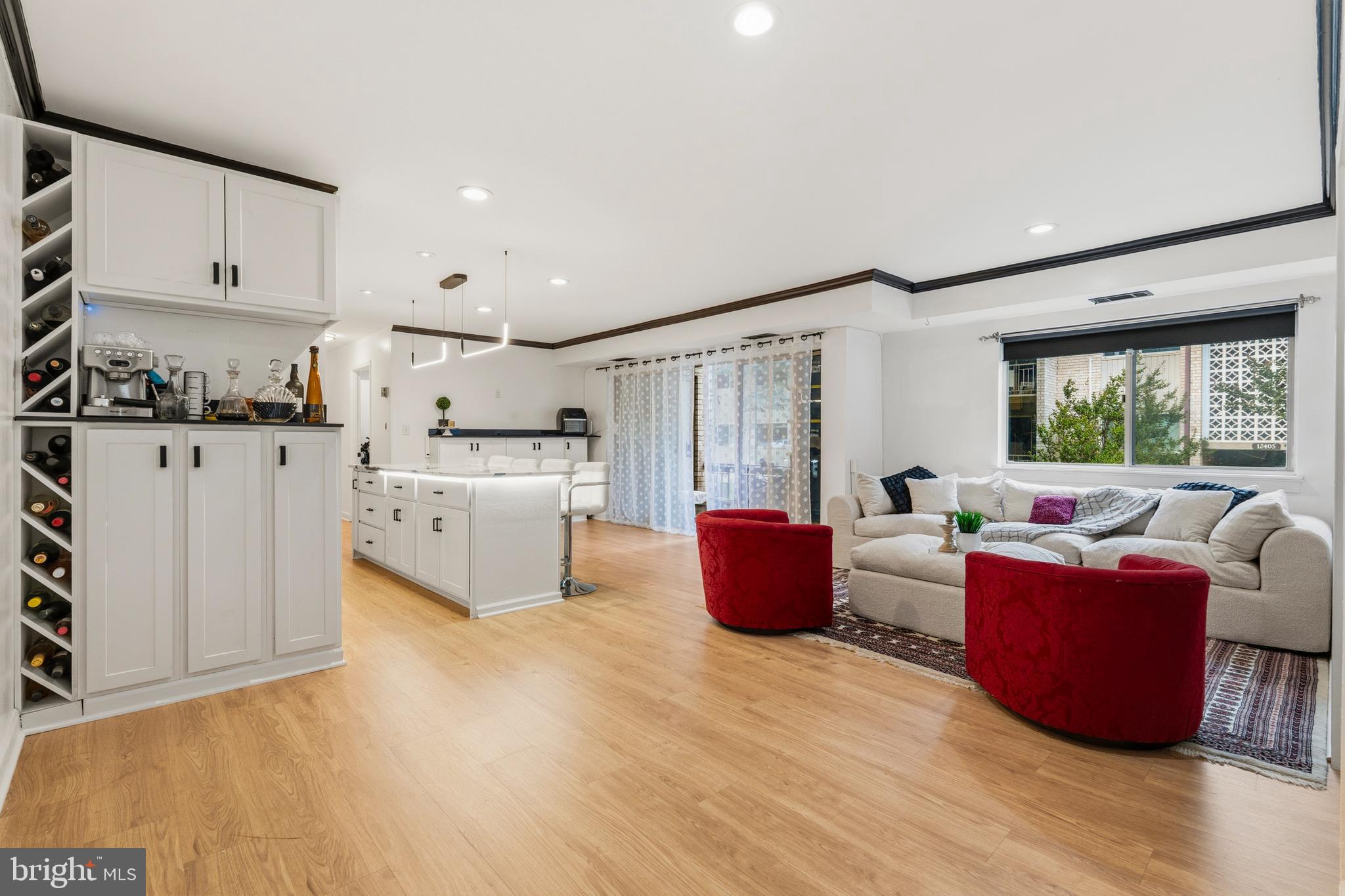 Urban convenience meets spectacular modern design! Located just 1 mile from the Twinbrook Metro and moments from Rockville Pike and Pike & Rose, this 3BR/1.5BA Bethesda Park condo offers the ultimate turnkey experience. The extensively updated open floor plan features a chef-ready kitchen with stainless appliances, white shaker cabinets, and a massive 5-seater island under sleek linear LED lighting. A bonus built-in buffet maximizes your storage and prep space. Gorgeous wood-tone floors and high-contrast dark crown molding lead you to expansive sliding glass doors and a peaceful private balcony. The primary suite delivers a large walk-in closet, accompanied by two versatile secondary bedrooms. Enjoy community pools, tennis courts, and park-like grounds right outside your door.