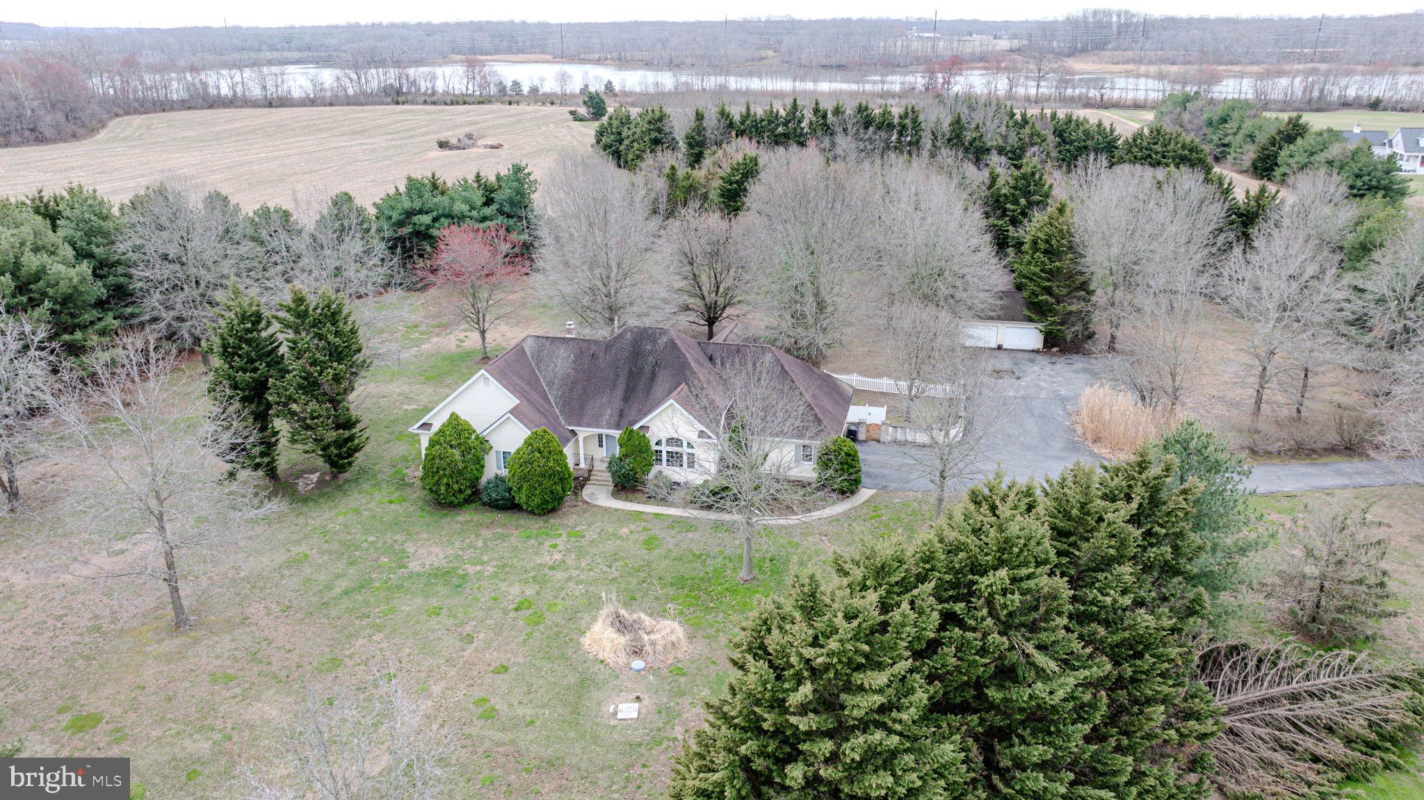 Are you looking for a home that has privacy and not on top of your neighbors?  This ranch style home is just outside of Odessa, Delaware and sits on 16 acres.  The home itself is a 3 bedroom ranch and has 3 and a half bedrooms.  It has a primary suite with his and her bathrooms. The house sits back off the road out of site and quiet. You Enter the home through a beautiful doorway with both sidelight and transom windows onto a ceramic tile floor. Straight ahead is the living room with raised ceiling, gas fireplace and double glass sliding doors that brings in the natural light. To the right is the dining room with hardwood floors, chandelier and lunette style window. This leads to the eat in kitchen with gas cooktop, wall oven, plenty of cabinets and counter space including a large pantry. The eat in area has hardwood floors, a Tiffany overhead light and French doors that open to the living room. Through the living room is a hallway that leads to the three large bedrooms with new carpet, 3 full bathrooms and plenty of closet space. Off the kitchen is an exterior exit to a screened porch that overlooks the rear yard with plenty of shade providing peace and quiet. There is also a laundry room with a half bath and the access to the two car garage.  An additional two/three car detached garage provides plenty of room for a workshop or additional vehicles/toys.  There is a full basement that has bilco doors and is ready to finish into additional space. The home is equipped with a generator for backup power.  A large portion ( 9 acres) is currently farmed by a neighboring farm through an annual agreement. Home is close enough to town to get to essentials and far enough away to allow you peace and tranquility.