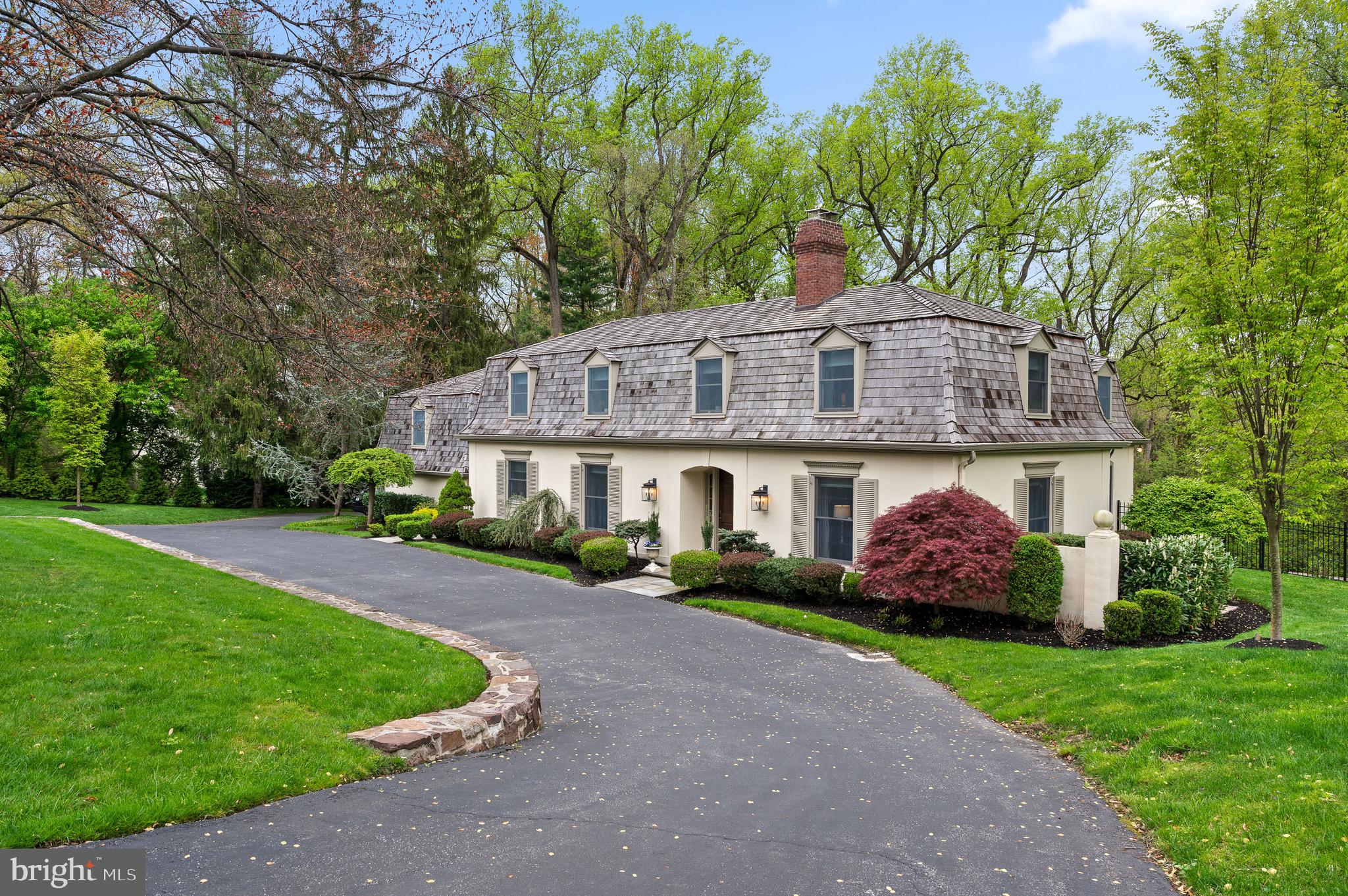 Nestled on a serene 1.85-acre parcel of land adorned with majestic trees and vibrant flora, this exquisite country French home exudes timeless elegance and charm. As you step through the stone entrance foyer, you are welcomed into a graceful oasis of sophisticated living.
The heart of the home unfolds into an expansive living room/family room, where sunlight dances through large picture windows, casting a warm glow over the inviting space. A wood-burning fireplace, adorned with a marble surround, beckons gatherings on chilly evenings, while the random width pegged wood floors add a touch of rustic refinement. A French door seamlessly connects to the side yard, inviting gentle breezes and the song of nature indoors.
Adjacent to the foyer, a cozy den/office boasts a coffered wood ceiling and a stone fireplace, creating a cozy retreat for work or relaxation. Built-in bookshelves, a wet bar, and more of those charming wood floors enhance the atmosphere of refinement.
The generously sized formal dining room offers an ideal setting for festive holiday feasts, featuring built-in shelving and cabinetry for convenient storage. Through attractive columns lies the extra-large breakfast room/family room with beautiful Brazilian cherry floors, adorned with a wall of picture windows framing picturesque views of lush greenery, French doors lead to an expansive wood deck, perfect for alfresco entertaining against the backdrop of the enchanting grounds.
The updated gourmet kitchen beckons with quartz countertops, a quartz island, Thermador gas range (fueled by propane) to the double oven, Sub Zero Refrigerator, prep sink, instant hot, and pantry cabinet, every detail is designed for culinary delight. White stone floors add a touch of charm, while multiple exits provide seamless access to various outdoor spaces, including the two-car attached garage.
Ascending to the second floor, discover a haven of comfort and luxury with five bedrooms and four bathrooms ( 3 bathrooms are ensuite). The primary suite is a serene retreat, boasting a tiled fireplace, dressing room with vanity with sink and an en-suite bathroom with a jetted soaking tub and shower. The second floor has ample storage abounds, including a cedar closet, ensuring a clutter-free environment.
The finished walk-out lower level offers additional living space, featuring a spacious recreation room with engineered wood floors and an arched brick fireplace, and windows letting in natural light. A separate large versatile room serves as a home gym . There is a sixth bedroom complete with ample windows for natural light. The laundry room, with an exit out to a flagstone patio and sitting wall, to the pool. The powder room, and large heater room complete the lower level, providing convenience and functionality. Whole house generator.
Nestled within the lush landscape of this idyllic property lies a captivating lagoon- inspired salt water pool, a serene oasis designed for relaxation and leisure. The pool's inviting waters glisten under the sun, mirroring the azure sky above. Encircled by a terrazzo surround, the pool areas exudes elegance and sophistication, providing ample
space for lounging in the sun or seeking shade beneath the canopy of a majestic pergola.
Perfectly situated on Beaumont Drive, this idyllic retreat offers a coveted blend of tranquility and convenience. Enjoy easy access to the village of Gladwyne, renowned for its gourmet food markets, boutique shops, and recreational amenities, including horse trails and tennis courts. With public and private elementary schools within walking distance, this home epitomizes the epitome of luxurious country living.