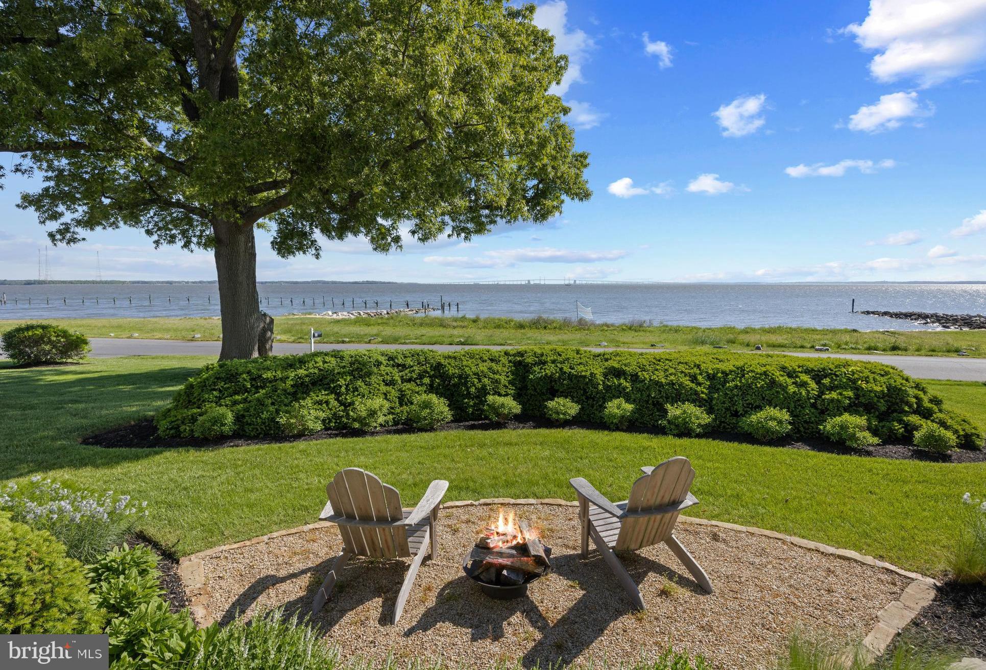 Stylish coastal home in the amenities rich Bay Ridge neighborhood offering breathtaking Chesapeake Bay and Bay Bridge views with a sandy beach just steps from the property. The rear exterior courtyard with lush landscaping is the ideal shady spot for warm summer days or cool nights around the firepit. The welcoming entry immediately captures the tranquil view of the water upon stepping into the home. The thoughtful design includes a beautifully laid out main level featuring a gourmet kitchen perfect for entertaining and gazing at the water while creating a beautiful meal, a cozy living room with fireplace, and a dining area with access to the front porch. Step outside to the inviting stone porch, perfect for relaxing after an activity filled day. Kick your feet up and soak in the captivating Bay activity. At the other end of the porch, a versatile two-story office space, library or den is the ultimate flex space. Begin and end the day from inside or outside of the home while immersed in the surrounding views of the Bay. Completing the main level is a spacious bedroom with a full bath, a mudroom, and a convenient laundry room. An unfinished basement provides ample storage or the potential for additional living space. Upstairs, you'll find two generously sized waterfront bedrooms and one additional bonus room, all served by a stylish hall bath. The expansive attic offers exciting potential for future finishing.  The detached two-car garage has a full bath and extra storage for added convenience. Beach access right at your doorstep invites you to enjoy the sandy beach and the tranquil waterfront lifestyle. The Bay Ridge community offers an array of amenities, including a waterfront pool and clubhouse, beaches on both the Bay and the River, a marina with a newly renovated clubhouse, sports courts, playgrounds, and year-round social events. Just minutes from downtown Annapolis and Eastport, the location also offers quick access to Rt. 50 and 97 for seamless commuting to Baltimore, BWI, Ft. Meade/NSA, Washington, DC, or the Eastern Shore for a weekend getaway. Live the coastal dream in a home designed for both luxury and relaxation. Welcome Home!