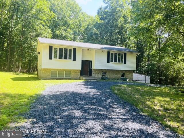 Large 4-bedroom, 2-bath bi-level home with circular driveway, situated on 0.99 wooded acres in Lenape Hills within the Pleasant Valley School District. This light-filled home features an open floor plan, with a primary bedroom offering double closets, a bow window, and a dedicated vanity area. Additional bedrooms are generously sized and provide ample closet space. The spacious lower-level family room features an efficient wood stove for added warmth and comfort, plus a walkout design with sliding glass doors leading directly to the backyard. Additional storage space adds to the home's functionality. Outdoor living is highlight with a 20' x 12' rear deck with built-in seating and peaceful views of the private, tree lined yard. Reasonable Taxes and convenient access to major roadways, shopping, and dining, this move-in-ready home offers comfort, privacy, and value in a great location. Call the listing agent to schedule your showing today.