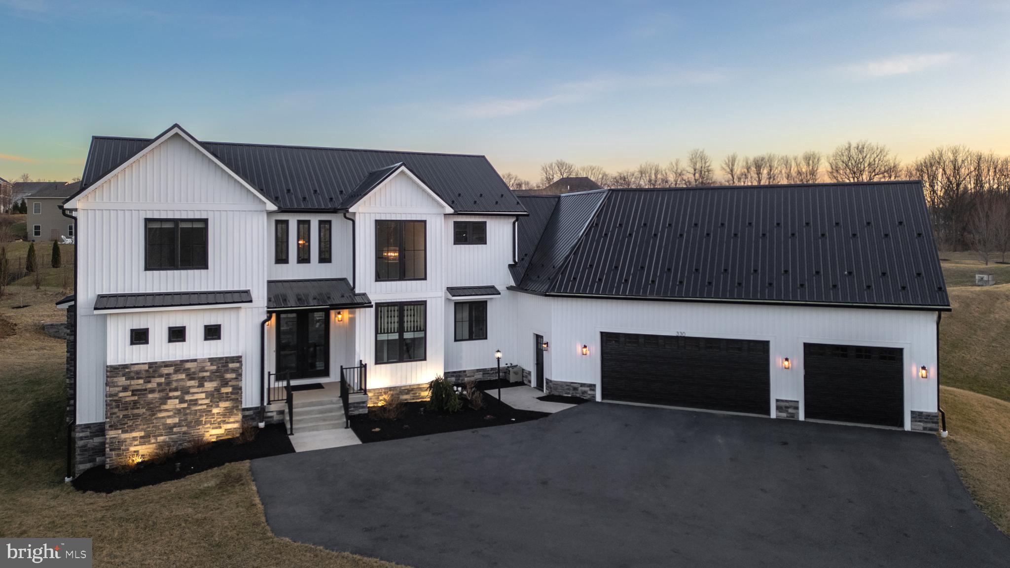 Prepare to be captivated by this breathtaking modern farmhouse design, masterfully crafted by Singular Construction in the highly sought-after Stearns Crossing development. As you step inside, you'll be greeted by a sweeping vaulted ceiling that sets the tone for the expansive, sun-drenched living area, highlighted by an elegant stone-surround gas fireplace that invites warmth and comfort and accentuated with quarter-sawn milled white oak floors that lay throughout. The kitchen is truly a culinary haven, showcasing top-of-the-line stainless steel appliances, luxurious quartz countertops, and an impressive oversized 6-seat island. The centerpiece, a 6-burner gas stove with a striking hood vent, is sure to inspire your inner chef. The open-concept layout is perfect for entertaining, seamlessly connecting the dining area to the covered patio, making it an ideal space for gatherings. Storage is abundant with a convenient walk-in pantry and a well-appointed mudroom just off the kitchen, complete with ample shelving and built-ins that lead into a chic half bath. The first floor also boasts a generous primary suite, exuding tranquility with its spa-like bathroom featuring a sumptuous soaking tub and a walk-in tile shower. However, the pièce de résistance is undoubtedly the expansive closet/dressing room, offering a wealth of storage and a stylish custom island! A thoughtfully designed laundry room adds practicality to the main level.
Ascend to the upper floor, where you'll discover three inviting bedrooms, including one with a private ensuite and two that share a well-designed jack-and-jill bath, each equipped with its own private sink and toilet. A light-filled walkway guides you to a separate living area, featuring its own staircase from the garage — a perfect setup for an in-law suite or a productive home office. Completing this beneficial space is a fourth bedroom, a full bath, and a convenient kitchenette.

The lower level remains a blank canvas for you to personalize with ample square footage waiting to be finished. It's pre-plumbed for a bathroom, and is already equipped with a radon mitigation system and water softener. With systematic multi-zone gas heat, a generous 3 car garage with smart epoxy floor and efficient gas water heater, this home was designed with both beauty and functionality in mind. Conveniently located to campus, shopping, highways, and even a class A wild trout stream, this stunner truly has it all!