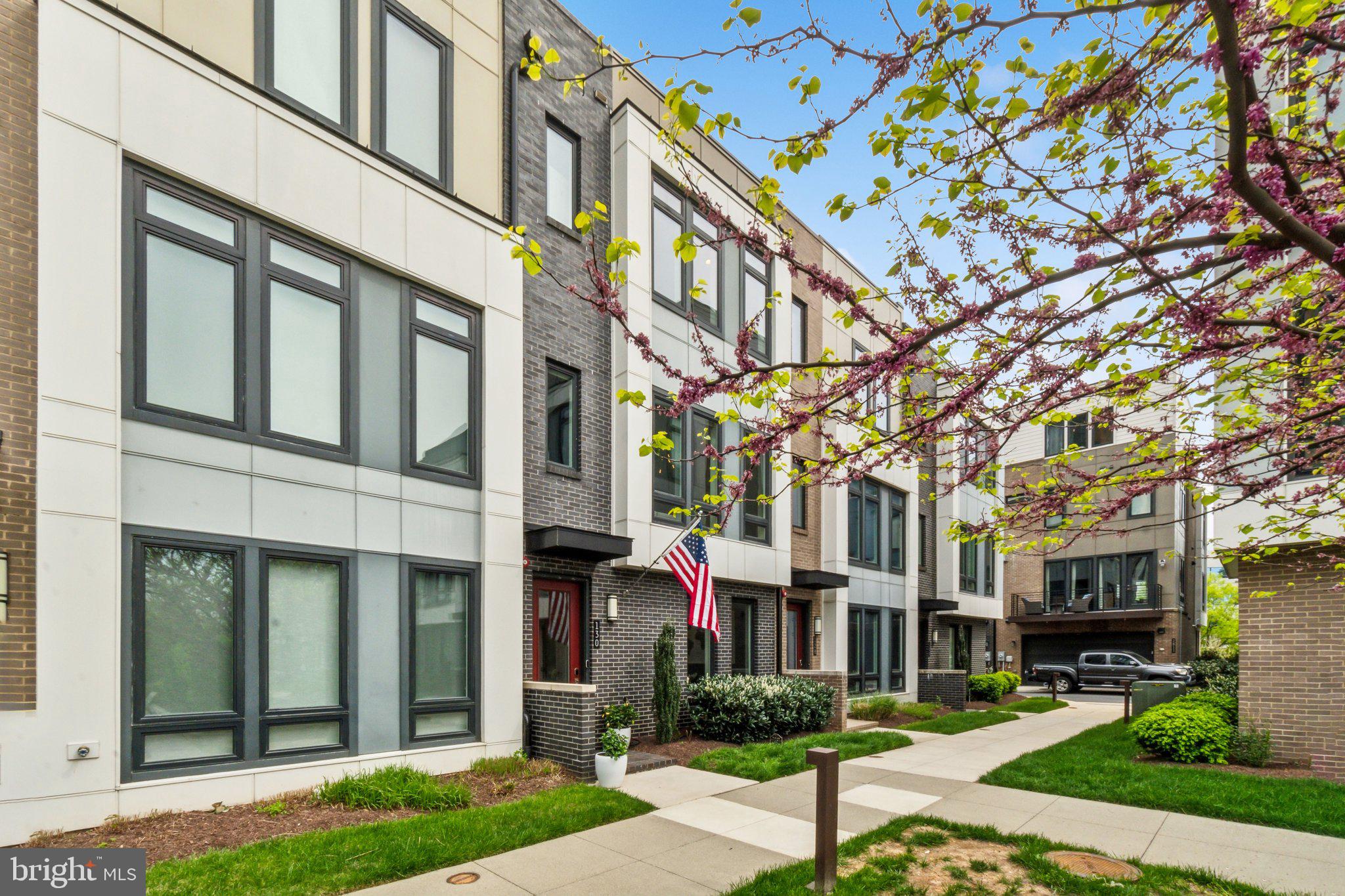 Escape the ordinary & embrace an elevated, harmonious lifestyle at 130 Ike St. Nestled within Eisenhower Square – an exclusive enclave of just 67 contemporary townhomes – this residence offers a rare blend of clean modern lines & warm, natural elements. It balances effortless convenience with a coveted Alexandria address. Imagine overlooking a tranquil landscaped courtyard, yet being mere minutes from the Metro, Old Town's historic charm, National Harbor's buzz, & the heart of D.C.

This isn't just a townhome; it's 2,580 sq ft of meticulously curated living across 4 dynamic levels, designed with an organic modern sensibility. Featuring 4 BRs, 4.5 BHs, a 2-car garage, & the crown jewel – a private rooftop garden terrace & outdoor living room with an unobstructed courtyard view – this home seamlessly blends indoor & outdoor life. With over $150K in thoughtful upgrades, luxury & natural textures are infused in every detail.

Versatile Entry Level: Welcome guests into a foyer defined by a textured, grounding cement accent wall. This level features a spacious BR with a full BH – perfect for guests, a serene home office, gym, or au pair suite. The practical, epoxy-coated 2-car garage includes built-in storage, keeping life organized. Dual-zone HVAC ensures tailored comfort year-round.

Spectacular Main Level: Prepare to be impressed by the light-filled volume! Soaring 10-ft ceilings & sun-drenched floor-to-ceiling windows flood the space with natural light. Warm, hand-scraped hardwood floors provide beautiful natural texture underfoot, contrasting elegantly with the chic, clean lines of the floating staircases. Relax by the modern cement fireplace, a minimalist focal point adding textural interest, or step onto the private balcony for morning coffee amidst the fresh air.

Gourmet Chef's Kitchen: A culinary space where form meets function. It features sleek modern cabinetry (soft-close) balanced by the natural stone-look of quartz countertops & a timeless subway tile backsplash. Premium GE Café appliances (including a 6-burner gas range!) offer pro-level performance. The large island invites connection with seating for four, while stunning RH designer lighting adds a touch of sophisticated warmth. A pantry ensures ample storage.

Elegant Dining: Host memorable dinners for up to 10 guests in the spacious dining area overlooking the courtyard. It's highlighted by a wraparound feature wall adding depth, & another exquisite RH chandelier. A stylish powder room adds flair.

Restful Upper Level: Retreat to your luxurious primary suite – a serene haven bathed in light. Features include a custom walk-in closet for two & sophisticated finishes like a chic wood accent wall bringing natural warmth & texture, complemented by designer wallpaper. The spa-like ensuite BH boasts dual quartz vanities & a large, floor-to-ceiling tiled shower, creating a calming, natural palette. An additional ensuite BR with a full BH & a convenient laundry room complete this restful level.

Penthouse Level & Rooftop Oasis: The top floor is an entertainer's delight, extending the home's connection to the outdoors. Discover a 4th BR with full BH (ideal guest retreat!), a bright loft with built-in bench, & a wet bar with beverage fridge. Then, the pièce de résistance: retractable glass doors seamlessly blur the lines between indoors & out, opening to your private rooftop terrace & outdoor living room with  unobstructed main courtyard view. Featuring upgraded flooring with a natural feel & an automated full-terrace retractable awning, this serene escape is perfect for sunset cocktails, alfresco dining surrounded by potential greenery, or stargazing in comfort all-year-round.

In moments you’re at:

Dining: Sweet Fire Donna’s, Whiskey & Oyster, Tequila & Taco 

Parks: Cameron Run, Dog Run Park, GW Parkway Trail, Great Waves Waterpark

Breweries: Port City Brewing, Aslin Beer Co., Atlas

Groceries: Whole Foods, Trader Joe’s, Wegmans, Harris Teeter