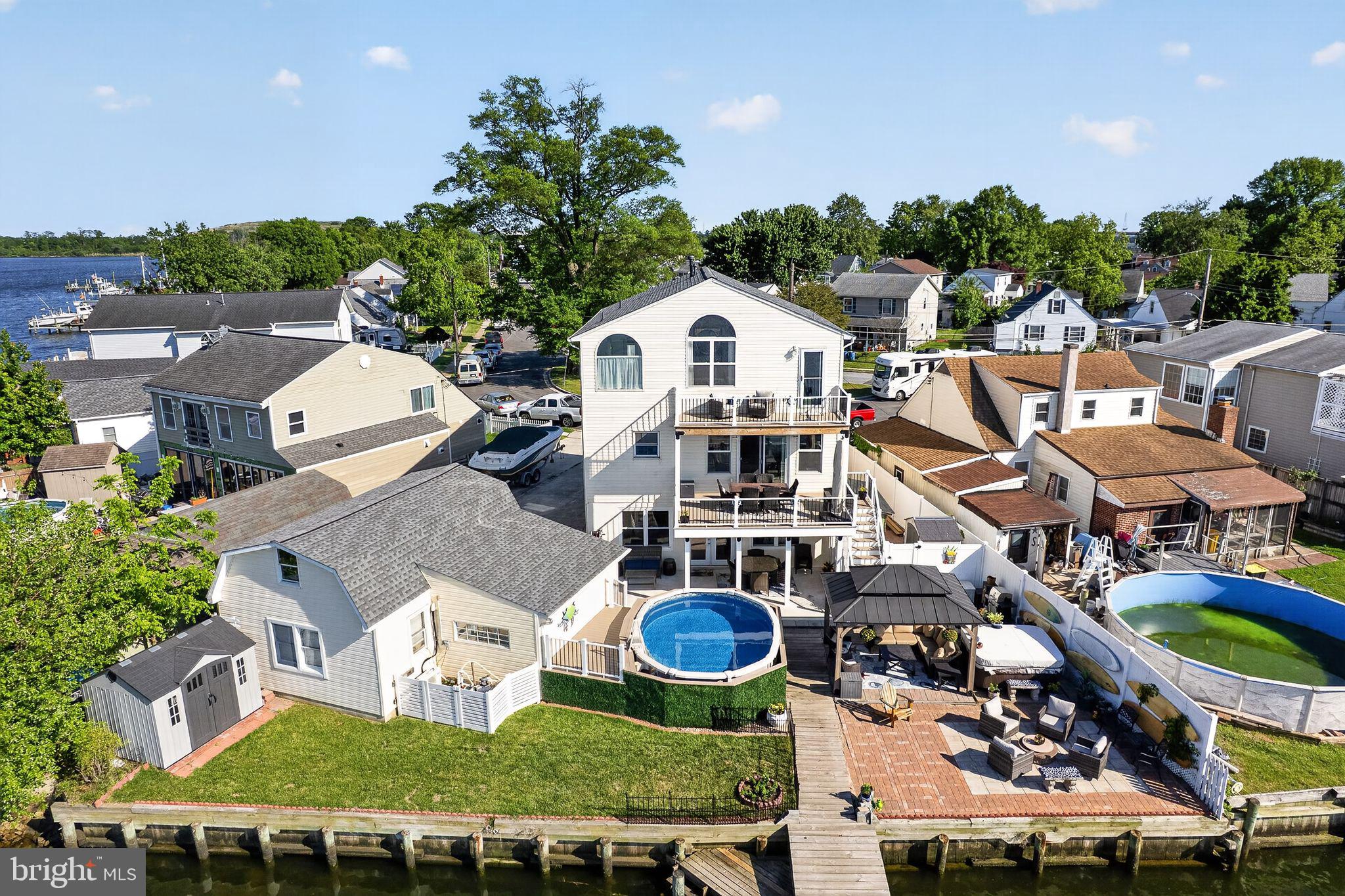 Welcome to 8224 Northview Road — a stunning 3-level waterfront retreat thoughtfully designed for luxury living, entertaining, and everyday comfort. Perfectly positioned along the water with breathtaking views, this exceptional property combines high-end upgrades, versatile living spaces, and incredible outdoor amenities.

The heart of the home is the expansive gourmet kitchen featuring stainless steel appliances, three ovens, a gas range with double oven, separate wall oven, microwave drawer, warming drawer, dual-basin farmhouse sink, Instahot system, trash compactor, wine cooler, and an oversized pantry complete with an additional refrigerator and freezer. The open-concept layout flows seamlessly into the main living and dining areas, creating the perfect space for gatherings while maximizing waterfront views.

Hardwood flooring spans the main and upper levels, while the finished walkout lower level offers durable luxury vinyl plank flooring throughout. The main floor also includes a private office and convenient half bath.

Upstairs, the spacious primary suite is a true waterfront sanctuary featuring vaulted ceilings, ceiling fan, oversized walk-in closet, and a private balcony/deck overlooking the water. The luxurious primary bath includes a dual vanity, jetted soaking tub, and separate shower. An additional full bath offers another dual vanity, jetted tub, and steam room for spa-like relaxation.

The fully finished walkout ground level is ideal for entertaining or multi-generational living with a complete second kitchen featuring a stove, oven, dishwasher, refrigerator, bar area, beer cooler, full bath, and laundry area.

Outdoor living is just as impressive with a covered porch, brand-new Trex decking, extensive paver hardscaping, gazebo, above-ground pool with Trex surround, and multiple waterfront entertaining areas. Boating enthusiasts will love the three boat lifts and premium waterfront setup.

Additional upgrades include a powerful 440-amp electrical service, detached garage with finished bonus room, and countless custom features throughout.

This rare waterfront opportunity offers the perfect blend of luxury, functionality, and resort-style living — all in an incredible location.