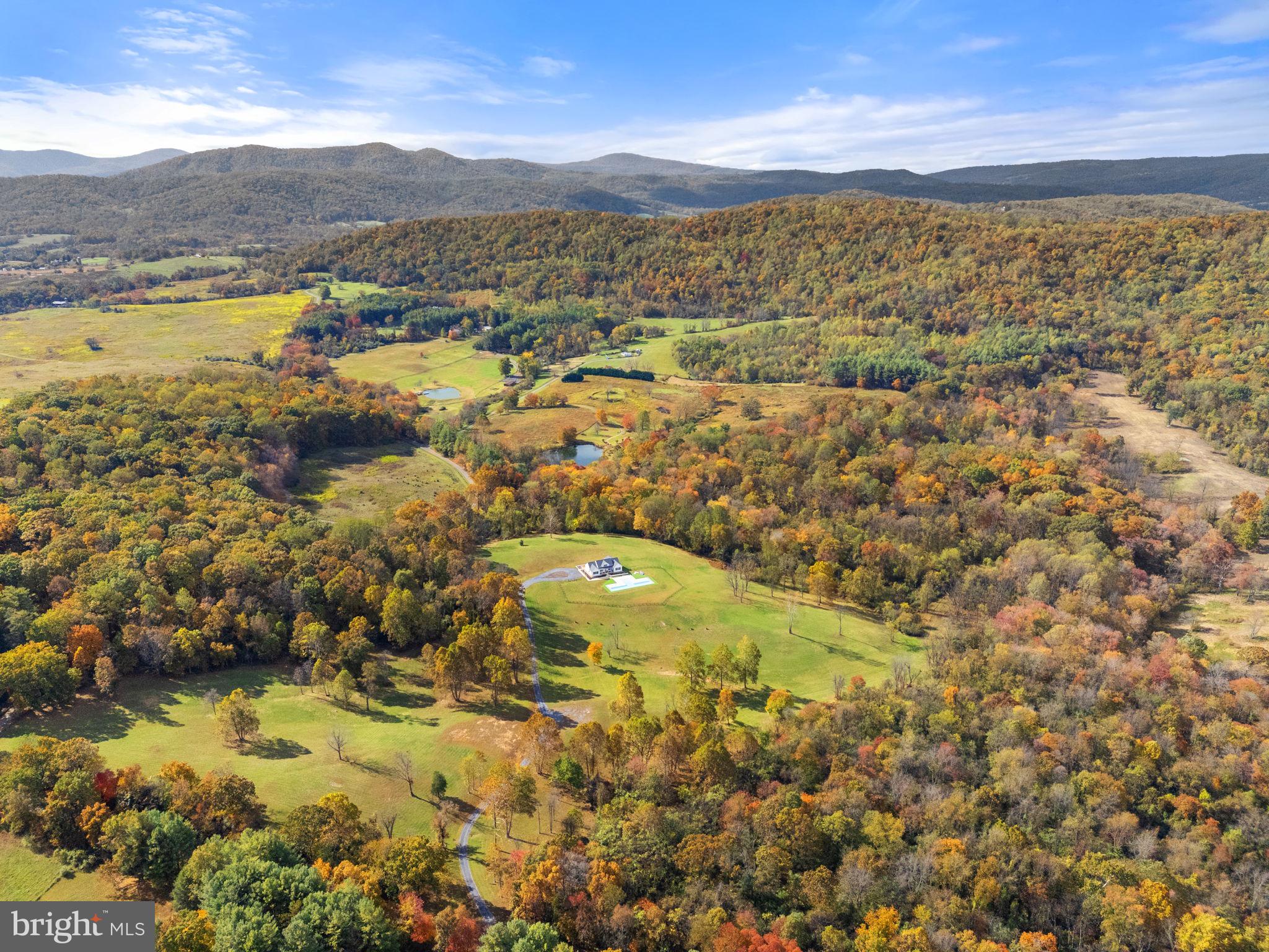 Discover Pohick’s Corner — a stunning 96-acre country retreat in the heart of Virginia’s horse and wine country, just one hour from Washington, D.C. Set amid rolling hills and preserved landscapes, this exceptional property offers both serenity and opportunity.

Protected by a Fauquier County conservation easement, Pohick’s Corner and its neighboring property will forever maintain their breathtaking views and rural charm. The easement allows for the construction of an additional 6,000 sq. ft. home and multiple outbuildings — imagine your dream estate with space for a garage, barn, sheds, or pool house — all while enjoying the existing cozy cottage pool house and low taxes.

Built in 2023, the four-bedroom home combines comfort, accessibility, and craftsmanship. Designed for one-level living, it features ramps, wide doorways, and open spaces ideal for easy movement. Inside, you’ll find vaulted and 9ft ceilings, hardwood floors throughout, and marble floors in the kitchen, half bath, and laundry room. A constant-pressure, variable-speed pump delivers water from the 100-gallon-per-minute well, and the five-bedroom septic system allows for future expansion. Step outside to the two-lane lap pool with a zero-entry ramp, perfect for relaxing or daily exercise.

The land itself is a rare find — 96 acres of rich, diverse soils, ideal for pasture, grazing, or crops, bordered by two creeks and containing a natural spring.

Whether you’re looking to create a private compound, a luxury farm retreat, or simply enjoy country living with modern comfort, Pohick’s Corner offers it all — unmatched privacy, natural beauty, and endless potential.
