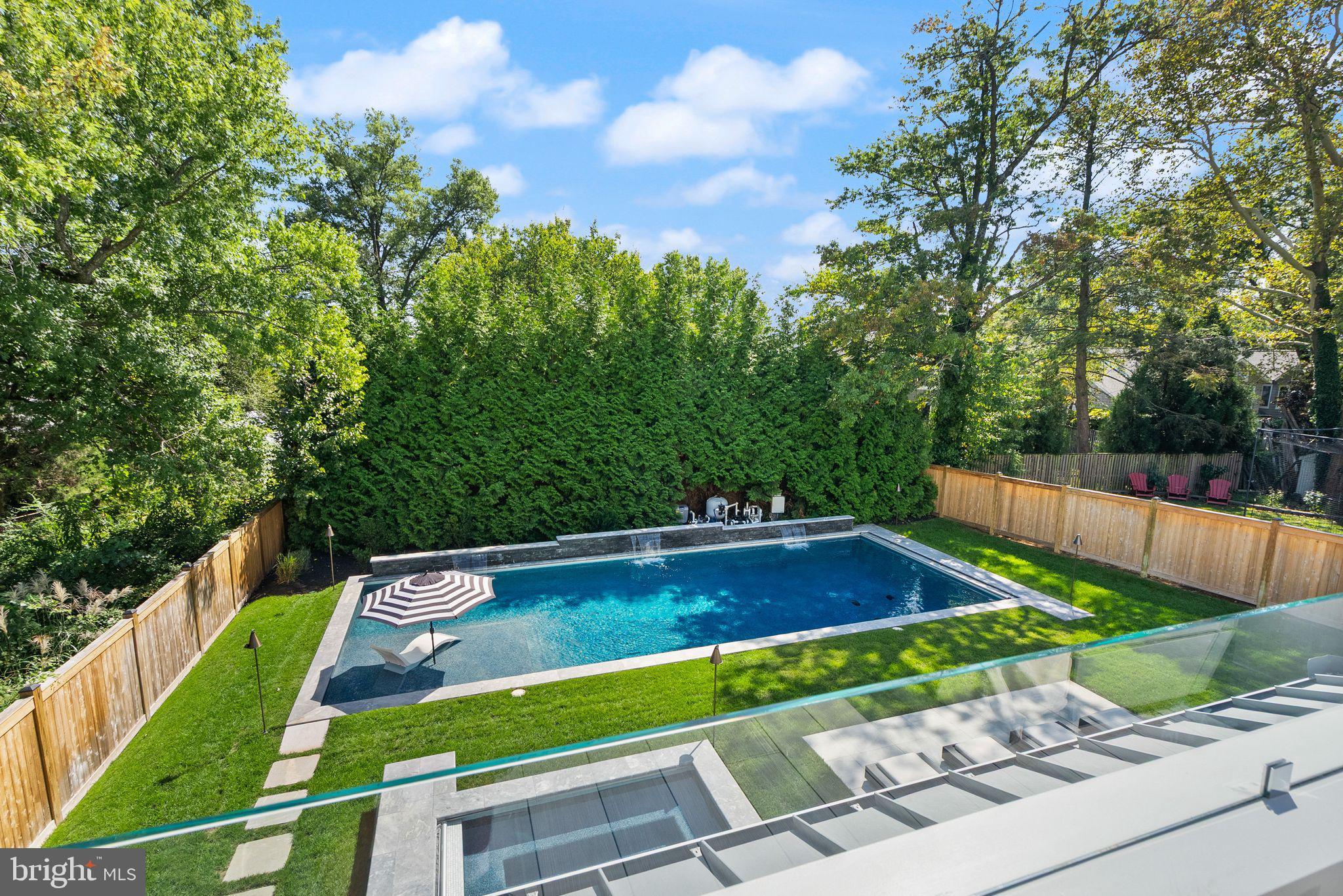 Experience elevated resort-style living in this exceptional modern farmhouse, ideally situated in the coveted Berkshire Oakwood neighborhood of North Arlington. Designed for both grand entertaining and everyday luxury, this home seamlessly blends refined interiors with an extraordinary outdoor retreat.
At the heart of the home, the chef’s kitchen is nothing short of spectacular—thoughtfully designed with an expansive island and oversized peninsula offering seating for eight. Outfitted with top-tier appliances, including a Wolf 60” six-burner range, Sub-Zero 48” refrigerator/freezer, Wolf 30” column wine storage, and a built-in Wolf espresso machine, this space delivers both performance and sophistication in equal measure.
The dramatic great room features soaring ceilings and accordion doors that fully open to create a seamless indoor-outdoor connection—leading directly to one of the most impressive backyard environments in the area.
Step outside to your private oasis: a resort-caliber outdoor living experience anchored by a stunning 20x50 pool by renowned builder Lewis Aquatech, complete with a PebbleTec Brilliance finish, saltwater system, and automatic cover. A built-in 10x10 spa mirrors the same luxurious finishes, while digitally controlled water features and ambient lighting elevate the entire setting. The covered patio is perfectly appointed with a SunBrite TV, Restoration Hardware fire table, and ample space to relax or entertain.
The fully equipped outdoor kitchen is a true showpiece, featuring sleek Dekton countertops and premium Lynx appliances, including a 42” grill with rotisserie and a 30” Napoli pizza oven—ideal for hosting unforgettable gatherings.
Additional highlights include brand new Avignon wide plank hardwood flooring, curated Restoration Hardware lighting, a private sauna in the exercise room, and lush, mature landscaping for ultimate privacy, complemented by a 6’ cedar fence and full irrigation system.
All of this, just moments from Nottingham Elementary, Chestnut Hills Park, Harrison Shopping Center, Yorktown High School, and the East Falls Church Metro—offering the perfect balance of luxury, lifestyle, and location.