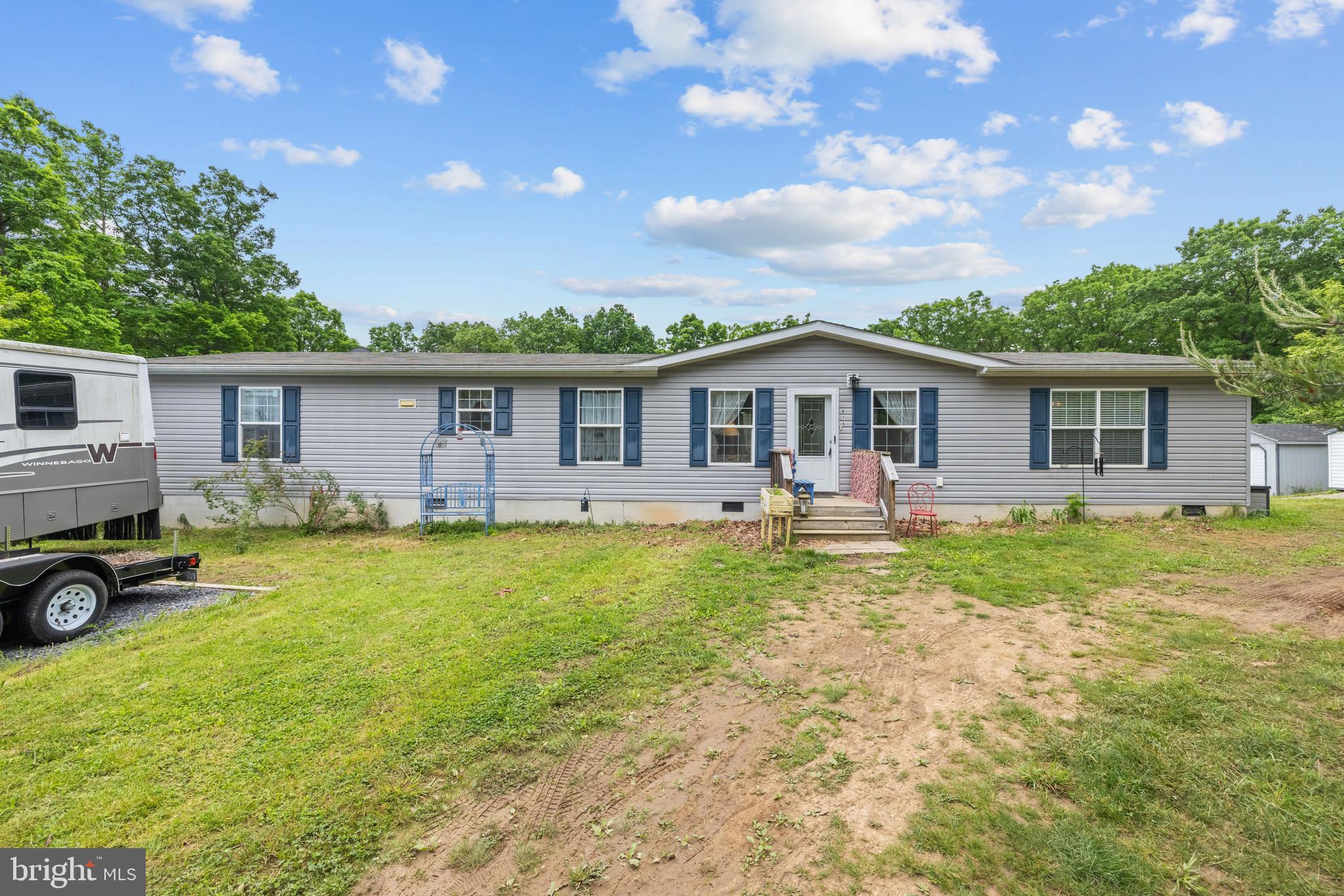 Serenity found in this lovely 4 bedroom 2 bath on just over 2 acres at the end of the road.      This 2018 Clayton Home is on a permanent foundation boasting  all the home features of a stick built home. The large living room features a sliding glass door that open up to a deck (awaiting completion).   Ample counter and cabinet space  in the kitchen, large island, and  room for a cozy kitchen table. Enjoy a lovely ensuite bath  and walk-in closet in the primary bedroom. The other three bedrooms are thoughtfully positioned at the opposite end of the home, sharing a full bath.    Laundry room has exterior door onto a large deck.  Two sheds give you lots of room for storage of yard or garden equipment.  Large open back yard with fenced in garden area that needs your loving touch to bring it back to live.  Lovely trellis overflowing with wisteria.   Wildlife seen frequently crossing the yard.  Home is being sold AS-IS. RV does not convey.  If someone desires more acreage, there is a 5.24 acre lot for sale (WVHS2003830) to the left of the house, listed by Mountain State Properties of WV.