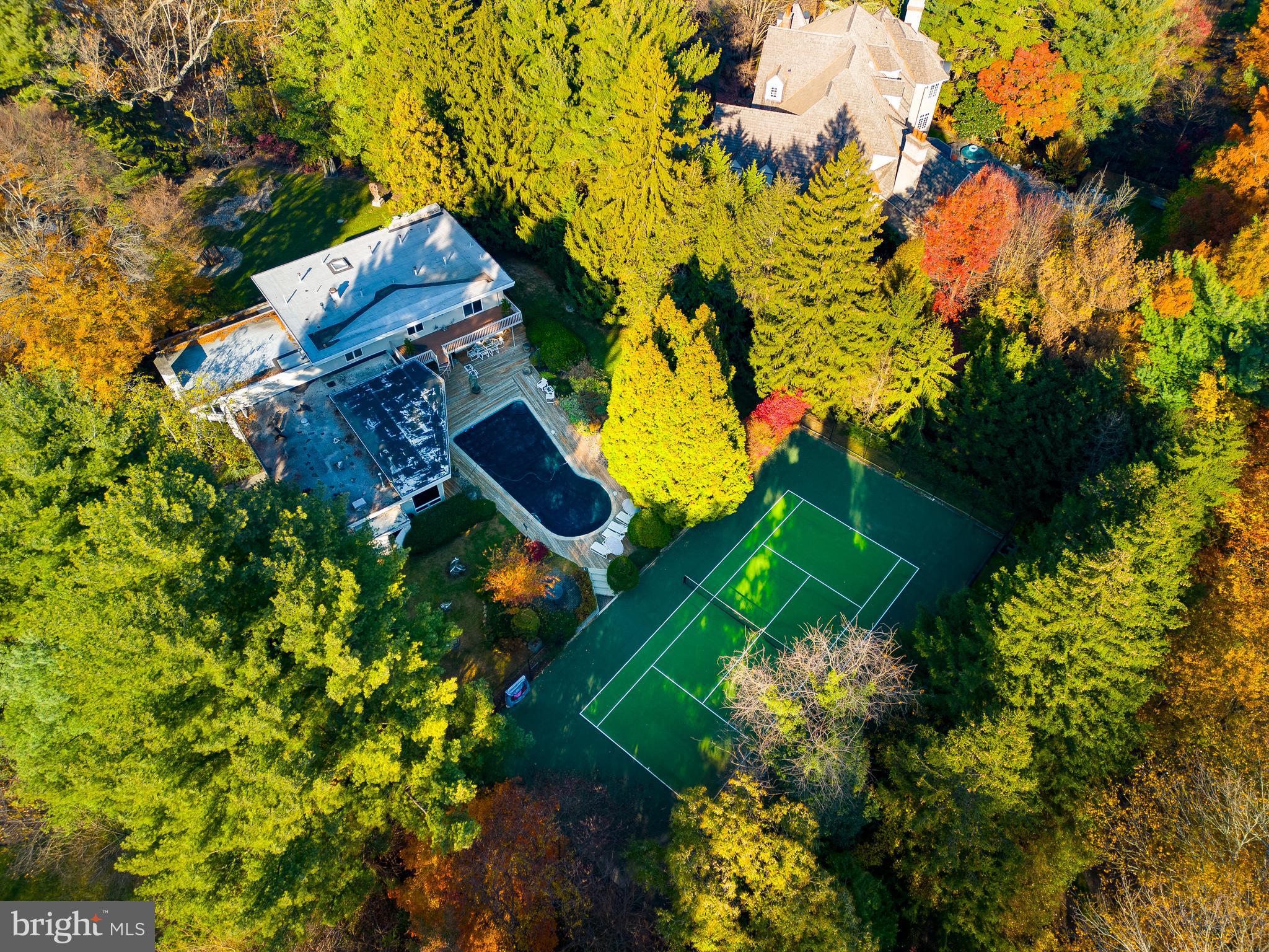 Property is back on the market after Buyer's financial situation changed.  Discover an exceptional Main Line residence unlike any other in this stunning indoor-outdoor 4BD/3.5BA midcentury showplace featuring a tennis court, pool and 1.18 acres of park-like grounds by a well-known landscape architect. Inside the 5,276SF residence, enjoy a sprawling layout filled with walls of windows, hardwood floors and three fireplaces. The sunken great room leads to a formal dining room, a gourmet eat-in kitchen and a sun-splashed family room. The dramatic double-height library is joined by a separate private study. Above, the luxurious owner's suite boasts a spa bath, attached gym/nursery, sauna and two balconies. Three secondary bedrooms, two baths, a powder room and a full-height lower level complete the layout. Outside, enjoy a large wood deck with BBQ surrounding the sparkling pool or perfect your serve on the tennis court that was resurfaced about a year ago.  A gated drive, motor court and three-car garage add plenty of parking to this secluded sanctuary close to the best Main Line and Center City amenities.