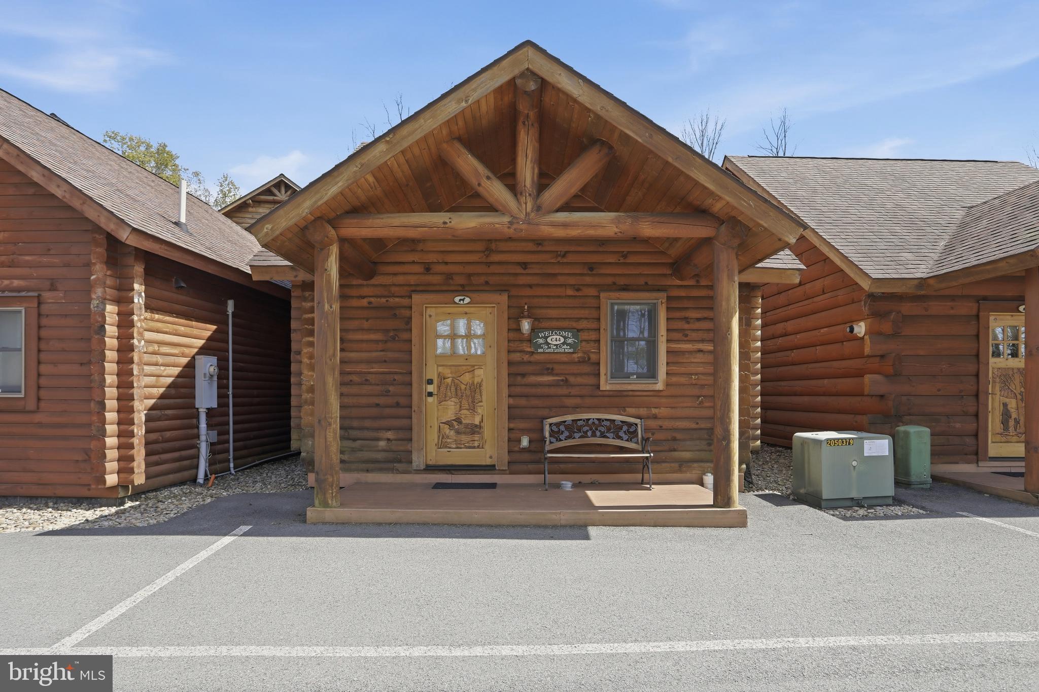 BOAT SLIPS! LAKE ACCESS & VIEWS! 4TH OF JULY FIREWORKS VIEWS! SKI SLOPE VIEWS!  Cabin #44 at The Lodges of Sunset Village is a detached efficiency unit with a living room area with a sleeper sofa, king bed, a full bath, a kitchenette, and approximately 576 square feet, fully furnished and turnkey. This unit has a porch and patio too!

Rich in mountain character and charm, this log cabin features uniquely carved wooden doors, beautiful beamed ceilings, warm wood walls, and inviting spaces that create an authentic lake-and-mountain retreat feel. Additional features include lake and ski slope views, expansive decks, upgraded finishes, open-concept living, a stacked-stone gas fireplace. Enjoy incredible views of Deep Creek Lake and Wisp, along with front row seats for seasonal beauty and memorable moments, including views of the annual July 4th fireworks. 

This property has a proven rental history, generating an average of  $38,590  in annual gross
rental income creating an exciting opportunity for
buyers seeking both personal enjoyment and investment potential. Experience one of Deep Creek Lake’s
newest ownership opportunities at The Lodges at Sunset Village. For the first time ever, fully furnished lake
area cabins are being offered for individual ownership in a breathtaking community featuring incredible lake
and Wisp ski slope views. Community amenities include lake access with 10 shared dock slips and an
impressive 1,320 square foot waterfront dock area perfect for fishing, swimming, launching kayaks,
relaxing by the water, and enjoying summer fun at the lake. Residents and guests also enjoy a lakeside
gazebo, playground, fire pit, gathering areas, pet-friendly accommodations, abundant parking, and on-site
professional management. The monthly condo fee provides exceptional convenience, including most
utilities, snow removal, trash service, and yard maintenance, for a low-maintenance ownership experience. Whether you're searching for a vacation retreat, income-producing investment, or both, The Lodges at
Sunset Village offers a rare opportunity to own at Deep Creek Lake. Owner financing options may be
available.