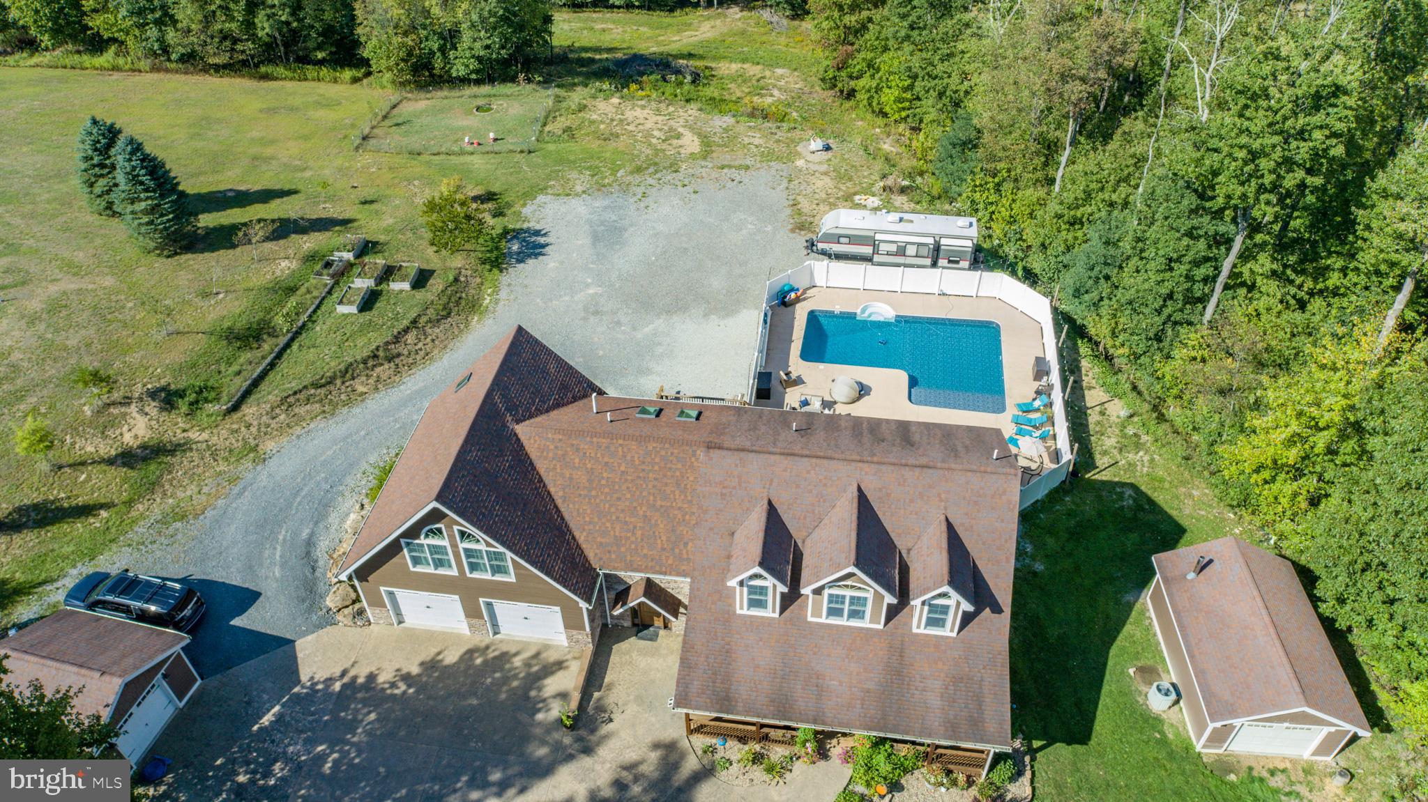 Welcome to a private retreat on 4 acres with sweeping views and a large front yard, just minutes from Deep Creek Lake and Oakland. This 4-bedroom, 4.5-bath home has been carefully updated to balance comfort, practicality, and modern style.

The main level features hardwood floors, radiant heat for added comfort, and open gathering spaces with quiet nooks for reading or hobbies. Upstairs, two primary bedrooms with private baths provide flexibility for family or guests. The full apartment-style basement includes its own kitchen, laundry, and heated floors, offering an inviting space for extended stays or independent living.

Outdoors, a stamped concrete driveway leads to an oversized two-car garage, with additional garages and sheds for storage or projects. A fenced in-ground pool, hot tub, and wood decking create a welcoming space for entertaining and relaxation.

With thoughtful upgrades throughout, extensive amenities, and close proximity to both town and lake, this property offers the best of convenience and privacy in one setting.