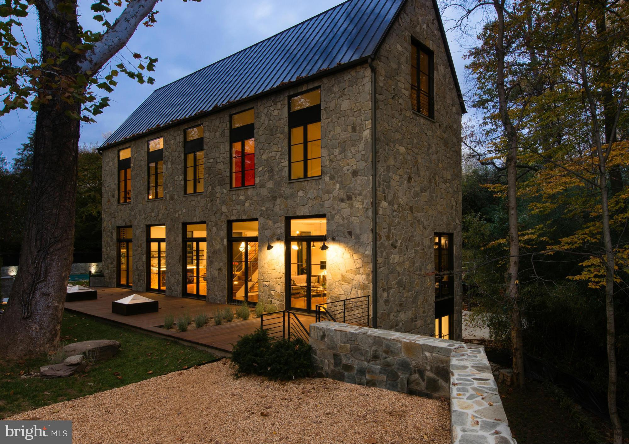 Stunning, sophisticated 5,500SF home built by owner/architect Carmel Greer in 2014 - Open & airy w/soaring spaces, exposed beams. Main lvl great rm w/open living/dining/kitchen, 5 sets of glass doors + 11' ceilings, handsome office. 4BR/2BA on 2nd lvl, master ste spans entire top flr w/treetop views + 12' peaked ceilings. Finished LL w/fam rm, BR + skylit in-law suite; Saltwater pool. Shared drive