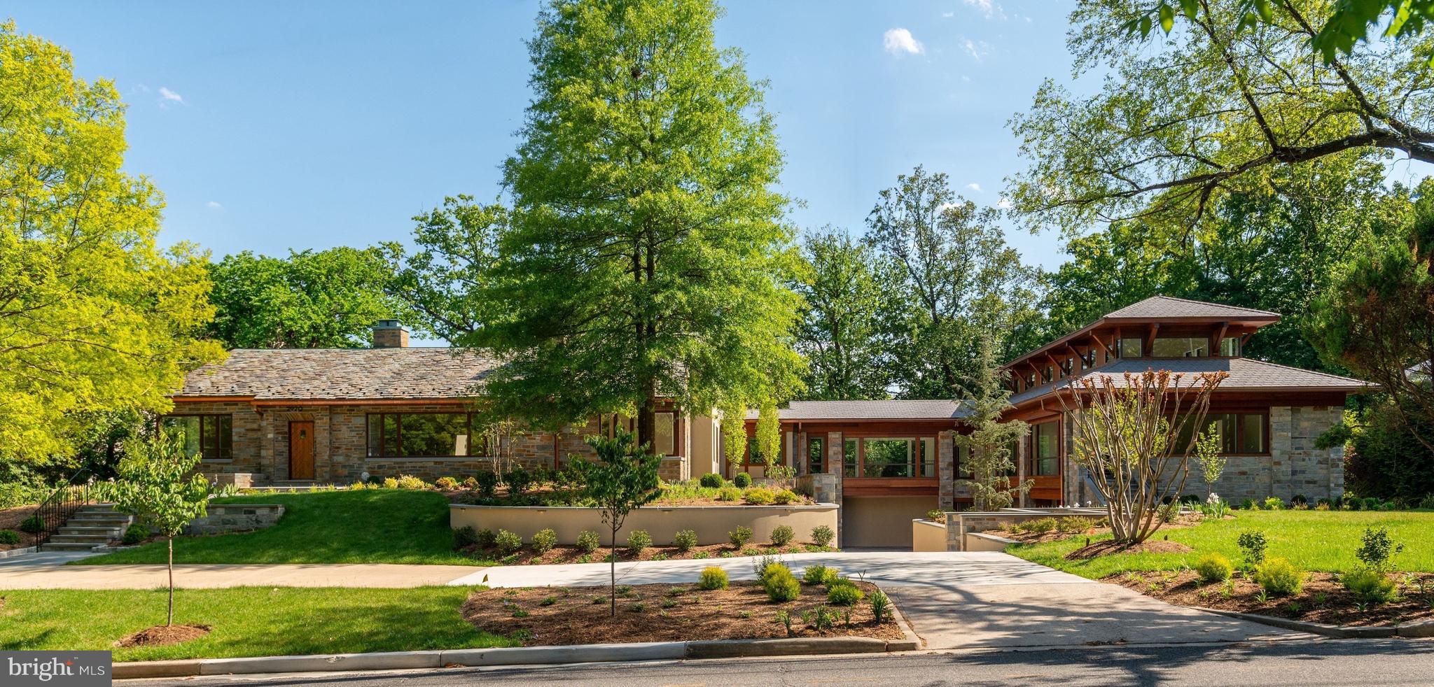 Exceptional opportunity! This is a must see, unique one-of-a-kind custom designed property! Homes with this acreage are rarely available in DC. It is the owner's childhood home that has been expanded with a sleek new wing, blending timeless craftsmanship with stunning contemporary design and high-end finishes and amenities. It encompasses approximately 9,300 square feet of versatile livable space plus a 950 sq. ft. attached 3-car garage. An elevator from the garage leads to the Main Level of the new addition. 

Prominently sited on a combined .83 acre lot in DC's elite Forest Hills, this home features striking walls of glass flooding the spaces with light and providing lovely views of the grounds. Over 4,000 trees and plantings have been added to the landscape. An expansive backyard offers a couple of stone patios and the original Carderock stone Barbecue with wood-fired oven, grill and pizza oven for entertaining and relaxing in a serene, private setting. 

This impressive 6 Bedroom, 5 full and 2 half Bath property has 3 levels. The Main Level of the original stone house celebrates its heritage with meticulously maintained and enhanced architectural features and amenities. It offers ideal circular flow for easy living and entertaining. The Living Room opens to the Great Room with a soaring ceiling and balcony overlook. A wall of glass frames the lush garden beyond, paired with a door to the flagstone terrace. The original Dining Room adjoins a well-appointed Kitchen addition. There is also a Main Level Study and spacious Master Bedroom Suite. Two Bedrooms and a hall Bath are on the Second Floor. An additional above-grade Bedroom and en suite Bath is in the Lower Level. 

A bonus Sitting Room opens to the glass enclosed Breezeway connecting the 2 wings. The new wing showcases exceptional design and modern craftsmanship. There is a large Sunroom with adjoining space plumbed for a wet bar, a sumptuous Master Bedroom Suite, an expansive top floor Gallery retreat, a second Bedroom and en suite Bath, Laundry, Elevator, and a heated 3-car Garage opening to a paved motor court with additional parking.

This unique home has been meticulously cared for and thoughtfully expanded. Flexible multi­use spaces allow one to adjust for personal needs. This unparalleled property presents a rare opportunity in our marketplace.