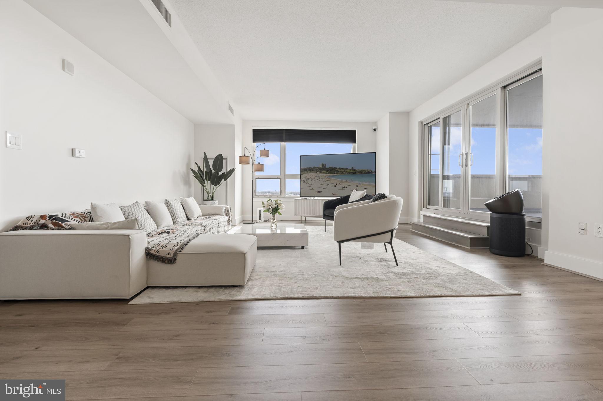 Welcome to The Residences at Dockside—this expansive 3-bedroom, 2.5-bath home offers over 1,900 sq ft of beautifully updated living space with stunning Delaware River and Center City skyline views. Featuring an open-concept layout, wide-plank flooring, oversized windows, and a sleek updated kitchen with stainless steel appliances and stone finishes, this home is designed for both comfort and entertaining. The spacious primary suite features a private balcony and renovated ensuite bath, while two additional bedrooms offer comfortable space ideal for family living. Enjoy a private terrace, in-unit laundry, and assigned parking. Most furniture is included, offering a move-in ready opportunity. Residents enjoy resort-style amenities including 24/7 concierge, gated parking, fitness center, hot tub, clubroom, and a large riverfront patio. Ideally located steps from Spruce Street Harbor Park, Blue Cross RiverRink, top restaurants, and with easy access to I-95, bridges, and the airport—this is waterfront city living at its best.
