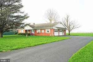 Upcoming Auction June 4th 2026 @ 6pm. Well-Maintained Brick Two (2) Bedroom Two (2) Bath Ranch Style House with Attached Oversized Two (2) Car Garage on a Level 0.34 Acre on Rural Lot.
REAL ESTATE DETAILS:
MAIN FLOOR:
Kitchen (12’8″ x 14′) – Forty (40) Handle Built-In Cabinets, Lazy Susan, Desk Area, G.E. Two (2) Door Refrigerator, G.E. Stove, Garbage Disposal, Wallpaper Walls, Wall To Wall Carpet
Living room (13′ x 21′) – Picture Window, Wallpaper Walls, Wall To Wall Carpet, Guest Closet (2′ x 4′)
Common Area (5’9″ x 7’5″) – Wallpaper Walls, Wall To Wall Carpet, Two (2) Closets (2′ x 2′)
Bedroom #1 (11′ x 13’6″) – Wallpaper Walls, Wall To Wall Carpet, Two (2) Double Door Closets (2′ x 5′)
Bathroom #1 (7’6″ x 10′)– Vanity & Sink, Built-In Cabinets, Toilet, Tile Surround Tub, Tile & Wallpaper Walls, Wall To Wall Carpet, Linen Closet (2′ x 3′)
Bedroom #2 (11′ x 13’6″) – Wallpaper Walls, Wall To Wall Carpet, Double Door Closet (2’x 6′)
Bathroom #2 (6′ x 6’6″) – Vanity & Sink, Toilet, Walker-In Shower, Tile & Wallpaper Walls, Wall To Wall Carpet
Laundry Area (9’6″ x 12’6″) – Washer & Dryer Hook-Up, G.E. Washer & Dryer, Built-In Cabinets, Wallpaper Walls, Wall To Wall Carpet, Closet Area w/ Shelving (3′ x 10′), Access To Three (3) Season Room
Finished Three (3) Season Room (11’6″ x 19′) – Vinyl Ceiling, Sliding Glass Windows, Service Door, Rustic Board Walls, Wall To Wall Carpet
UNFINISHED BASEMENT (26′ X 37′):
Crawl Space Area
Two (2) Sump Pump Pits w/ Sump Pumps
Propane Wall Heater
200 Amp Electrical Service
Electrical Outlets Throughout
FINISHED OVERSIZED TWO (2) CAR GARAGE (27′ X 30′):
Knotty Pine Tongue & Grove Throughout
Service Door
Two (2) Electric Door Openers
Heated Workshop Area
Wall Heater
Window Air Conditioner
Pull-Down Stairs To Attic
OTHER REAL ESTATE DETAILS:
Built 1971
1,164 Square Feet
Lot Size: 0.34 Acres
Plaster Walls Throughout
Rheem Air-Handler Forced Hot Air Heat w/ Central Air Conditioning 
Rheem Electric Hot Water Heater
Rheem Electric 50-Gallon Water Heater
Well Water w/ Pressurized System 
Public Sewer
Concrete Walkway
Cornice, Soffit, & Aluminum Spouting
Asphalt Shingle Roof
Storm Doors
Vinyl Replacement Windows
Front Porch (7’6″ x 20′) – Vinyl Ceiling, Concrete Pad
Macadam Driveway w/ Turnaround 
Front & Rear Yards
Mature Shade & Shrubbery
