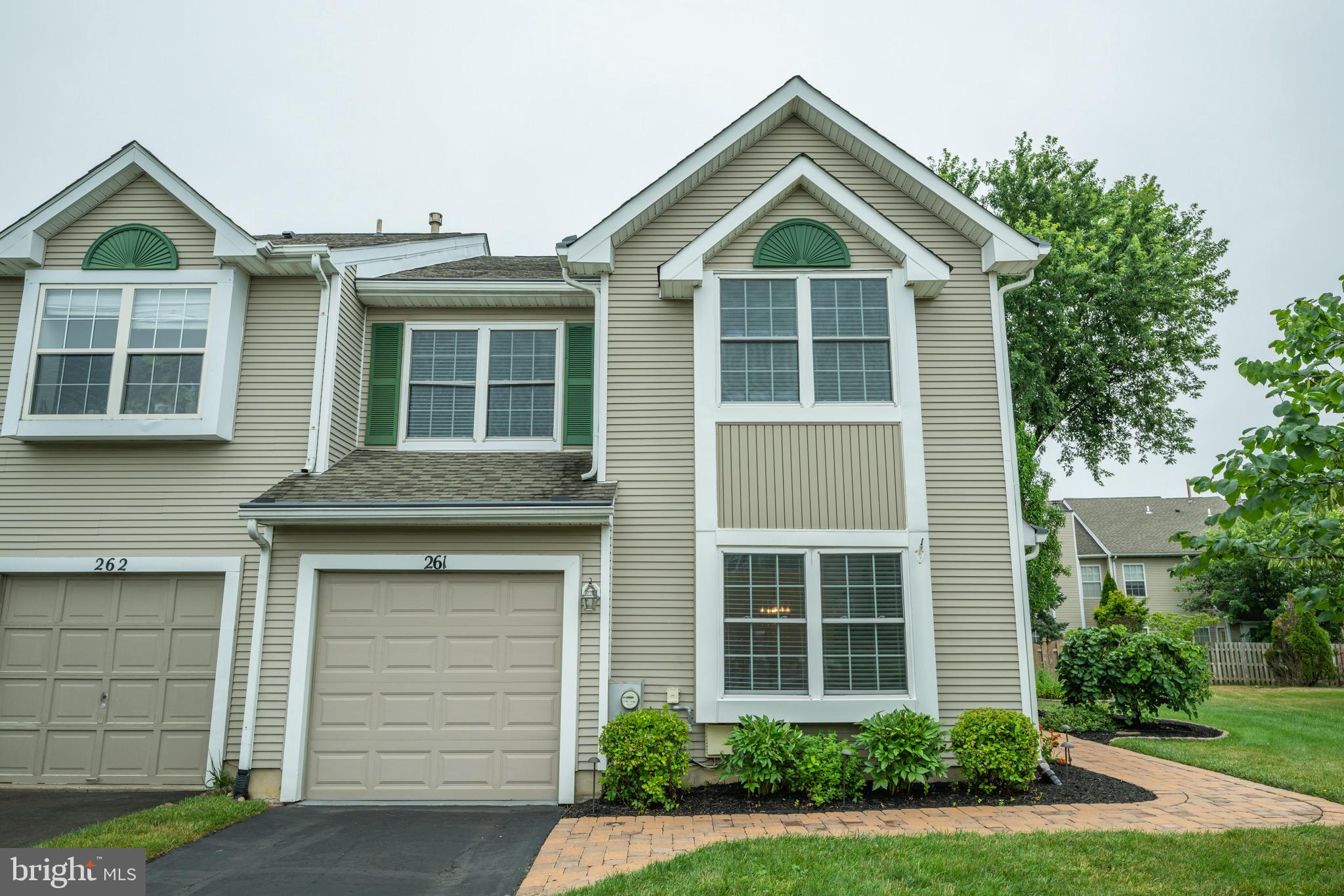 Welcome to 261 Sequoia Drive, an impeccably maintained end-unit townhome in the desirable Heather Wood I section of Newtown Grant. Offering over 2,000 square feet of thoughtfully updated living space, this three-bedroom, two-and-a-half-bath home has been lovingly cared for and beautifully improved, combining timeless style, exceptional functionality, and true pride of ownership. From the moment you arrive, the private side entrance, professional landscaping, updated EP Henry walkway with landscape lighting, and manicured curb appeal set this home apart. The fenced backyard and illuminated hardscape create a private outdoor retreat, complemented by mature hydrangeas, outdoor speaker wiring, and a motion-sensor LED floodlight—perfect for entertaining or enjoying a quiet evening at home. Step inside to discover a bright, welcoming floor plan designed for comfortable everyday living and effortless entertaining. The spacious living room features a bay window, crown molding, chair rail, and surround sound prewiring, flowing seamlessly into the formal dining room before opening to the inviting family room. Here, a wood-burning fireplace with a stone surround, wood mantel, and crown molding creates the perfect gathering space. The fireplace has been professionally repaired and the chimney cleaned, adding peace of mind. At the heart of the home is the beautifully renovated custom eat-in kitchen (2022), featuring granite countertops, rich cherry cabinetry, a tile backsplash, luxury vinyl plank flooring, stainless steel appliances, double oven, under-sink water filtration, illuminated Lazy Susan corner cabinets, and abundant storage. Large windows overlook the beautifully landscaped backyard, bringing natural light into the space throughout the day. The updated powder room showcases hardwood flooring, elegant wainscoting, and upgraded fixtures, while the attached one-car garage is a standout feature with its epoxy-coated floor, painted walls, insulated replacement garage door with newer opener, extensive cabinetry, pegboard organization, motion-sensor lighting, and built-in speakers. Upstairs, the spacious primary suite has been tastefully remodeled with hardwood flooring, custom paint, crown molding, oversized baseboards, ceiling fan, built-in closet organizers, integrated bedroom and bath speakers, and additional blown-in insulation for year-round comfort. The ensuite bath features a double vanity with updated faucets, a Jacuzzi soaking tub, glass-enclosed shower, and refreshed grout. Two additional bedrooms include custom-built loft systems and closet organizers, maximizing both storage and versatility. The refreshed hall bath features updated lighting, hardware, paint, and grout, while the second-floor laundry room offers added cabinetry and shelving. An insulated walk-up attic with built-in shelving, enclosed hanging storage, and a new attic fan provides exceptional storage space. This home has been meticulously maintained with extensive mechanical and exterior improvements, including a York HVAC system with air purifier, replacement tilt-in vinyl windows and rear entry doors, roof, gutters and downspouts, Gutter Helmet system, gas water heater, full-view storm door, driveway sealing, backyard fencing, professionally cleaned air ducts, annual dryer vent maintenance, and many additional updates that reflect the extraordinary care invested in this home. Residents of Newtown Grant enjoy exceptional community amenities including a clubhouse, swimming pool with children's pool, pickleball, tennis, basketball and sand volleyball courts, playgrounds, walking trails, open green space, and recreation fields. Ideally located just minutes from historic Newtown Borough, I-295, shopping, dining, and everyday conveniences, and within the award-winning Blue Ribbon Council Rock School District, this exceptional home offers the perfect combination of tasteful updates, meticulous maintenance, outstanding amenities.