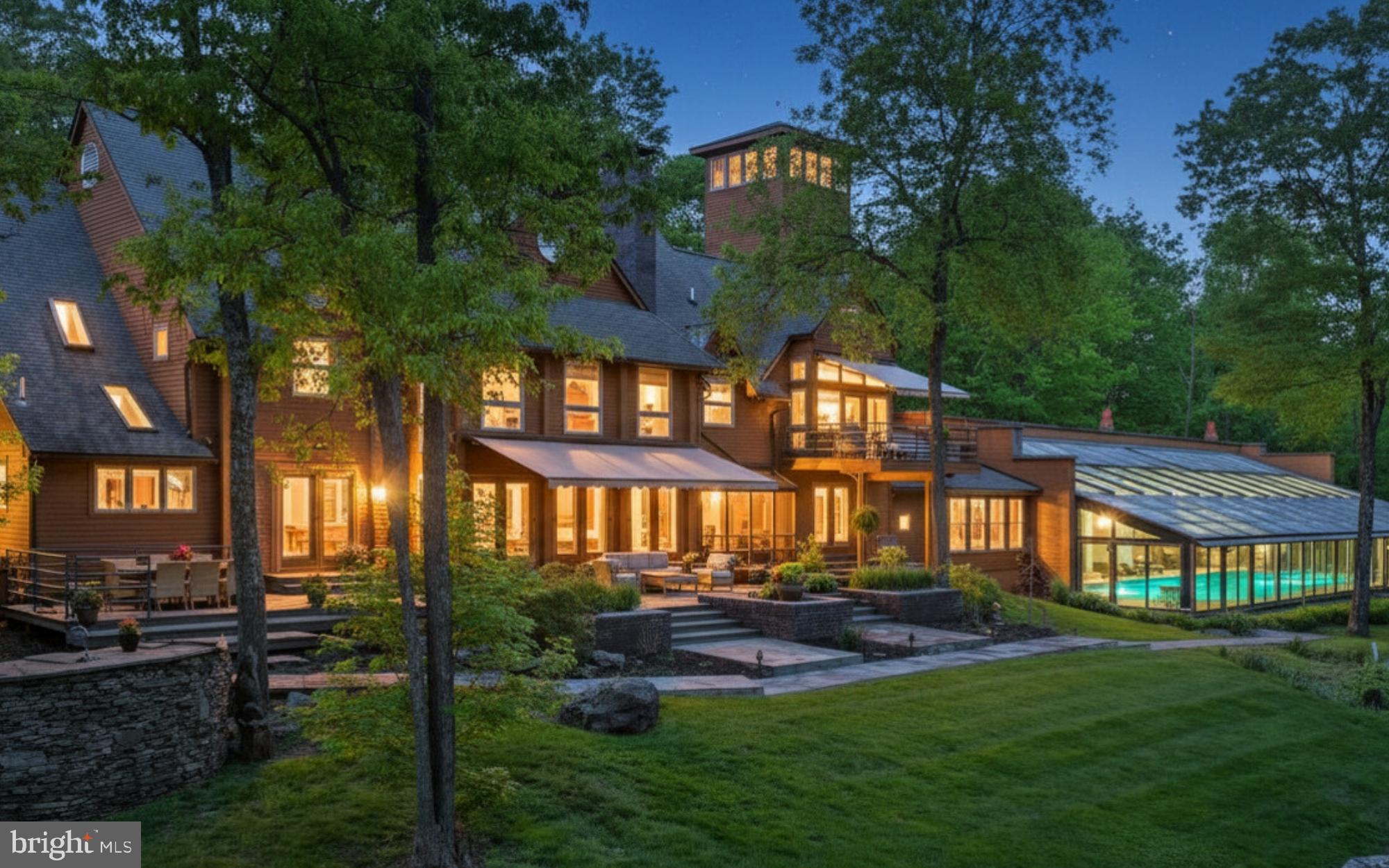 This stunning Pocono Mountains estate incudes an EXQUISITE INDOOR POOL AND FULL SIZE GYM! Indoor amenities abound, making this an ideal year-round retreat centered on 73 acres.
  
Inspired by the beauty and magnitude of its surroundings this remarkable 13,000 SQUARE FOOT residence showcases all the fine materials and craftsmanship of an earlier age coupled with the drama, efficiency and conveniences of modern construction, all finely curated and meticulously maintained. Rare and unusual design elements welcome you to the lodge with an open dining room that will amply accommodate large gatherings and is appointed with Ironwood trees, natural flagstone floor and wall of windows. The voluminous great room was designed with extreme care to blend its strong architectural character and exceptional detailing into a dramatic and comfortable space punctuated by its cathedral ceiling, floor-to-ceiling brick fireplace, African rosewood floors and walls of windows to embrace the sun in the winter and the sun-dappled views in the summer. A thoughtfully planned kitchen, with high-end appliances and amenities to please the most discerning of cooks, opens to a large patio with outdoor kitchen, inviting al fresco dining.  

There should be no need to leave the compound for entertainment. The lodge offers an acoustically engineered MEDIA ROOM, SUNKEN BAR ROOM with fully outfitted marble bar, LIBRARY and a COMMERCIAL GYM. The star of the recreation options is the INDOOR SALTWATER POOL AND SPA complete with desert air system. Here heated flagstone floors and walls of glass doors frame the pool and invite one to swim while the snow flies. Refreshments will be served from the poolside bar and the unique open hearth propane fireplace will enhance the ambiance. Dual bathrooms are conveniently located steps away. 

The second floor primary suite is a sanctuary that draws you through glass doors onto the private balcony to take in the distant mountains with no signs of civilization in view. Here every amenity is elegantly embraced in the adjacent sitting area with fireplace, bedroom area with cathedral ceilings and retractable projection screen. The ensuite bath offers marble steam shower, whirlpool tub and marble vanity. Dual closets and a dressing area with handsome built-ins will amply accommodate your wardrobe. In addition to the primary suite five additional bedrooms, including TWO FIRST FLOOR BEDROOM SUITES, will offer sanctuary to friends and family.  

Comfort is ensured by a commercial whole-property generator, intricate heating and cooling systems and high-tech security system. A historic c.1700s barn was carefully disassembled from its original location and reassembled on the property to provide HEATED GARAGING for 12+ cars and collections. Heated floors, insulated walls and ceilings, remote controlled sliding doors, washer and dryer and separate security system provides enviable workspace. 

The Pocono Mountains with its four seasons of natural beauty, clear lakes and rivers, luxurious resorts and colorful festivals, has been a beloved vacation destination for generations. When you need to leave this extraordinary oasis you will be delighted to know that grocery stores, restaurants, resorts and ski slopes are a hassle-free 15 minutes drive. POCONO SKI RESORTS ARE JUST A SHORT DISTANCE AWAY! New York City is a world away, but can be easily accessed in two hours via Interstate Route 80.