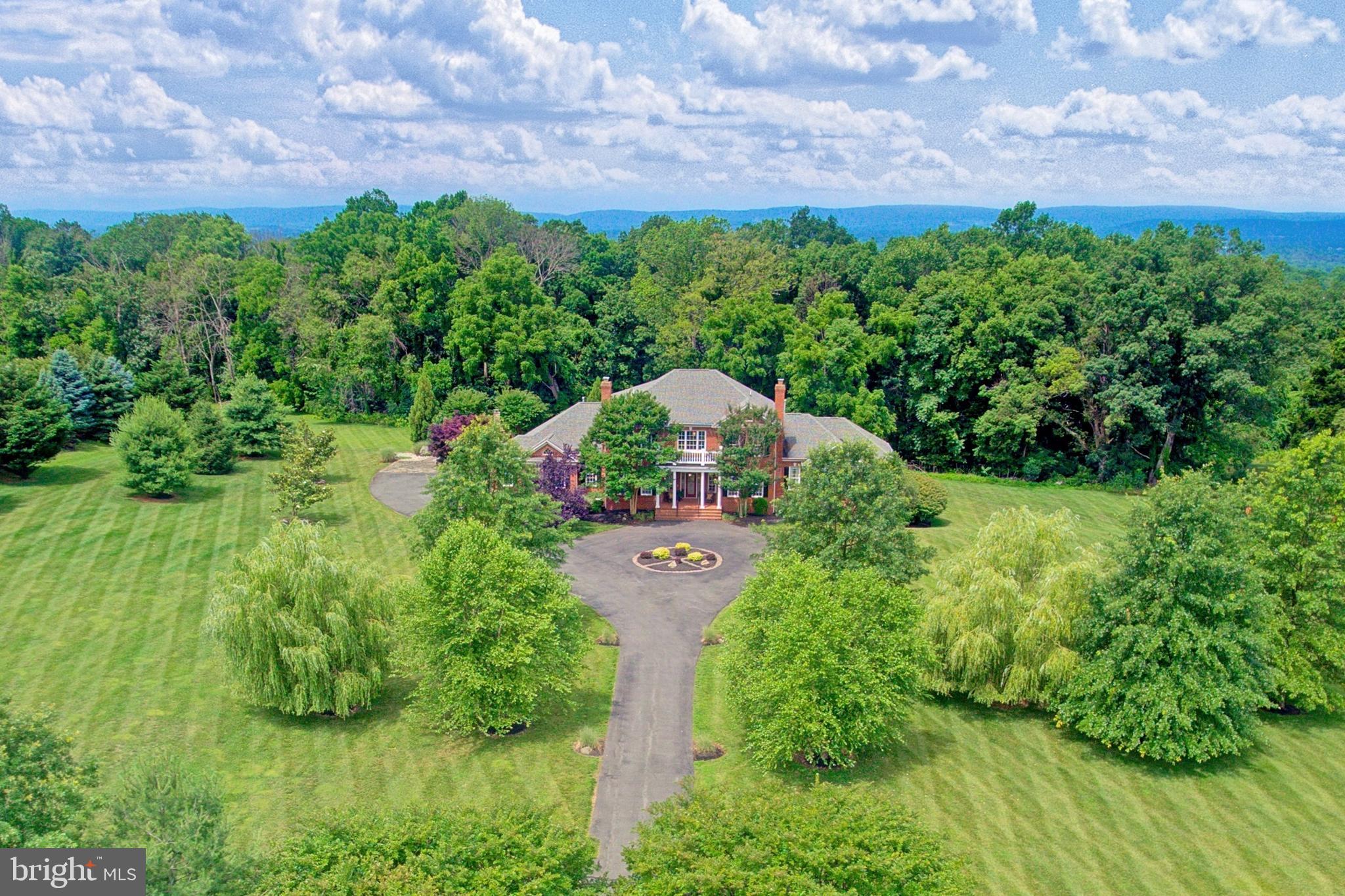 You’ll never be off season as your private indoor basketball court entertains and trains, all within your distinguished custom colonial by Garrett Homes. Welcoming from 3.31 acres of breathtaking landscaped privacy, your estate within prestigious Beacon Hill boasts over 8,700 square feet of airy open floorplan featuring rustic hardwoods, custom archways, soaring windows, and six housewarming fireplaces. While the multiple levels of your outdoor entertainer’s patio leads to a fall-perfect fireside oasis, inside, you’ll complete recipes in a gourmet kitchen outfitted with a sprawling gathering island, gorgeous professional-grade appliances, and a place to store favorite cheer. Here, prep grill favorites for al fresco summer parties, and set holiday meals where a tray ceiling and handsome hearth spark conversation. While the spectacular stone-clad family room features soaring windows overlooking the grounds, your fully finished basement hosts weeknight film screenings, drinks at the sports bar, rounds of game night fun, and a showstopping two-story basketball court. March Madness may come just once a year, but here, your basketball court provides hoop action all year long. Thoughtfully designed with guests in mind, host long-term stays within the first or second floor primary suites, while two further upper-floor bedrooms, with sunny en-suites, mean comfort for additional loved ones. While on tour, note spaces for greeting guests, closing deals, and imagine prepping for Greater Loudoun County adventure from within your three-car garage. Located in the heart of Wine & Hunt Country, Beacon Hill is sought-after by executives, athletes, and professionals for its estate and hamlet homes surrounded by breathtaking foothill views. Uniquely situated, you'll enjoy a blend of private country living just moments from routes to historic townships, posh OneLoudoun, IAD, and all greater Northern Virginia has to offer.