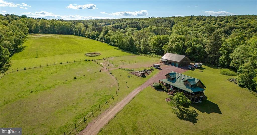 Welcome to this upscale Family estate and equestrian property you've been searching for!  Perfectly private and secluded this 34 acre farm features tillable land, lush hay fields & wooded land for the hunter.  Amazingly updated log home with vaulted ceiling and second floor loft.  Main floor gourmet kitchen with stainless appliances, separate dining room area and open concept living room.  First floor Master Suite with large walk in closet and updated full bathroom.  Master Suite has direct private access to wrap around porch and a luxurious hot tub waiting for you.  Laundry room and half bathroom complete the main floor.  2nd floor offers 2 nice sized bedrooms, both having walk in closets, loft area and 2nd full bathroom.   Lower level walk out basement features wide open canvas for additional living space and storage.  Outdoors feature spacious barn with 3 horse stalls, heated tack room, laundry area and half bathroom.  2nd floor hay storage in addition to 2nd floor 1 bedroom updated apartment proving additional rental income or extended family space.  4 indoor garage bays in addition to 4 equipment storage bays in the rear of the barn.  Approx. 10 acres of lush hay fields and 2 separate horse pastures as well as a round pen for training horses.  Mature fruit trees and raised garden beds along with a chicken coop and run for the Gentleman Farmer!  Amazing 360 views from your covered wrap around porch, this is a dream home!   Call for your private showing today!