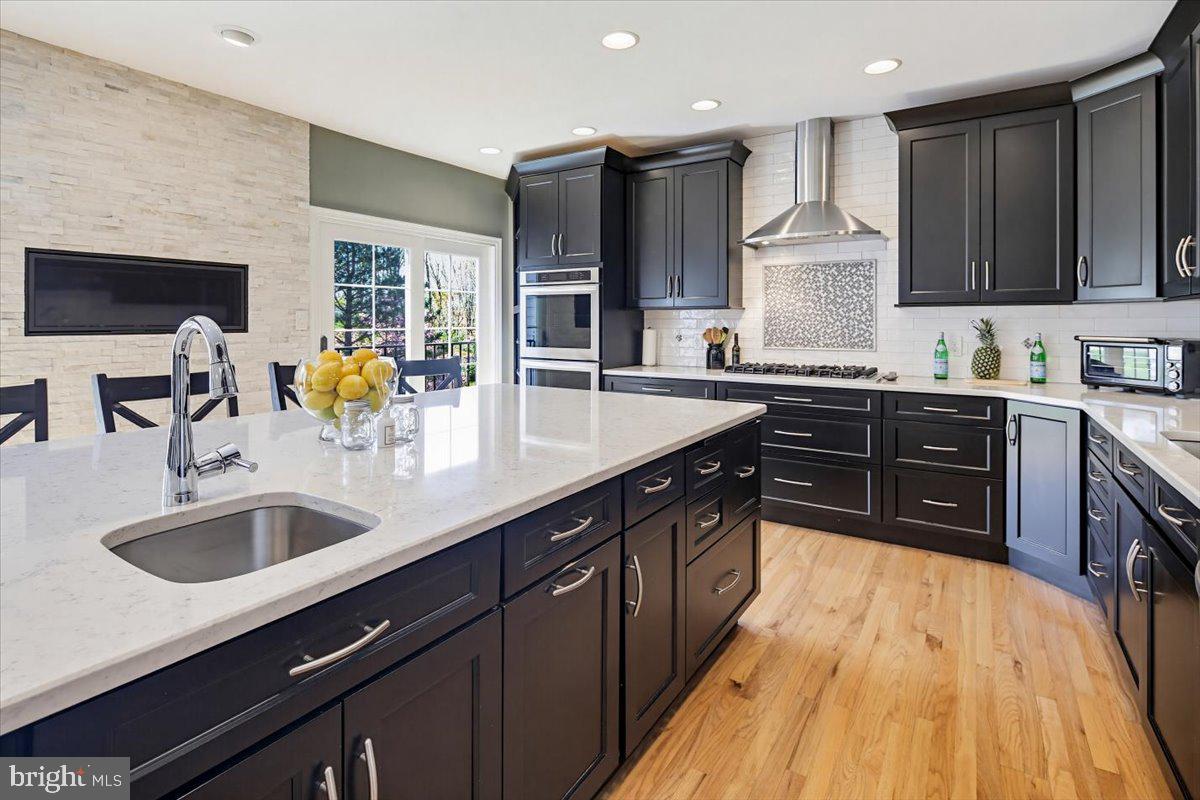Price improvement! Exceptional custom residence offering over 6,000 finished square feet, a rare 5-car garage, and an outstanding location in highly desirable Patapsco Park Estates within the sought-after Mt. Hebron High School district. This distinctive home combines space, functionality, and convenience in a way that is rarely available in Ellicott City, providing estate-style living without sacrificing proximity to major commuter routes, shopping, dining, parks, and everyday conveniences.

Designed for both entertaining and comfortable daily living, the home features hardwood flooring on two levels, generously sized living areas, an updated gourmet kitchen with premium finishes, dramatic dual-sided fireplace, finished walkout lower level with theater/media space and wet bar, and an impressive 663-square-foot TimberTech composite deck with integrated lighting. Abundant windows fill the home with natural light while thoughtfully designed spaces create warmth, character, and flexibility throughout.

Car enthusiasts, collectors, hobbyists, and buyers seeking exceptional garage and storage capacity will immediately appreciate the rare 5-car garage and expansive driveway parking—features seldom found this close to the heart of Ellicott City. Whether hosting gatherings, pursuing hobbies, working from home, or simply enjoying extra space, this property offers a lifestyle that is difficult to duplicate in today's market.

A private upper-level 2-bedroom suite provides additional flexibility for guests, extended stays, home office space, fitness room, creative studio, or other evolving lifestyle needs. Rare opportunity to own a one-of-a-kind custom home offering space, convenience, garage capacity, and long-term value in one of Howard County's most desirable communities.