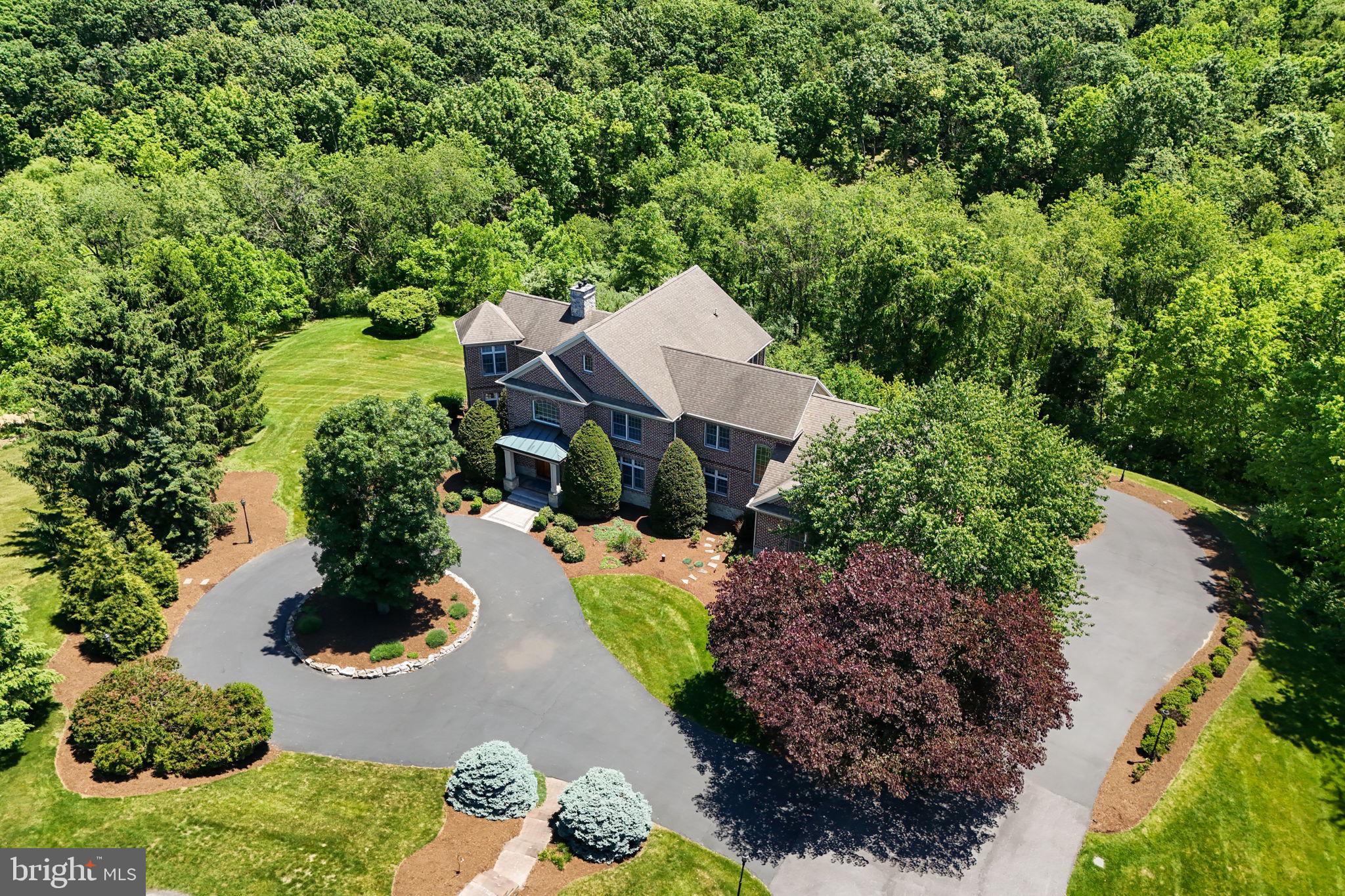 Welcome to 3 Conestoga Lane, an extraordinary custom-built all-brick estate tucked away at the end of a private cul-de-sac in the prestigious Rich Valley Manor community, located within the highly acclaimed Cumberland Valley School District. Expertly crafted by award-winning Farinelli Construction, this one-owner residence offers more than 6,300 square feet of exceptional living space on a breathtaking 6.89-acre homesite with panoramic views of the Blue Mountains. A grand circular driveway, stately masonry entrance, and professionally illuminated landscaping create an unforgettable first impression. Inside, impeccable craftsmanship is showcased throughout, from rich red oak and Brazilian cherry hardwood floors to custom millwork, dramatic coffered ceilings, floor-to-ceiling designer draperies, and exquisite Schonbek crystal chandeliers adorned with Swarovski Strass crystals. Designed for both elegant entertaining and everyday living, the gourmet kitchen features heated Italian tile floors, double ovens, a prep island with sink and InSinkErator, granite island seating, and a spacious breakfast area with built-in seating. The adjoining family room boasts soaring coffered ceilings and one of the home's three fireplaces, creating a warm and inviting gathering space. The executive office is a true showpiece with Brazilian cherry flooring, custom cherry built-ins, a fireplace, private sitting area, and direct access to an elevated deck overlooking the Blue Mountains. The luxurious owner's suite serves as a private retreat, offering a serene sitting area, dual walk-in closets, and a spa-inspired bath complete with heated floors, whirlpool tub, oversized walk-in shower with multiple body sprays, and dual vanities. The walkout lower level is an entertainer's dream, featuring a custom granite wet bar with seating for eight, recreation area, home theater, temperature-ready wine cellar with cedar racks for over 300 bottles, sunroom with Sundance Spa hot tub, bedroom, full bath, and seamless access to the custom paver patio. Additional highlights include: four- to five-car heated garage. Geothermal HVAC with three climate zones. Whole-home ELAN audio/video system with five independent zones. Smart lighting and automated blinds. Ethernet networking throughout. Integrated security system with Ring doorbells and floodlight cameras. Dual wells, reverse osmosis water purification, water softening system, and dedicated irrigation well. Custom mudroom lockers, expansive pantry, and thoughtfully designed dual-dryer laundry suite with laundry chute and built-in ironing station. Meticulously maintained and accompanied by a comprehensive owner's manual documenting every system and service history, this remarkable estate combines timeless architecture, sophisticated technology, and unparalleled craftsmanship in one of Silver Spring Township's most desirable locations. Experience a rare opportunity to own one of Rich Valley Manor's premier luxury residences.
