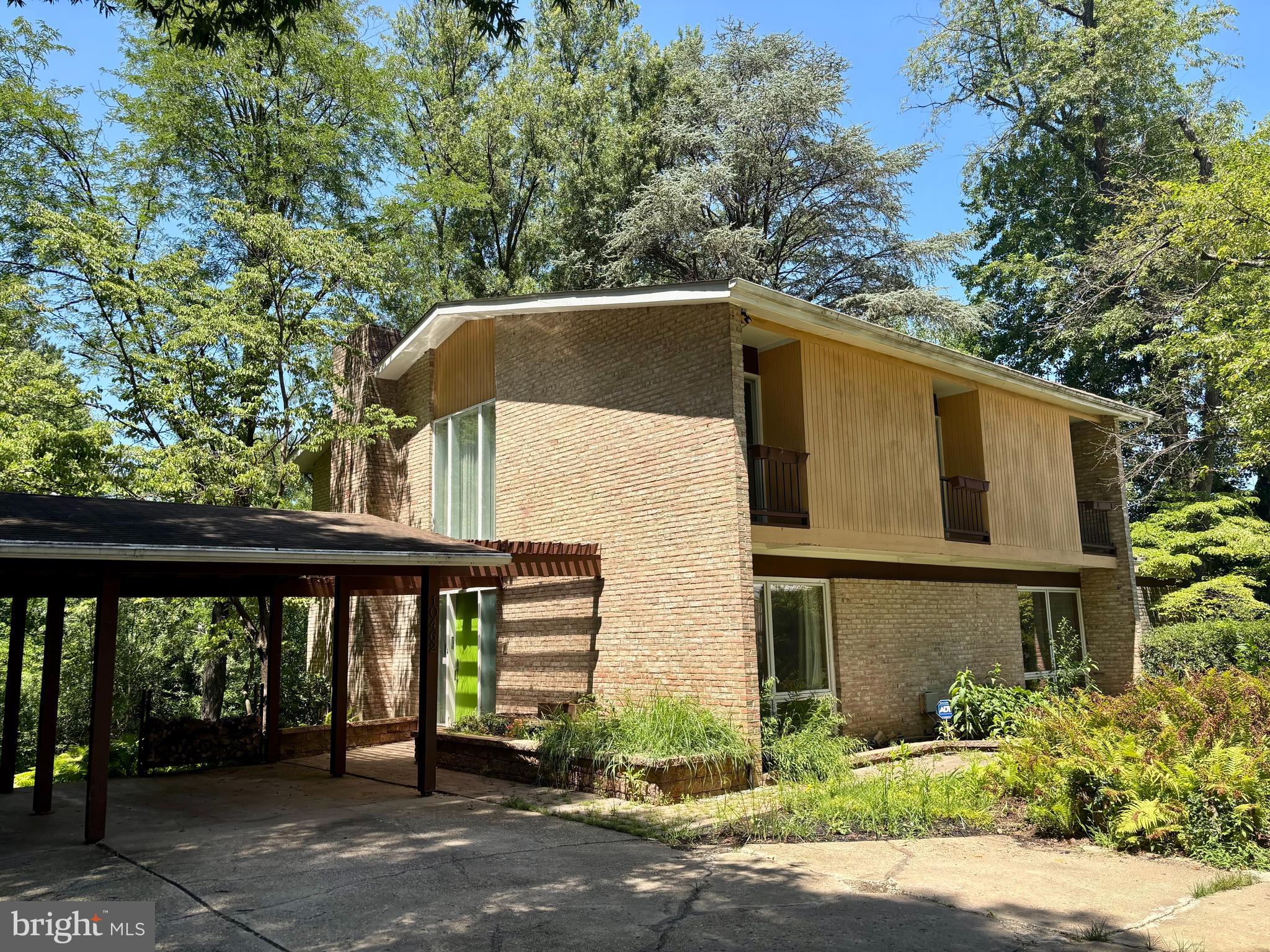 Nestled on a beautifully wooded 0.35-acre lot in Columbia's sought-after Bryant Woods community, this distinctive mid-century contemporary home offers over 4,300 square feet of living space and timeless architectural character. Floor-to-ceiling windows fill the home with natural light, while soaring ceilings, and spacious living areas create an inviting atmosphere for both everyday living and entertaining. 

Backing to a peaceful lake, the property features its own private dock, creating a rare opportunity to enjoy kayaking, fishing, nature watching, or simply relaxing by the water from your own backyard.

The home features 4 bedrooms, 3 full baths, and 1 half bath, along with multiple indoor and outdoor living spaces, including a covered deck, additional deck, covered patio, and expansive concrete patio—perfect for enjoying the peaceful, tree-lined surroundings.

The finished lower level provides additional flexible living space, while more than 1,000 square feet of unfinished basement offers excellent storage or future expansion potential. A covered carport adds convenience, and the mature landscaping enhances the home's private setting.

Ideally located near Columbia's extensive walking paths, parks, shopping, dining, commuter routes, and top-rated Howard County schools, this home presents a wonderful opportunity to update and personalize a truly unique property in an established neighborhood.