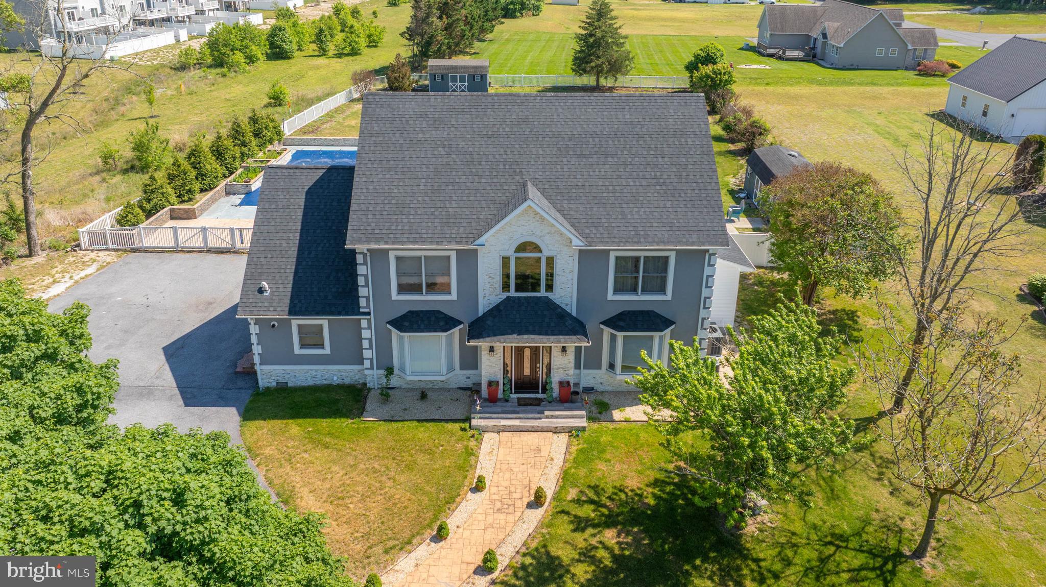 Welcome to an extraordinary PRIVATE RETREAT just outside the heart of Millsboro where resort-style outdoor living, exceptional space, and everyday convenience come together to create a truly one-of-a-kind property. Perfectly positioned near Millsboro’s major shopping district, this remarkable home offers easy access to all essential needs including grocery stores, hardware stores, pet stores, restaurants, and daily conveniences, while also providing an ideal location for commuters traveling to Berlin, Salisbury, Milford, and surrounding coastal destinations.
This impressive 6-bedroom, 4-bath property is designed to deliver the perfect balance of luxury, functionality, and lifestyle. Step outside to discover the show-stopping BACKYARD OASIS that transforms this home into a private resort. The STUNNING IN-GROUND POOL with a captivating waterfall feature creates a peaceful, vacation-inspired setting, while the hot tub offers year-round relaxation. The outdoor kitchen and bar area make this an entertainers dream while the expansive deck provides incredible space for outdoor dining, entertaining, or simply enjoying the beautifully designed surroundings. Charming gas lights create a warm and magical ambiance for evenings under the stars, while the gazebo offers the perfect shaded retreat—making every day feel like a getaway.
Inside, the thoughtfully designed multi-level floor-plan provides outstanding flexibility for large households, entertaining, or MULTI-GENERATIONAL LIVING. The main level features two bedrooms, including a spacious primary suite for convenience and accessibility. The second floor offers three generously sized bedrooms connected by a desirable Jack-and-Jill bath layout, while the third-floor suite serves as an extraordinary private retreat with an expansive sleeping area, dedicated living space, and full bathroom.
Whether you are hosting unforgettable poolside gatherings, accommodating guests with ease, or simply enjoying the unmatched combination of privacy and proximity to everything Millsboro has to offer, this exceptional property delivers a rare opportunity to own a home that truly combines luxury living with everyday practicality. With easy access to Delaware beaches, Maryland’s Eastern Shore, and key commuter routes, this home offers the lifestyle, location, and versatility today’s buyers are searching for.