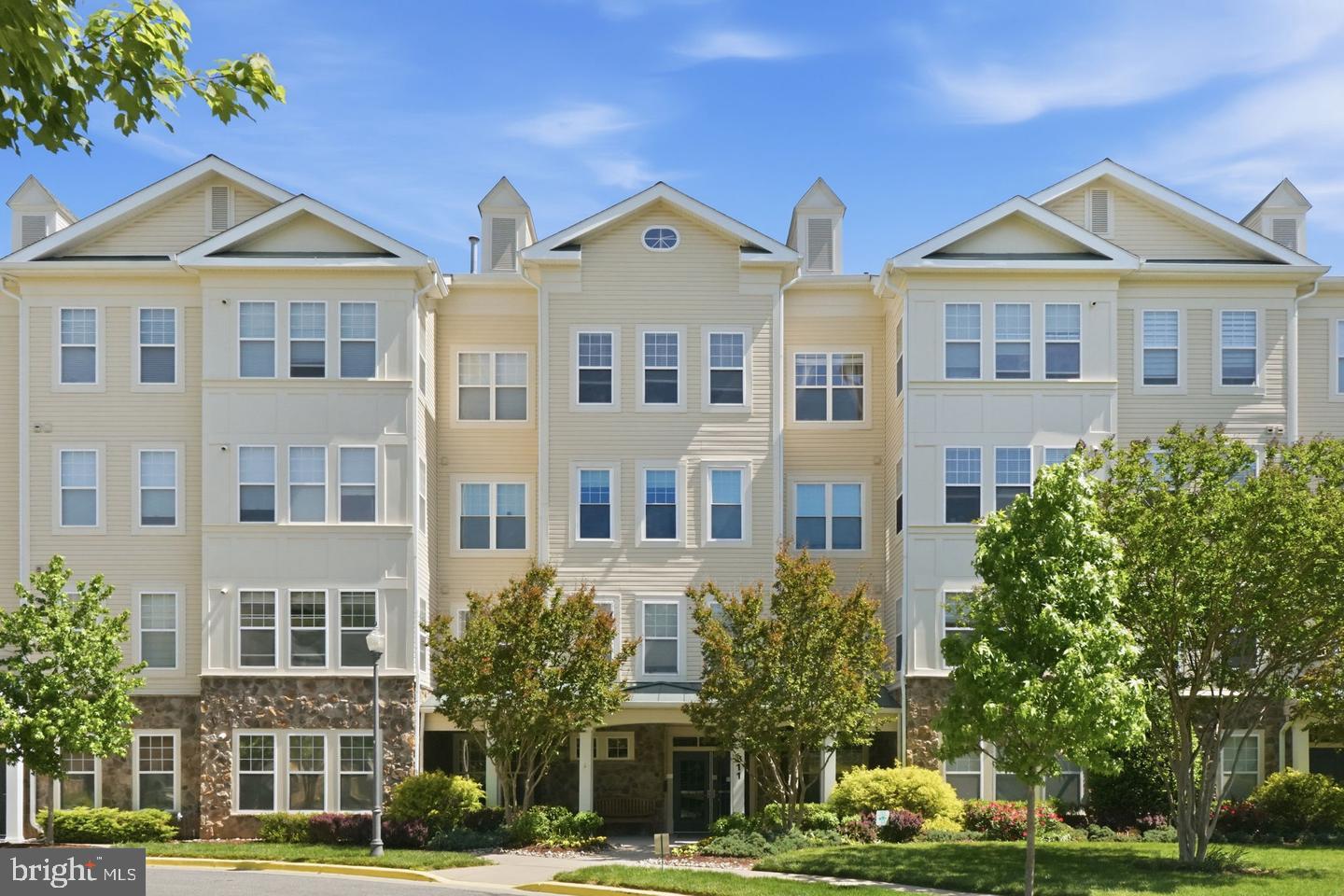 Welcome to this stunning and rarely available ground level residence in the highly sought-after Lakeland Ridge community—offering the perfect blend of space, comfort, privacy, and convenience. Nestled in one of the area’s most peaceful and wooded settings, this beautifully updated 2-bedroom, 2-bath condo features over 1,400 square feet of thoughtfully designed living space filled with natural light and timeless finishes throughout. From the moment you enter, you’ll appreciate the open and spacious floor plan, highlighted by new carpet (gleaming hardwood floors underneath), soaring natural light, and spacious living and dining areas designed for both everyday living and entertaining. The bright bonus room/den provides the perfect flex space for a home office, reading nook, or tranquil retreat overlooking serene wooded views. The modern kitchen is both stylish and functional, featuring stainless steel appliances, ample cabinetry, and a breakfast bar ideal for casual dining and gathering. The spacious owner’s suite easily accommodates a king-size bed and offers a large walk-in closet, an additional second closet, and a beautifully recently remodeled en-suite bath with double vanities and a glass-enclosed shower. A generously sized second bedroom with a second full bath provide ideal accommodations for guests or family. Additional highlights include an in-unit full-sized washer and dryer, assigned parking, additional storage, and pet-friendly living. Residents enjoy access to resort-style community amenities including a pool, clubhouse, and fitness center. Perfectly situated just minutes from Metro, ICC, I-270, Downtown Crown,  Kentlands shopping and dining, parks, and entertainment, this exceptional home offers the rare combination of peaceful surroundings and unbeatable commuter convenience. A truly special opportunity to own one of the community’s most desirable and private residences.