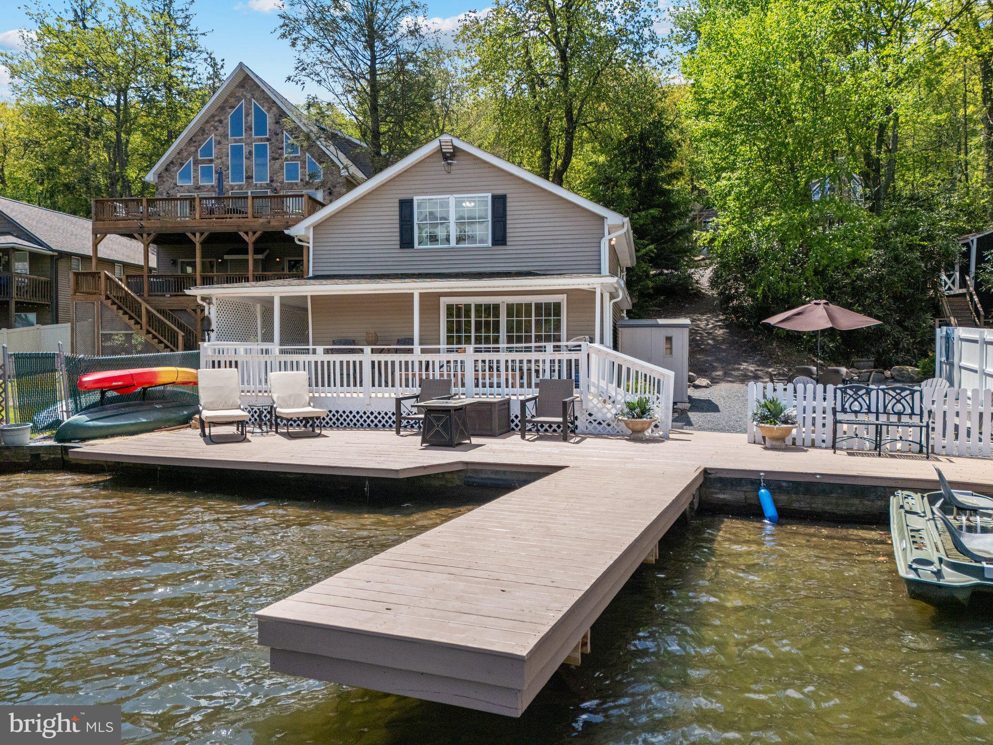 Rare opportunity to own a fully remodeled, designer-furnished lakefront home in one of the most coveted sections of Lake Harmony. Welcome to 34 South Lake Drive—a thoughtfully updated 5-bedroom, 2-bath retreat offering unmatched lakeside living and a lucrative investment rental property. Step through expansive sliding glass doors onto your private waterside deck, including separate areas for dining, lounging, and onto the dock where your boat and kayaks await! Inside, the open-concept layout features a kitchen, dining area, and generous gathering spaces designed with comfort in mind. With sleeping accommodations for 11 and two full bathrooms—including an upstairs bath with a combo washer/dryer—this turnkey home is ideal as a personal escape, vacation rental, or both. Central AC, water softener, quality appliances, and tasteful finishes throughout make ownership worry-free. This home includes a generous fenced side yard with fire pit, umbrella dining table, and 8x10 shed for storage. This property is completed with a private off-street parking lot for 8 vehicles. Immediately next door is 36 S Lake Drive, which is also for sale. The seller of these incredible properties may consider improved terms for buyers interested in purchasing both properties. Sale includes fixtures, furnishings, and appliances