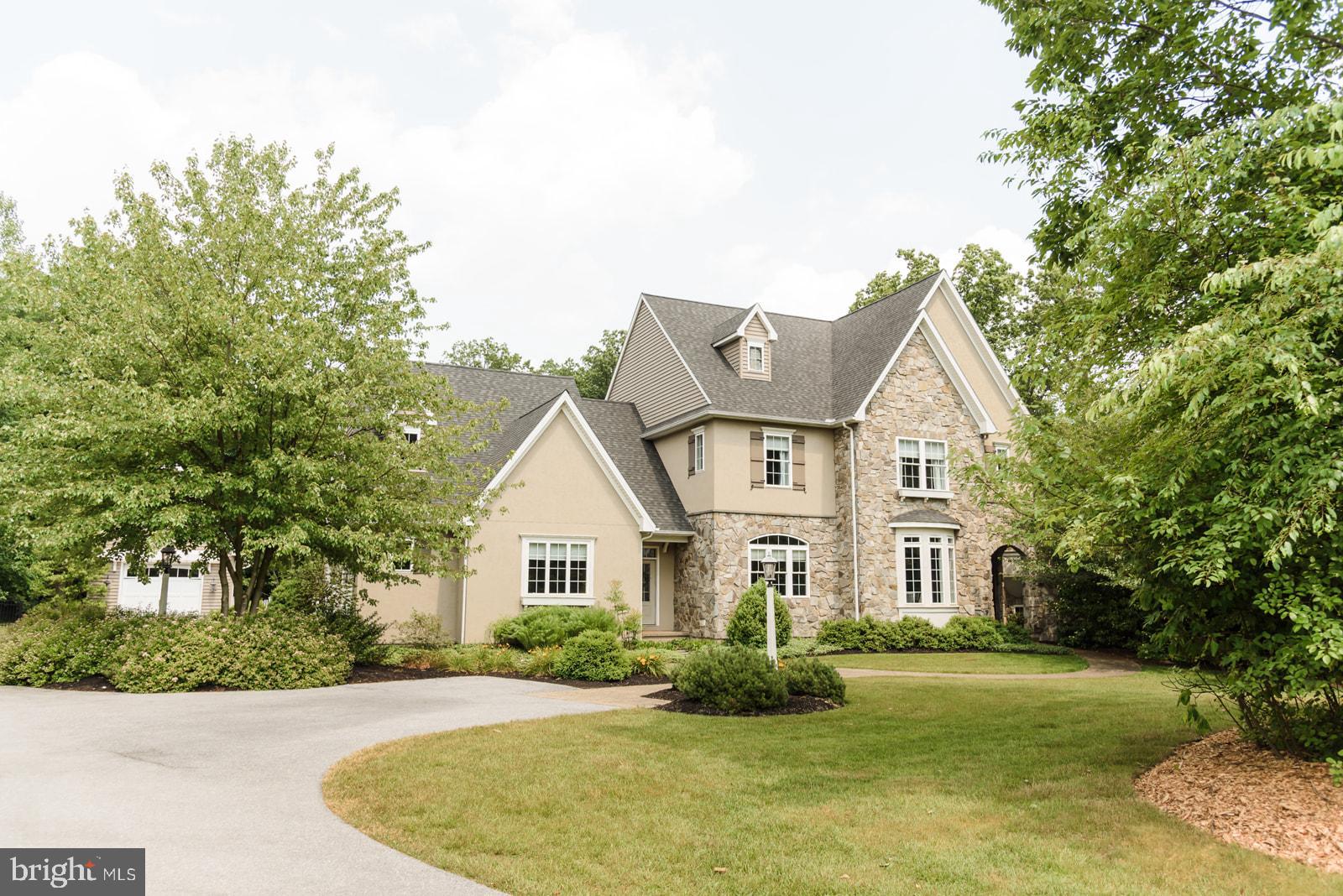 Nestled on 2.12 acres in the heart of the Welsh Mountain community, this 4,655 sq ft custom Hogan & Herr-built home offers quality craftsmanship and exceptional indoor and outdoor living. The stone and stucco exterior with striking gables sets the tone for this impressive property, complete with an attached 800 sq ft garage, a detached 17' x 22' garage, a paved driveway, and a private outdoor setting.

Inside, the modern kitchen features granite countertops, a breakfast bar, and high-end appliances, with easy flow into the dining room highlighted by a curved coffered tray ceiling and adjoining butler’s pantry. There's a comfortable living room featuring a gas stone fireplace, a sunroom overlooking the back patio,  and a bonus room that would make an awesome office, library, or study. 10' ceilings on the main level and 9' upstairs create a spacious feel, complemented by a bright, welcoming staircase.

The home offers 4 large upstairs bedrooms and 3 full bathrooms, plus an additional bath on the main level and another in the basement. The lower level adds more space for living and entertaining, with garage access, a fitness and game area, and additional flex space.

Outside, the backyard is set up for both relaxing and entertaining, with a built-in bar and grill area, dining space, and a curved seating area around the fireplace. A hot tub covered by a pergola, surrounded by mature trees, wildlife and thoughtful landscaping for a quiet, tucked-away feel.

Geothermal heating and cooling provide efficient comfort year-round. Located in the Pequea Valley School District and near Welsh Mountain Nature Preserve and Money Rocks County Park, the property has also been a successful short-term rental, offering both personal use and income potential. Come to the open house on Saturday and experience the well-built home in a private setting with space to live, entertain, and enjoy year-round.