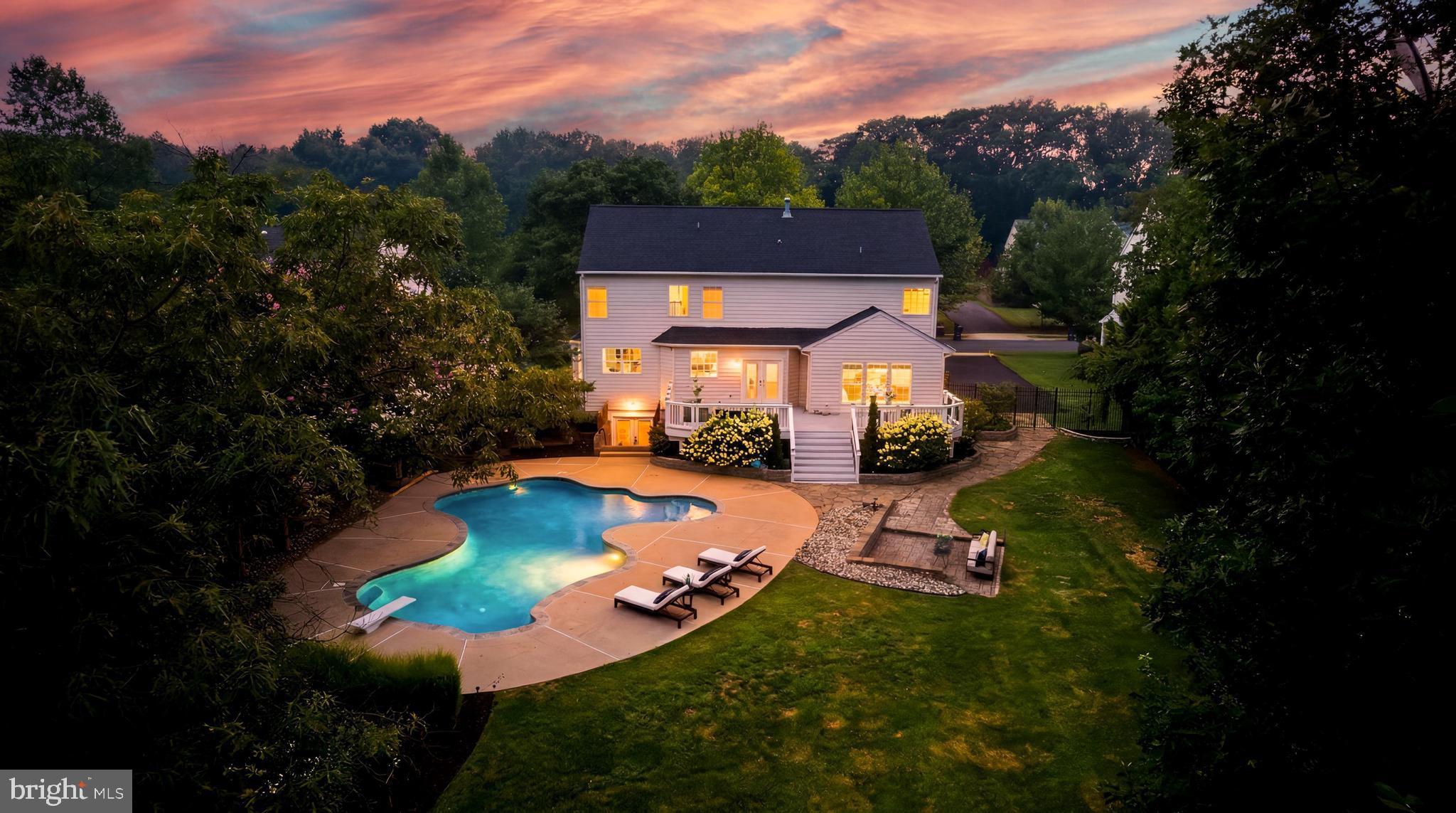 Set on a beautifully landscaped half-acre lot in one of Ashburn’s sought-after communities, this exceptional residence offers a rare combination of space, privacy, and convenience. The expansive backyard creates a true extension of the home, featuring a private in-ground pool, paver patio, expansive deck, and fully fenced yard designed for entertaining, recreation, and everyday enjoyment. With a thoughtfully designed floor plan, updated interiors, and a location within walking distance to the Silver Line Metro, this home offers an exceptional opportunity to enjoy the best of Ashburn living.

Inside, the two-story foyer welcomes you with abundant natural light, fresh paint throughout, recessed lighting, and a well-designed layout that balances open living spaces with dedicated areas for work and relaxation. Wide-plank hardwood floors extend throughout the main and upper levels, adding warmth and timeless appeal.

The beautifully updated kitchen serves as the heart of the home, featuring custom cabinetry, granite countertops, professional-grade stainless steel appliances, an oversized center island with seating, and extensive workspace. The adjoining breakfast area with a bay window opens to the family room, where walls of windows and a grand stone gas fireplace create an inviting space for everyday living and entertaining.

The upper level includes four spacious bedrooms, highlighted by the primary suite with a tray ceiling, private sitting area, large walk-in closet, and spa-like primary bath. A convenient upper-level laundry room adds functionality to the home’s thoughtful design.

The finished walk-up lower level provides additional living space with 9-foot ceilings, a recreation room, wet bar, media room, full bathroom, and flexible areas ideal for guests, hobbies, entertaining, or relaxation.

Beyond the home’s impressive living spaces, the backyard provides a private setting surrounded by professional landscaping and mature greenery. The half-acre lot offers exceptional room to enjoy the outdoors, whether hosting gatherings, relaxing poolside, or creating a space tailored to your lifestyle.

Additional improvements include a roof replacement in 2021, HVAC replacement in 2021, fresh paint throughout, and recessed lighting updates. Ideally located within the Briar Woods High School pyramid and within walking distance to the Silver Line Metro, this home also offers easy access to the Greenway, Dulles International Airport, premier shopping, dining, parks, and neighborhood amenities. Offering a rare combination of spacious interiors, a private outdoor setting, and exceptional convenience, this property presents an outstanding opportunity in Ashburn.