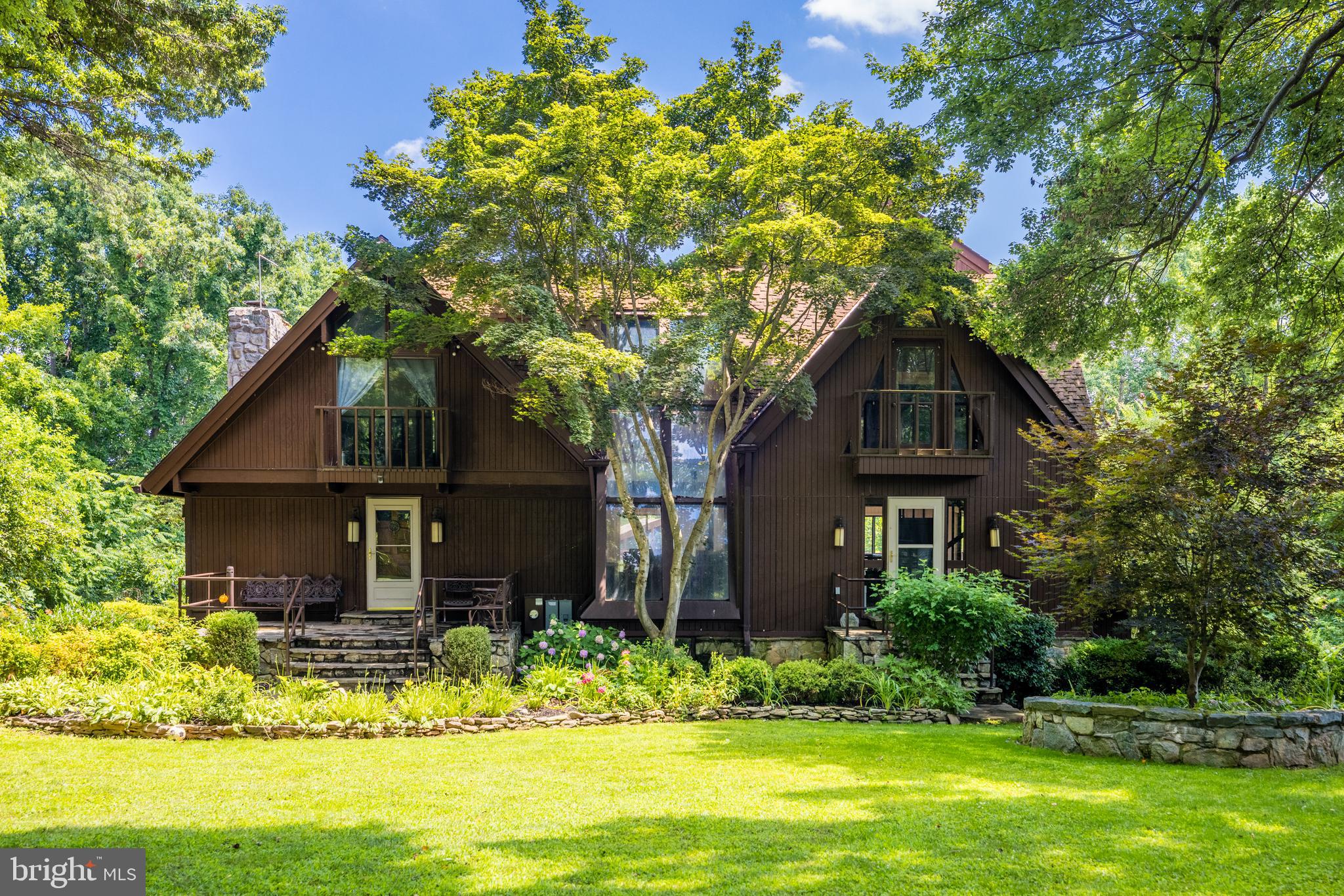 Private Woodland Retreat on Nearly 2.5 Acres with Indoor Pool & Guest Apartment

Set on nearly 2.5 acres of mature trees and landscaped gardens, this secluded estate offers unmatched privacy and year-round beauty. Outdoor highlights include ponds, stone patios, a pergola, screened porch, fire pit, BBQ grill, greenhouses, a playhouse, and a detached two-car garage with carport and a one-bedroom apartment above.

The main home blends rustic charm with resort-style amenities—vaulted beamed ceilings, skylights, stained glass accents, and Juliet balconies. At its center is a spectacular indoor pool with stone waterfall, hot tub, and sauna. The main level features a dramatic stone fireplace, redwood kitchen countertop, bar, and dining areas. Upstairs offers a library/office, guest room, and a two-story owner’s suite with spa bath. The lower level adds a recreation room, two dens, large bath, and direct patio access.

With abundant amenities, distinctive architecture, and a rare combination of indoor luxury and outdoor beauty, this property is truly one of a kind. Property is sold "as is"