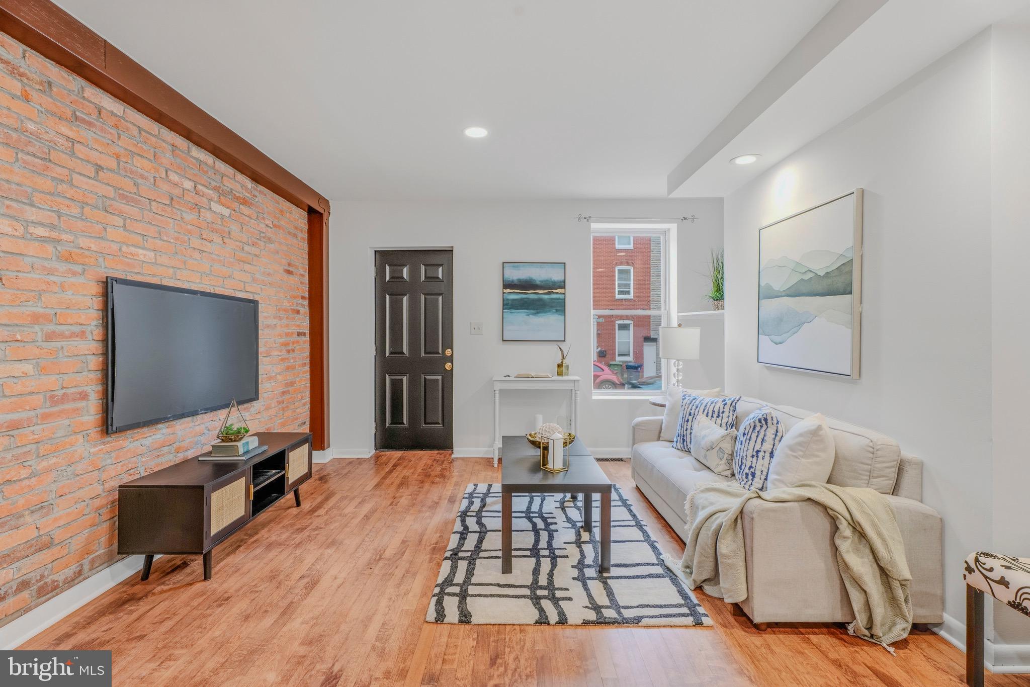 You will want to check out this townhome centrally located west of Patterson Park and north of Fells Point.  This location allows for great walkability to area restaurants and businesses.  This home has had many updates and upgrades but retains historic charm with exposed brick and wood beams throughout the home. 
Main level has hardwood flooring in the open Living Room and Dining room area.  Kitchen has wood cabinets, stainless appliances, and granite countertops.  There is also a main level full bathroom and Laundry room.  Heading upstairs to the 2nd level, you'll see the hardwoods carried throughout the hallway and bedrooms.  There are two bedrooms and a 2nd full bath on this level.  Another staircase takes you to the 3rd story Primary Bedroom suite that is spacious enough for a sitting room area.  With its exposed beams and brick, this area creates a private retreat.  The home has a fenced backyard with Patio and back alley access to the side street.  There is plenty of storage in the Basement too.  Act quickly!  This one won't last!!!