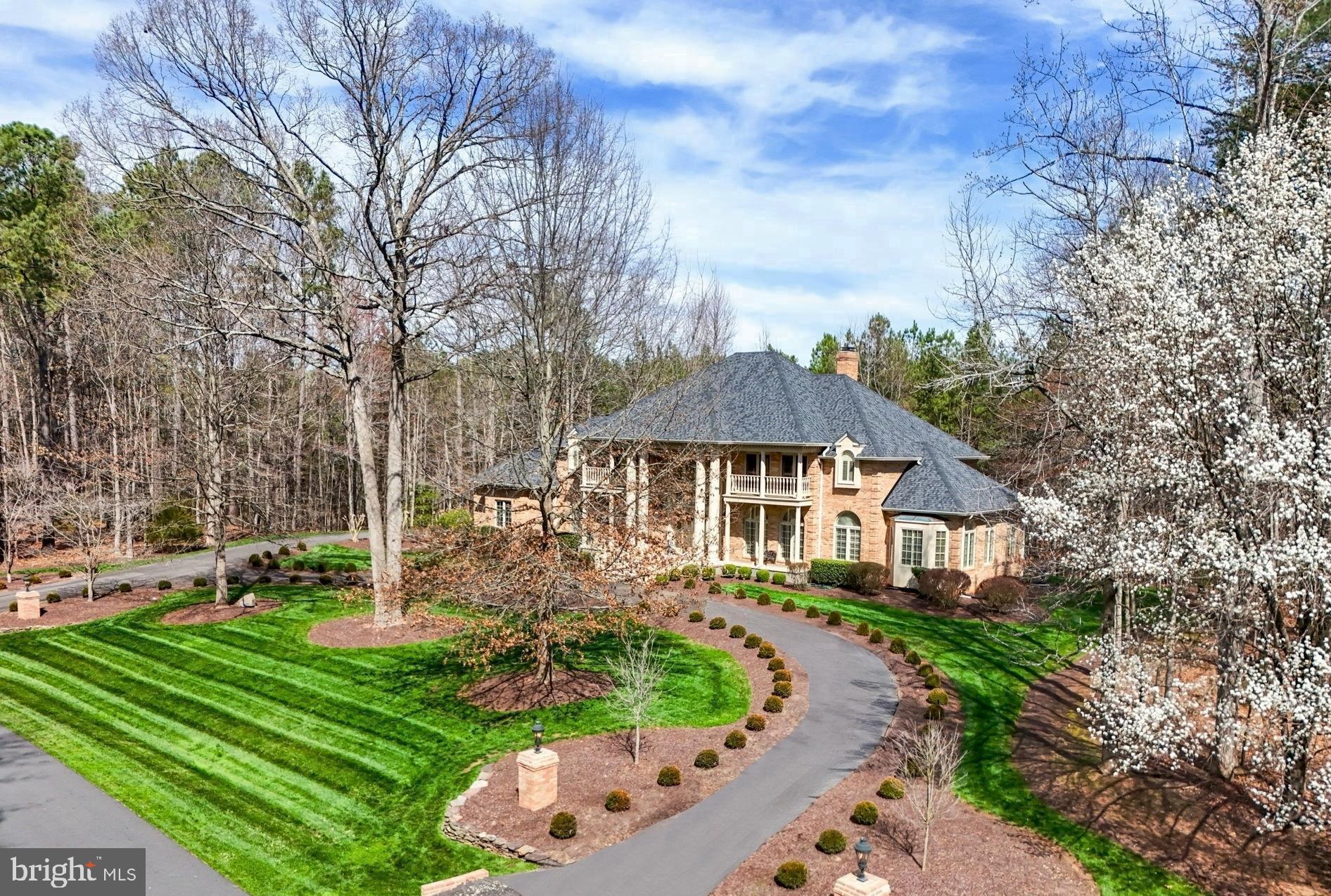 Located inside the prestigious Fawn Lake Community, this Magnificent Georgian Estate captures a classic elegance and grandeur evident from every angle. Boasting voluminous opulent spaces that are perfect​ for luxurious daily living and impressive entertaining.​ The well appointed interior is graced with stunning architectural details, timeless luxury amenities and artfully curated living spaces. Palladium windows, Wainscoting, coffered ceilings, balconies, rich wood accents and paneled walls emphasize the level of detail throughout.  Stately columns, a circular driveway and manicured grounds add to the beauty of the elegant ​exterior facade. Perched on a two acre homesite abutting a conservation area, the tranquil private backyard is filled with lush landscaping and an array of flowering shrubs and trees for ultimate privacy​! 
Stepping through the double Mahogany doors, a grand and opulent two-story foyer with gleaming hardwood floors and a grand curved staircase welcomes you. A stunning archway leads to the spectacular Living Room with soaring coffered ceilings, gas fireplace, floor to ceiling windows, affording views of the incredible views of nature, and French doors allowing access to the expansive deck. The Elegant Dining Room with exquisite details and Palladium windows offers the perfect setting for formal gatherings.
The dream gourmet chef's Kitchen with beautiful custom cabinetry, granite countertops, high-end appliances, and a large center island, serve as the perfect space to cook meals and host guests. The adjoining Breakfast area with large windows offering brilliant sunlight and breathtaking views of nature, features French doors leading to the beautiful deck spanning the rear of the home.  Designed for ease and comfort, the main level offers two gracious Bedroom Suites with large walk-in closets and Full Private Baths. A beautiful and charming Sunroom serves the ideal area for gathering.  
The upper level includes an expansive luxury Owner's Suite featuring a Sitting area with a gas fireplace, double French doors providing balcony access and incredible views, a fabulous walk-in closet with custom wardrobe organizer, large spa bath with double vanities, tile shower and a soaking tub for relaxing. 
A gracious Bedroom Suite with a beautiful private Bath and walk-in closet features double French doors leading to a large balcony. An additional Bedroom suite with private Bath and 3 closets complete the upper level.  The finished basement continues to impress. Designed with abundant comforts and features to entertain, the open space features a large Recreation Room with an impressive Wet Bar with granite countertops, a Family Room with built-in media cabinets and  stone gas fireplace. An amazing Formal Office / Library features an array of custom built Cherry Bookcases and even a  hidden wine cellar!
Immersed in privacy, the incredible backyard sanctuary with a Waterfall and park-like grounds was designed for enjoying the beautiful sights and sounds of nature.  A Covered Flagstone patio, easily accessed from the walk-out basement is perfect for lounging and relaxing. Tiered steps lead to the Flagstone Patio that serves as an idyllic space for extended outdoor living, alfresco dining, and entertaining! The manicured grounds are easily maintained with the 20 zone irrigation system.  An oversized 3-Car Garage features a workbench, utility sink, storage cabinets and even two vacuum systems.  The Extended Circular Driveway features two grand entrances anchored with lighted stone pediments.  Here's an incredible opportunity to own a unique Masterpiece in Fawn Lake!
Located in a highly desirable established area, within walking distance to the marina, Country Club Restaurants, beach, tennis courts, and all the wonderful amenities Fawn Lake has to offer! Enjoy Boating, kayaking, golf, soccer and ball fields, dog park, volley ball, walking trails, community center, playgrounds, and so much more!