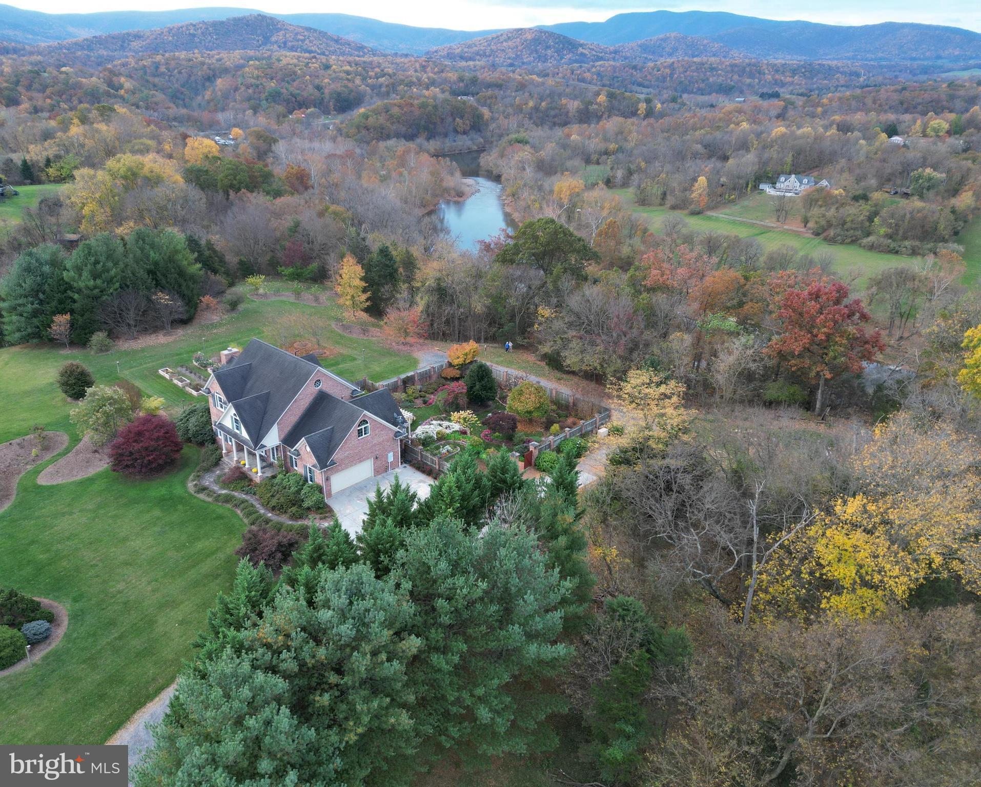 This stunning 5 bedroom, 3.5 bath nearly 4,500 sq ft custom-built home on 20 acres sits majestically along the South Fork of the Shenandoah River with 360-degree views that include the Shenandoah National Park (in the Blue Ridge Mountains), the George Washington National Forest (on Massanutten Mountain), and the Shenandoah River itself.  Working from  home will feel like a vacation at this estate that offers high-speed fiber optic internet. Be sure to review the impressive features outlined in detail in the documents section of this listing including additional information describing the museum quality British-style brick walled garden (enjoy trellises, year-round fountains, a wooden pergola, dwarf conifer beds, rock garden, six raised vegetable beds, established fruits & vegetables) & so much more.  Owners invested well over $300k in exterior gardens/landscaping throughout the years.MAIN LEVEL:Open floor plan w/ hardwood floors & surround sound wiring throughout/LIVING ROOM w/ 27’ cathedral ceiling (note the view-filled large arch windows on 3 sides), gas fireplace (w/bluestone hearth/Sitting room area (adjacent to the foyer) w/ 9’ ceiling, foyer pewter chandelier/Formal DINING ROOM w/ 9’ ceiling, 2 double fixed-French doors to enhance mountain views, pewter chandelier & wall sconces, pocket door to kitchen/Spacious KITCHEN (updated appliances and counters in 2019)w/ 9’ ceiling, matching GE Profile appliances (including gas cooktop, electric wall-oven, microwave, refrigerator with ice-maker & dishwasher), quartz countertops, 10’ kitchen island, built-in hickory cabinetry (including pantry, bookcases, lighted display area and undercabinet lighting/BREAKFAST ROOM open to kitchen with stained-glass pendant light, large windows for viewing landscaped walled-garden and mountains & screened-porch access w/double French doors/Main level 5th BEDROOM w/9’ ceiling, large wall of windows with view of landscaped backyard garden, 2 closets and half bath/Separate office or mudroom area adjacent to kitchen with overhead light, transom window/Rear SCREENED PORCH w/vaulted ceiling and exposed beams, roll-up sunshades, propane gas fireplace, mountain and river views and bluestone floor/Main level 2 CAR GARAGE w/added storage space & shelving plus generator electric panel 2ND AND 3RD LEVEL:  Open 4’ wide hardwood stairway overlooking living room w/oak newels and spindles/4 bedrooms & 3 full bathrooms on 2nd level including a PRIMARY BEDROOM w/tray ceiling, bay window, attached bath suite including a large ceramic tile shower, separate soaking-style bathtub, double sinks w/5’ vanities (fixtures updated in 2019), 2 spacious walk-in closets w/built-in shelves/LAUNDRY ROOM (including washer, dryer, built-in cabinets, storage closet, linen closet)/HOBBY ROOM enhanced by a vaulted ceiling, built-in work areas, 2 fixed-large circular windows for natural light & views, an area used for model railroad, pine hardwood floors, closet w/75 gal. whole-house gas hot-water heater, closet w/HVAC system (1 of 3–the heat pump for upper floors that includes an Aprilaire air purification system) BASEMENT LEVEL:  Finished basement area including oak cabinets, 2 over-head stained-glass pendant lights and ENTERTAINMENT AREA including built-in oak cabinets/Separate WOODWORKING SHOP area w/additional electrical/1 vehicle garage space with single garage door, wooden shelving, overhead lighting, window-wells for natural lighting with exterior steel door, closet with HVAC system (2 of 3–heat pump w/gas furnace back-up heat that includes an Aprilaire air purification system)/Separate unfinished basement area with HVAC system (3 of 3–a heat pump w/ gas furnace back-up heat that includes an Aprilaire air purification system and built-in humidifier for main level), Culligan water treatment system, ultra-violet light water purification system, well-pump (w/ particulate water filter), ample storage area with shelving & additional electrical panel box.