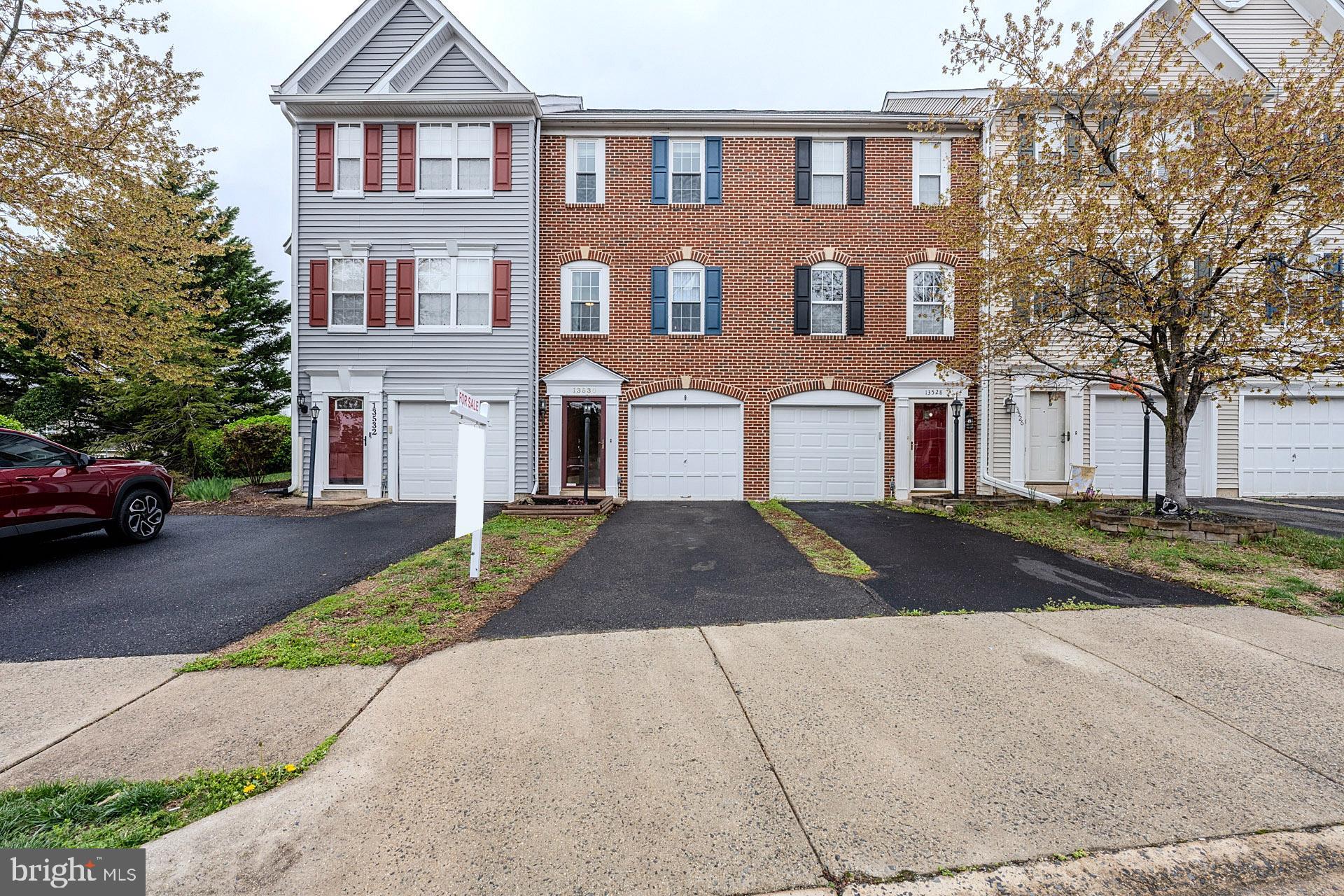 Discover this charming 2-bedroom, 1.5-bath brick front townhome with garage backing to common area and trees in the sought-after Kingsbrooke community, offering low HOA fees and a host of modern upgrades! Step into the stylish kitchen featuring gleaming granite countertops, white 42” shaker style cabinetry, custom tile backsplash, newer stainless steel appliances, and ample dining space in the a cozy breakfast nook. The living room boasts a gas fireplace with a beautiful custom mantle and elegant French doors leading to a spacious composite deck overlooking trees with stairs down to the fully fenced backyard—perfect for entertaining and simple relaxation! Back inside, a dining area and chic powder room with pedestal sink rounds out the main level. ****** Upstairs, the primary bedroom impresses with a soaring vaulted ceiling with display ledge, lighted ceiling fan, and built-in shelving, while the renovated full bath offers a jetted soaking tub, separate shower, and dual sink vanity for a spa-like retreat. The second bright and cheerful bedroom shares access to the full bath. ****** The versatile lower level includes a recreation room (potential 3rd bedroom with closet!), plus a laundry closet with full sized washer and dryer for added convenience. Parking is a breeze with a 1-car garage, driveway, and an assigned extra parking space. Enjoy peace of mind with a new roof, water heater, composite decking, updated flooring, and more! ****** All this can be found in a peaceful yet vibrant community with fantastic amenities including an outdoor pool, clubhouse, sports courts, jogging/walking paths, bike trail, playground, common grounds, and so much more! Commuters will appreciate the close proximity to I-66, Route 29, Prince William Parkway, and other major routes. Everyone will enjoy the abundance of trending shopping, dining, and entertainment choices in every direction!