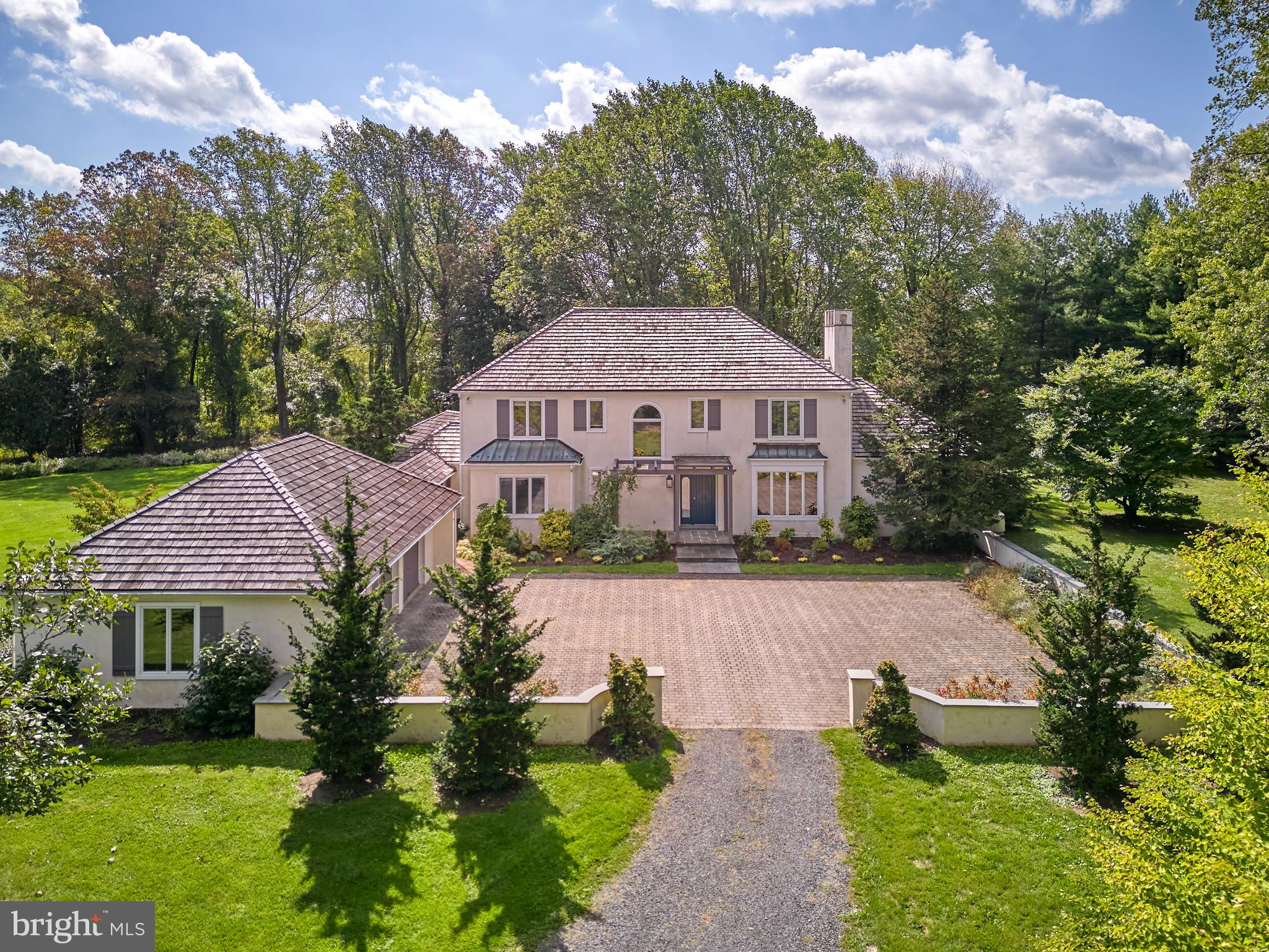 This perfectly private Estate Home sits on almost 4 acres of lush gardens bordered by preserved land and yet is only minutes to Doylestown Borough in Central Bucks School District.  The setting is absolutely magical during all seasons with gardens of thoughtfully planted peonies, perennials, and unique specimens of trees.  A long winding driveway approaches the belgium block courtyard, setting the mood for this chateau like residence.  Remarkable architectural design and unique finishes define this 4-bedroom 3 full bath custom built home.  It features over 4,000 square feet of living space that includes a dramatic formal living room with a wood burning fireplace as its centerpiece, a formal dining room with artfully designed built ins, a cozy den with its own Mercer tiled fireplace, and a beautiful executive office with floor to ceiling cherry cabinetry. Enjoy beautiful views of nature from every living space as the thoughtful placement of an abundance of windows and glass doors have brought the outdoors in.  The deco style kitchen boasts top of the line appliances (sub zero refrigerator and 6 burner stove), a large island and a charming screened in porch with garden and country views.  The recently designed and constructed mud room is the perfect gateway to the home for the active family. Enter it through the covered walkway from the detached 3 car garage and bench style cabinetry with storage hooks and cubbies make it easy to unload.  This mudroom also features large storage closets and a farm style sink for easy cleanup. Upstairs, our master suite features 2 walk in closets a luxurious soaking tub, a tiled shower with dual vanities, beautiful tiled floors and an abundance of windows for natural light and views of the outdoors. There are 2 additional large bedrooms on the 2nd floor along with an updated hall bath with pocket doors and a fabulous 2nd floor laundry featuring every convenience you could need. A charming loft area completes the 2nd floor easily used as a sitting area. Our 4th bedroom is on the main level with a full bath right next to it just perfect for overnight guests. This lovely residence is perfect for entertaining, be it indoors or out, and combines the perfect balance of formal and casual living.  Easy to show and our pleasure to sell.