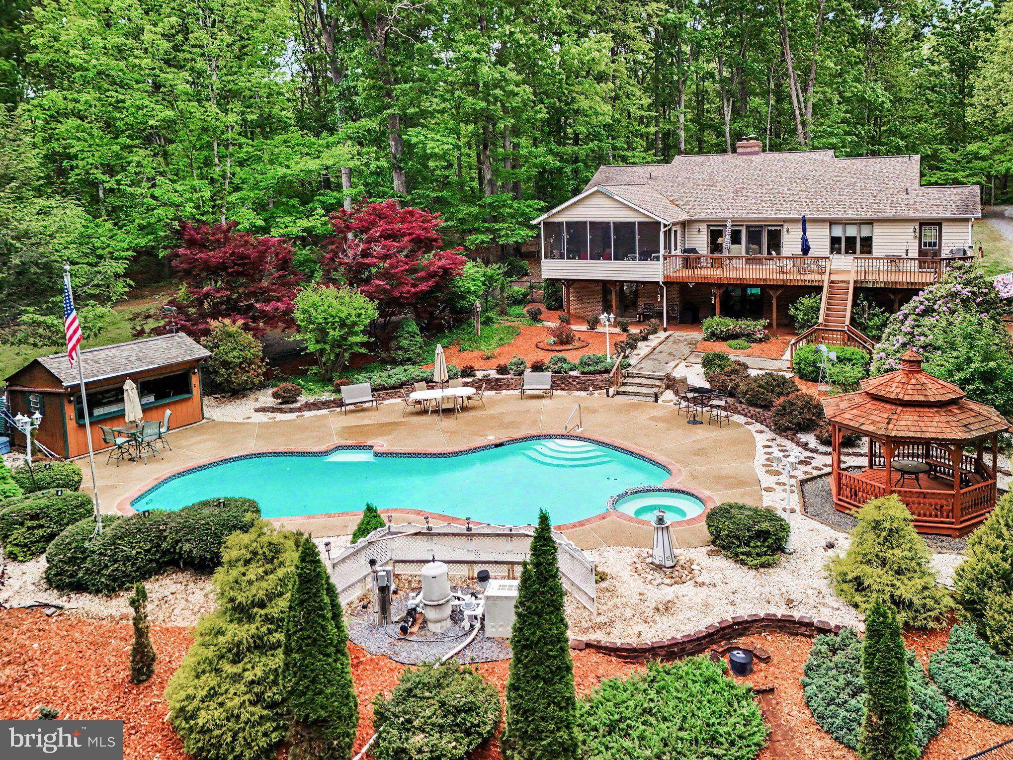 Tucked away on 7 private acres in the heart of Unionville, this exceptional property offers the perfect blend of comfort, functionality, and outdoor living. Featuring 4 spacious bedrooms and 3 full bathrooms, this home is designed for both everyday living and entertaining. Inside, you'll find soaring vaulted ceilings, beautiful hardwood floors, a cozy fireplace, and ample windows that fill the home with natural light while showcasing peaceful views of the surrounding landscape.

The thoughtfully designed layout includes a finished basement complete with an in-law suite kitchen, a full bedroom, and a full bathroom—ideal for multi-generational living, guests, or extended stays. The basement also offers a large storage area, providing plenty of room for seasonal items, hobbies, equipment, or workshop space.

Outdoor living truly shines with a welcoming covered front porch, a rear screened-in porch perfect for relaxing evenings, and newer expansive Trex decking overlooking the backyard retreat. Step outside to your own private oasis featuring a heated pool complete with a cabana and gazebo, creating the ultimate setting for entertaining family and friends all summer long.

For those needing additional storage and workspace, the property includes an oversized detached 3-car garage along with several large sheds. Walking paths wind throughout the acreage, allowing you to fully enjoy the beauty and privacy of the land. Additional highlights include a newer roof, water treatment system, and high-speed internet availability—offering the ideal balance of peaceful country living with modern conveniences.

This rare Unionville property delivers space, privacy, flexibility, and amenities that are hard to find in one complete package.