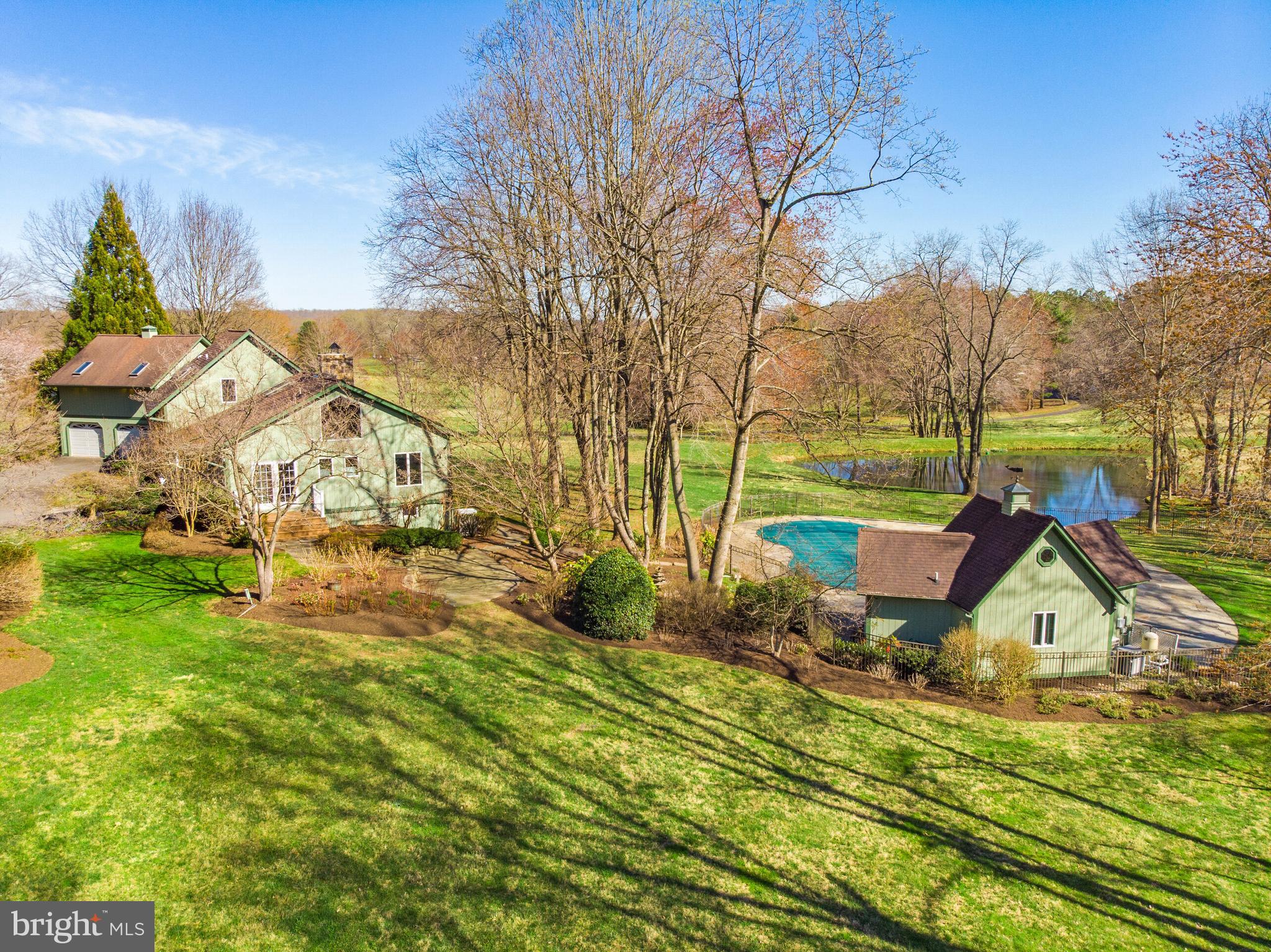 Enchanting 11 acres, which includes a separate residential building lot, this extraordinary Post & Beam Custom Contemporary home offers harmony, privacy and sophistication in the country. A majestic 45 year old Japanese Maple greets you outside as you enter this incredible home. The foyer features a custom Birchwood archway which immediately draws your eye to the wall of windows that showcases the open floor plan with post and beam ceiling, a stone fireplace and expansive views of the lake and pool. This home features an exquisite library nook complete with a reading loft overlooking the lush landscaping. 100 year old barn-wood 8” width pine floors flow throughout the first and second levels of this home. Enjoy a full bathroom and bedroom on main level. The Chef’s kitchen is a cook’s dream, outfitted with all Viking commercial grade appliances. From the kitchen sink you will enjoy views of the front yard featuring flowering cherry trees, ferns that completely cover any visible ground from spring to late fall, and plenty of color each season from Camelias, Yokuza flowering Dogwood, daffodil in spring, peonies in May and summer blooming, massive hydrangea bushes. The open living area of the main level of this home includes the dining area, family room and an oh-so-private deck that overlooks the lush views. There is a surprise private office or sun room in the basement with wall of windows overlooking the grounds. The finished basement offers a theater area, small karaoke room and disco light to make for many fun evenings of entertainment. The pool area features expansive stone decking, perfect for gatherings, and is surrounded by more lush landscaping and a view of the lake with a trickling stream. The pool house boasts a full bath and is set up to have a full kitchenette installed, converting it to a wonderful guest house. Beyond that is a huge three stall garage for your car collection with doors that could easily be replaced to convert it to horse stalls. This home comes complete with state of the art video equipment and monitors. Other components of the home include two HVAC systems, a whole-house generator that automatically runs if the power fails and all of the flat screen TV’s. Everything in the home has been meticulously maintained as you will see. This home offers a separate residential building lot just next door that could be sold separately or used to build another home for a family member.