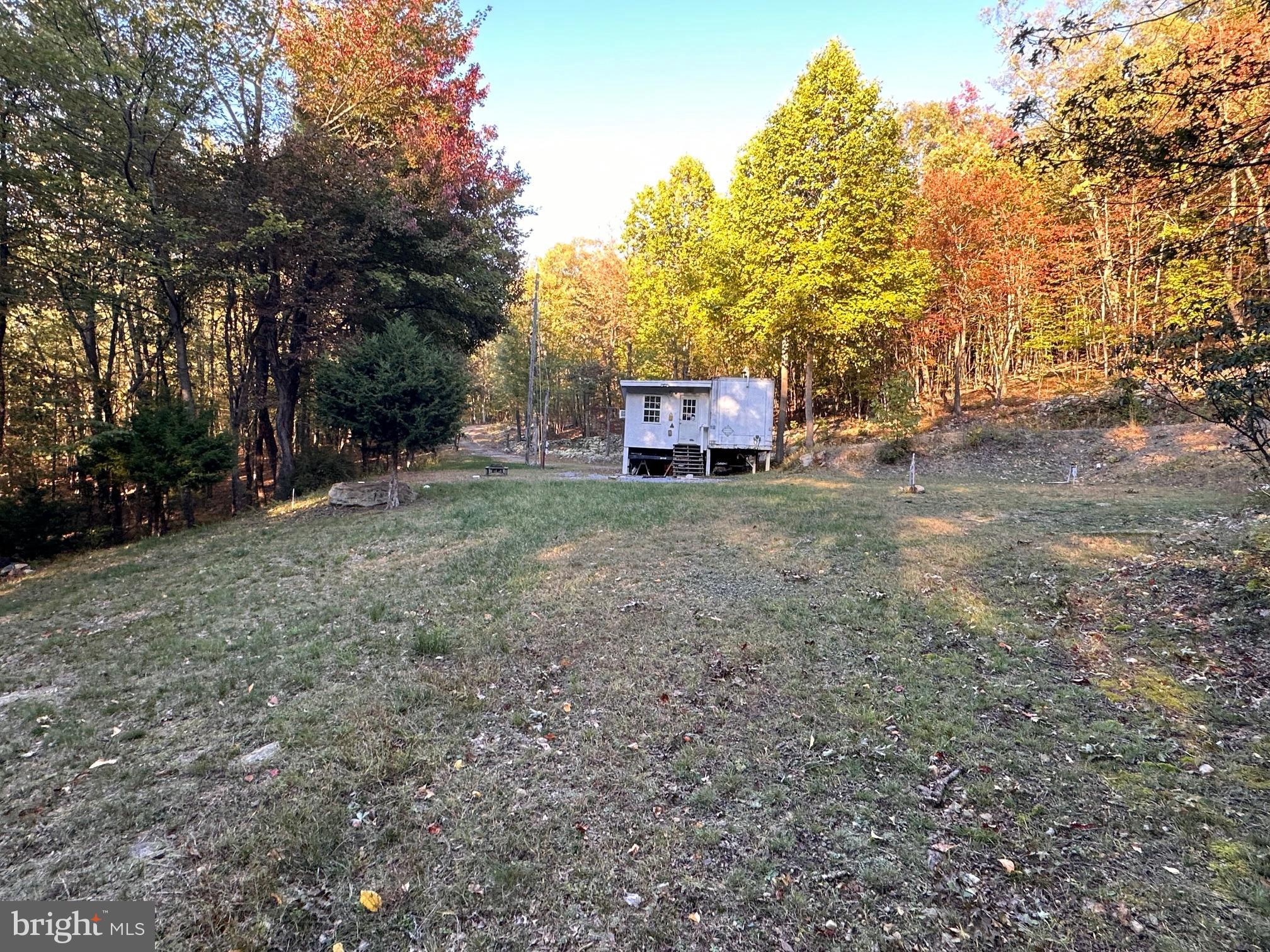 Unique property that features 6.48 acres on a private road.  Land is set up with electricity and is improved.  A structure is on the property that is considered a hunting cabin.  There is a nice work shop/shed on the property.  Seller was told a septic exists, but to use buyer due diligence regarding it.  Water as brought in and stored in barrels.  A prime place for camping, hunting, or relaxing.