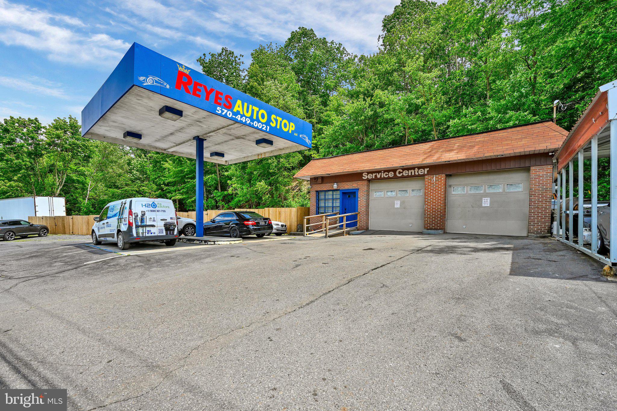 Turn-key automotive business opportunity with exceptional visibility featuring 175 feet of road frontage. This well-maintained commercial property offers a paved lot with parking for approximately 20+ vehicles, plus a fenced storage area for an additional 12+ vehicles. The property also includes two storage truck bodies, a carport, security system, and dusk-to-dawn exterior lighting for added convenience and peace of mind. The office space is move-in ready with all office furniture included, along with a safe, locked key storage system, newer flooring, and an updated restroom (2nd 1/2 bathroom w/exterior entrance would need renovations). The building is handicap accessible with a newer entrance ramp. The garage is fully equipped for immediate operation and includes a tire changer, wheel balancer, vehicle lift, engine lift, air compressor, waste oil burner for heat, and a variety of additional tools that will remain with the property. Other features include two 9' x 9.5' overhead garage doors and updated electrical service.  Whether you're expanding an existing operation or launching your own automotive business, this property is ready to go from day one.  'Seller financing' is available with a minimum 25% down payment, offering a unique opportunity for qualified buyers.