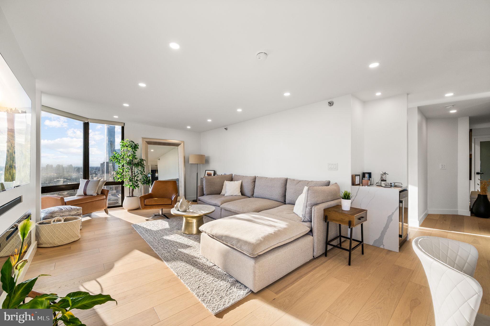 Rare find in Rittenhouse!!  Two condominiums combined to create a 1750 Sq Ft 3 bedroom, 3 bath home with sweeping city views from the 29th floor of the Wanamaker House.  The modern open floor plan offers an airy sophistication with high-end finishes throughout. This home is flooded with natural light and you’ll be in awe of the sensational sunsets and twilight views from the floor-to-ceiling windows in every room. The chef’s kitchen features quartz counter tops, custom wood cabinets, counter-depth paneled appliances including a Bosch cooktop, Miele Oven, Fisher and Paykel refrigerator, and dishwasher, plus a wine cooler. The kitchen opens up into the spacious great room with an electric fireplace.  The primary suite boasts a custom walk-in closet and a luxurious en-suite bath with a large walk-in shower and quartz vanities. The second bedroom also has an ensuite with a bathtub.  Additional features of the home include white oak hardwood flooring and recessed lighting throughout, 3 HVAC zones, an LG washer and dryer, and motorized window treatments.  The Wanamaker house has a newly renovated lobby and hallways with a contemporary design. Residents enjoy a 24-hour door person, gym with sauna, reading lounge, entertaining space with a catering kitchen, and a seasonal rooftop pool with panoramic city views! An assigned parking space can be rented for an additional fee subject to availability.  The building is cat friendly. The convenient location of Wanamaker House allows for easy access to 30th Street Station, Penn, Drexel, Wharton School of Business, The Schuylkill River path, and is just steps away from Rittenhouse Square, and numerous desirable restaurants, cafes, boutiques, and much more.    Please note the total 2024 Real Estate Taxes for the combined units are $10,500.  Garage Parking available for rent subject to availability.