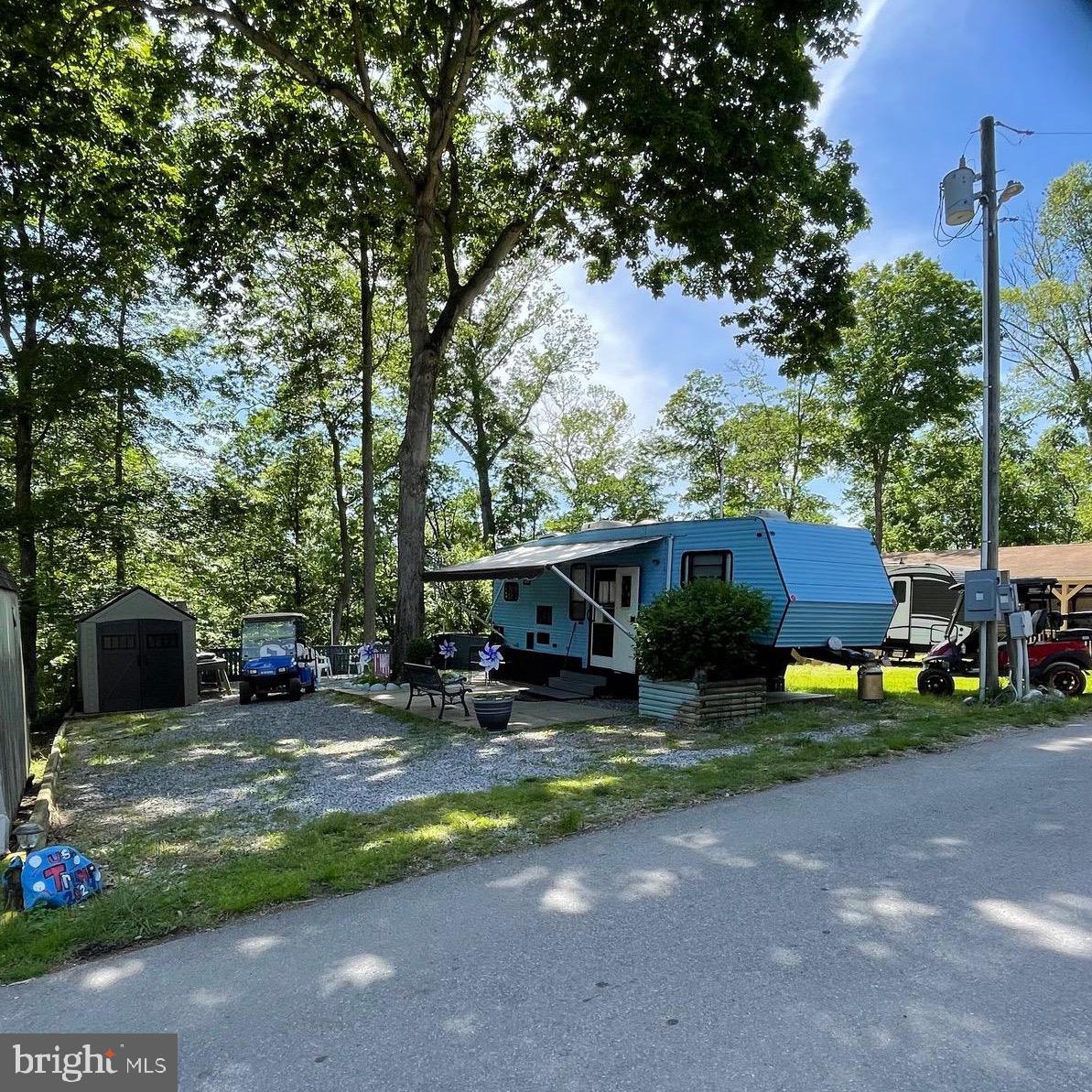 To view the property and Riverbend park since this is a gated community so you need to enter at the guard shack. Entry is not permitted without ID per the office rules. Bring ID's to the office or guard shack for visitor pass.
 THIS IS A SEASONAL CAMPGROUND -OPEN FROM APRIL 1 TO NOVEMBER 1.   River Bend is a privately owned 400 acre recreational- vehicle camp resort with seasonal activities for members, families and guests. This great RV park is tucked away on the Upper Potomac River of West Virginia, River Bend is one of West Virginia's most popular family seasonal destinations. . Just a short drive from the Washington and Baltimore metro area. Open with utilities from April 1 to November 1. (Lot owners have access to their property during the off season).   Riverbend Park offers lots of fun and entertainment, or a great place to get away and relax.  
10 miles of Deep water on the Potomac River, access for boating, fishing & swimming and other park amenities  include 3 swimming pools, putt putt course, Horseshoe club, Boat club, Poker runs, Trick or Treat, Christmas in July, live bands, basketball court, tennis court, fireworks, car show, Church, restaurant, bar, convenience store, playground, volleyball, ball field and much much more. 
This lot is ready to enjoy now all set up with 1995 clean camper,  bedroom with King size bed, couch that pull out to bed, and dining table can be set up for sleeping area.  TV's convey and 2 shed, and also the gas golf cart which is a 4 seater.  The roof on camper was recently sealed, newer 30 gallon hot water heater, there is 2nd refrigerator to convey, crank out awning and lot backs to trees.  Ready for some fun and/or relaxation?  Come check it out!