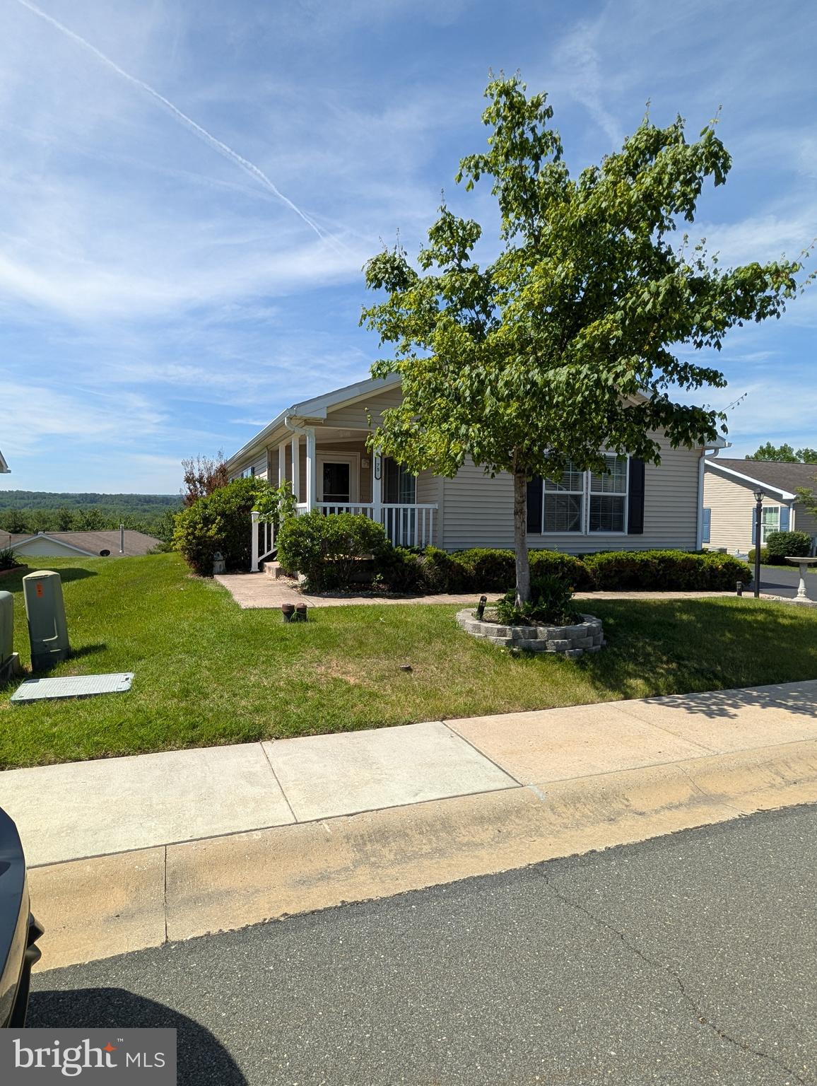 Beautiful "Clover" model in highly desirable "Douglass Village" Community. This lovely home features a covered front porch which welcomes you into a spacious 18' living room. The bright & sunny family room includes lots of windows and patio door which opens to the front porch. It also features 2 bedroom and 2 baths, formal dining area, large utility room, well-appointed kitchen with double bowl stainless sink, electric range, convenient breakfast bar, dishwasher, and lots of cabinetry. The Master bedroom has a walk-in closet, adjoining master bath with large 2-seat shower. Lot lease includes use of the community center with outdoor heated pool, library, fitness center, game room & banquet room. Other features include ceiling fans, 2-car garage with door into utility room, and a beautiful view! Very well maintained.. Don't miss this one!