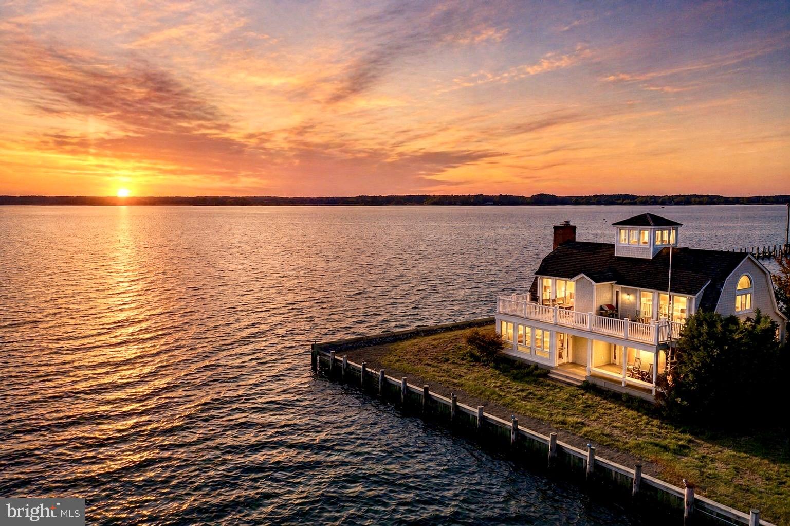 Welcome to Tred Avon Point, an extraordinary waterfront property on a stunning point of land in the picturesque, historic town of Oxford, MD. Strategically sited only 25 feet to the waters edge on three sides to capture breathtaking views of the Tred Avon River & amazing western sunsets! Maritime inspired post & beam, open design visually connects the views to the space. The character & depth of the architecture blurs the lines between indoor & outdoor living. The abundance of the wood toned palette play with the hue & saturation of the natural landscape. The space easily transitions from entertaining friends & family to a respite for homeowners. The perfect vantage point to watch the boats, sailing races & watermen go by. Two primary suites on each level can be reached by the nautically designed wood spiral staircase or elevator. Gorgeous custom designed kitchen renovation done in 2019. The guest suite on the first level enjoys the views from its private deck. The rooftop cupula offers a stunning 360 degree birdseye view of the town & water. All season beauty can be enjoyed even in winter in front of the recently installed, high-end brick fireplace. The property includes a shared lot with a 7ft MLW deepwater multislip dock with lift. Perfectly located near dining, yacht club & marinas yet still invoking quiet & privacy. The included furniture, fine art & accessories create a move-in ready primary, 2nd home or vacation rental. Truly a one of a kind home!