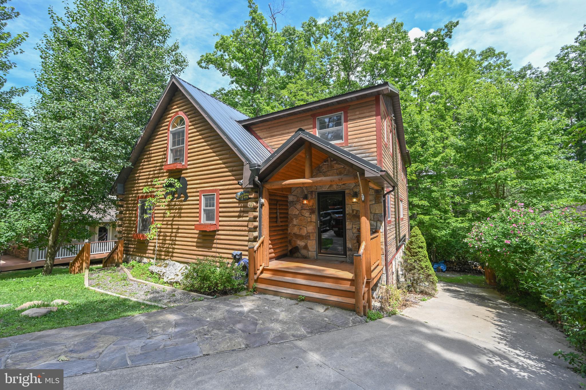Discover tranquility in this unique log home nestled on a beautiful lakefront lot.  With five unique bedrooms and four luxurious baths, this charming retreat offers the perfect blend of rustic elegance and modern comfort. Imagine mornings by the water and evenings by the fireplace, all within your own secluded paradise.  Charming touches throughout, with a vaulted ceiling living area and a stone gas fireplace.  Charming wood and log ceilings throughout the main level.  The kitchen is a delight with a large pantry off of it.  The dining area has room for all and steps out to a deck for outside dining.  The perfectly private and spacious primary bedroom is an oasis, with a private balcony.  It has a beautifully appointed, recently added bath with a wonderful tiled shower and double sink.  There is a second perfectly appointed recent bath addition on the upper level  that also has a double sink and tiled shower.  A cathedral bunk room and laundry completes the upstairs picture.  Main level bedroom and charming bath, with a lower level family room, 2 bedrooms and a bath.  Room for all your family and friends!  Just steps to your hot tub.  At the water's edge there is a landscaped fire pit and a private Type A dock. If the electricity goes out in one of our beautiful winter storms, no problem, as the home has a generator! Don't miss your chance to own this exquisite piece of lakefront living!