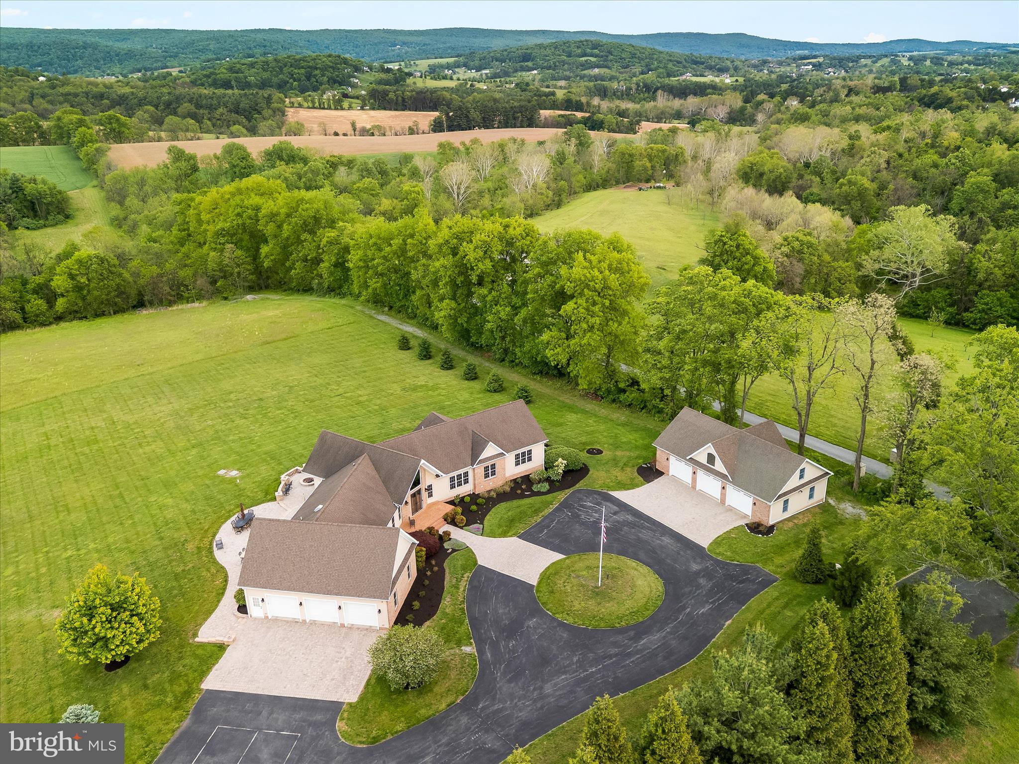 Picturesque in every way from the calming  tree lined entrance to the long winding drive cresting at the ridge of a breathtaking private hilltop.  This estate is instantly breathtaking providing gentle breezes, stunning skies and views in all directions.  The custom brick and hardi-plank 5 bedroom, 6 bath lux farmhouse on one level features an enormous walkout finished basement and is perfectly situated to appreciate the sky theatre that surrounds.  A chef inspired kitchen with gas Wolf stove  and double ovens with convection and pot filler.  The open style great room has a 2 story stone fireplace and gas log cozy den with built in bench seats nestled in sun drenched windows overlooking nearly 26 expansive and very useful acres.  Walk out to an over 2000 square ft patio, outdoor kitchen and island entertaining space, private owners patio with outdoor shower and fire pit overlooking the valley.  Reclaimed Hickory floors, new well padded carpet and serene finishes top off the farmhouse luxury on the interior.  The balance of welcoming nature indoors is peacefully apparent.  The estate offers 3 attached garage spaces and 3 detached spaces.  Both are generously oversized with work benches, gardening and tool storage as well as potential for an upstairs studio home or man cave with decoy/hunting storage.  The detached features an entire upstairs roughed in for your adventures, an existing half bath with a shower rough in, metal shelving with rolling ladders, water, water heater, LP, cable and ample space on 2 floors in 30 x 50 space.  For entertainment, you'll enjoy a lower level game room, gym, full walkout and an incredible bonus space on the lower quarter of the property.  Awaiting your family fun celebrations is a 26 x 52 party pavilion complete with patio, solar lights, rambling creek, shooting range, hunting blind  and space to do literally, whatever you want - camp, play, party, relax, it's perfect in every way for every thing!   Sellers have a full list of preferred vendors and utility information to share with new owners.  The built in speaker system, hardwired security operations, 3M tinted windows, Lutron lighting for interior and exterior efficient control, whole house propane generator, 1000g buried LP tank,  water filtration with UV light protection and softener and so much more are all indicative of pride and quality.  Seeing is truly believing on this incredible estate property.  For multigenerational and compound buyer enthusiasts, this home checks the boxes via a lower level apartment, an upper level detached garage apartment and an additional “tenant house” homesite.  We kindly ask that you please do not enter the private driveway without an appointment. 
All tours will require financial support and approval.